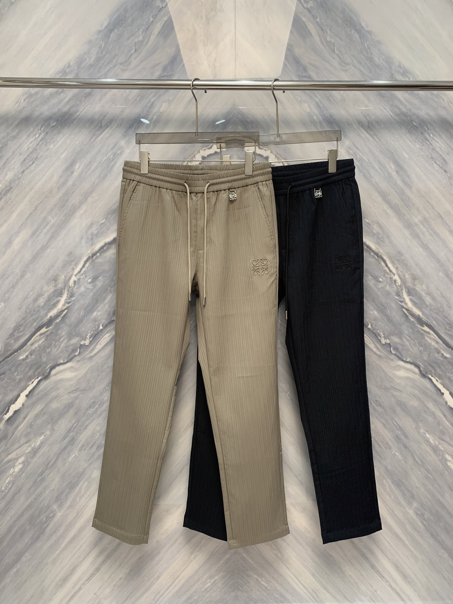 NO:526532,In the cool atmosphere of early autumn, LOE pleated company launched a strikingly embroidered small straight-leg casual sweatpants for men. The details are handled quite exquisitely, perfectly combining elegance and leisure, adding a unique touch to men's autumn wardrobe. In terms of fabric selection, LOE pleated company insists on using high-quality, comfortable and breathable materials to ensure that the wearer can feel comfortable in all occasions. The style of the sweatpants is designed with a small straight, which just rightly modify the leg shape, and it will neither be too tight nor loose. Whether it is daily leisure or light exercise, it can be easily dealt with.  The most eye-catching thing is the embroidery embellishment on this trouser. The exquisite embroidery pattern not only shows the brand's ultimate pursuit of details, but also adds a three-dimensional and high-end sense to the whole pants. The design of embroidery is inspired by the combination of natural elements and contemporary art, which integrates art and clothing through delicate needlework. In terms of color, the designers carefully selected tones suitable for early autumn. Classic dark and light colors are not only easy to match, but also visually create a deep and high-end texture. At the same time, these colors are also very dirty and suitable for daily wear, whether for urban commuting or casual gatherings, you can show your unique taste. Wear it and experience unprecedented comfort and fashion.' Color: Khaki Navy Size: M-3XL M: Waist circumference 76-80 Pants length 101 hip circumference 102 L: Waist circumference 80-84  Pants length 102 hip circumference 106 XL: waist circumference 84-88 pants length 103 hip circumference 110 XXL: waist circumference 88-92 pants length 104 hip circumference 114 3XL: waist circumference 92-96 pants length 105 hip circumference 118,,loewe,alexander wang19860909在早秋微凉的氛围中,LOE褶皱公司推出了一款令人瞩目的万针刺绣点缀小直筒男士休闲卫裤.这款卫裤在细节上处理得相当精致,完美地融合了优雅与休闲,为男士们的秋季衣橱增添了一抹别致的风采.从面料的选择上,LOE褶皱公司坚持采用高质量、舒适透气的材料,确保穿着者在各种场合下都能感到自在.卫裤的版型设计为小直筒,恰到好处地修饰了腿型,既不会过于紧绷也不会显得松垮.无论是日常休闲还是轻度运动,都能轻松应对. 最为引人注目的是这款卫裤上的万针刺绣点缀.精美的刺绣图案不仅展现了品牌对于细节的极致追求,更为整条裤子增添了立体感和高级感.刺绣的设计灵感源自自然元素与当代艺术的结合,通过细腻的针法将艺术与服饰融为一体.在色彩方面,设计师们精心挑选了适合早秋的色调.经典的深色和浅色,不仅易于搭配,还能在视觉上营造出深邃、高级的质感.同时,这些颜色也十分耐脏,适合日常穿着,无论是都市通勤还是休闲聚会,都能展现您的独特品味.穿上它,体验前所未有的舒适与时尚.” 颜色:卡其色 藏青色 尺寸:M-3XL M:腰围76-80 裤长101 臀围102  L:腰围80-84 裤长102 臀围106  XL:腰围84-88 裤长103 臀围110  XXL:腰围88-92 裤长104 臀围114  3XL:腰围92-96 裤长105 臀围118,,loewe,alexander wang,Men's clothing