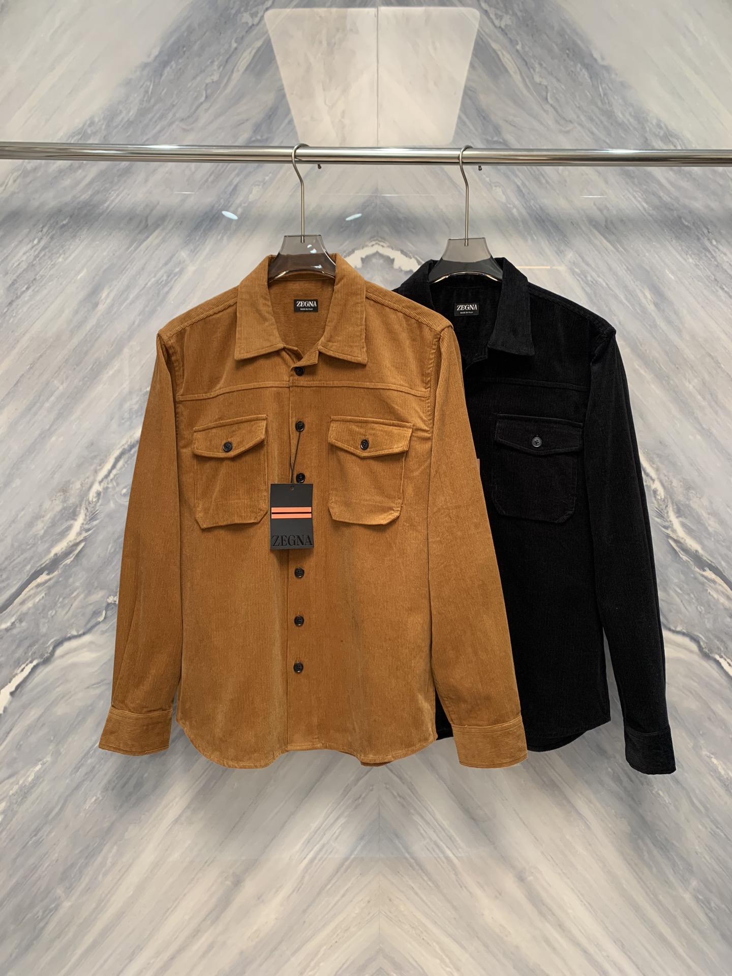 NO:608416,The warp and weft shine, a new chapter in gentleman's clothing - EZ business fashion men's lapel corduroy work shirt. When classic materials and modern tailoring meet in the lapel, a shirt is no longer just a dress, but a statement of style and texture. The business fashion men's lapel corduroy work shirt, which is simultaneously on sale at the EZ brand counter, redefines the high-end daily life of urban men's wardrobe with unique fabrics, exquisite details and restrained aesthetics. This  This shirt is made of high-density thin-strip corduroy fabric, with fine velvet like silk, and a warm and soft touch. It combines the skin-friendliness of cotton with the unique micro-velvet luster of corduroy. It has been treated with a special anti-indentation process, making the body crisp and stylish.  It does not wrinkle after sitting for a long time, has a natural drape, and presents a silk-like subtle rhythm of light and dark in the flow of light and shadow, showing a high-end texture in a low-key manner. The fabric is moderately thick, warm and breathable, and perfectly fits the seasonal transition from early autumn to early winter.  In terms of design, it combines the functional aesthetics of work shirts with the neat lines of business fashion. The lapels are crisp and well-shaped, and the collar corners are slightly drooped, retaining a sense of formality without losing the relaxed temperament. The three-dimensional flap pockets are symmetrically set up on the left and right sides of the chest, with simple lines and exquisite proportions, which combine the beauty of practical storage and visual balance. The placket adopts a hidden hidden button design, and the buttons are made of matte resin material. The color is calm and blends with the fabric to eliminate visual clutter. The tailoring is made of  Slightly slim straight silhouette, precise shoulder line, moderately loose sleeves, easy to move but not baggy. The cuffs are opened and closed with a single button, the edges are neatly hemmed, and the details are meticulous. The micro pleat design on the back shoulder blades improves freedom of movement.  The EZ shirt uses corduroy as the pen and tailoring as the ink, injecting the soul of gentleman's clothing into the skeleton of work clothes - wearing it is a sign of calmness, taste, and a silent insistence on the quality of life.  Color: Black Caramel Size: S-XL S bust 112 length 72 shoulder width 46 sleeve length 64 M bust 116 length 73 shoulder width 47 sleeve length 65 L bust 120 length 74 shoulder width 48 sleeve length 66 XL bust 124 length 75 shoulder width 49 sleeve length 67,,shirts,alexander wang19860909经纬生辉,绅装新章——EZ商务时装男士翻领灯芯绒工装衬衫臻品品鉴当经典材质与现代剪裁在衣襟间相遇,一件衬衫便不再仅是着装,而成为风格与质感的宣言.EZ品牌柜台同步在售的商务时装男士翻领灯芯绒工装款衬衫,以独特面料、精工细节与克制美学,重新定义都市男性衣橱中的高级日常.此款衬衫甄选高密度细条灯芯绒面料,绒沟细腻如丝,触感温润柔和,兼具棉质的亲肤与灯芯绒特有的微绒光泽.经特殊防压痕工艺处理,衣身挺括有型,久坐不褶,垂感自然,于光影流转间呈现出如丝绸般微妙的明暗韵律,低调中尽显高级质感.面料厚度适中,保暖透气,完美契合早秋至初冬的季节过渡. 设计上,融合工装衬衫的功能美学与商务时装的利落线条.翻领造型挺括有度,领角微垂,既保留正式感,又不失松弛气质.前胸左右对称设置立体翻盖口袋,线条简洁,比例考究,兼具实用收纳与视觉平衡之美.门襟采用隐藏式暗扣设计,纽扣为哑光树脂材质,色泽沉静,与面料融为一体,杜绝视觉杂乱.剪裁采用微修身直筒廓形,肩线精准,袖筒适度宽松,便于活动却不显松垮.袖口以单扣调节开合,边缘包边工整,细节一丝不苟.背部肩胛处微褶设计,提升活动自由度,兼顾舒适与挺括.EZ此款衬衫,以灯芯绒为笔,以剪裁为墨,在工装的骨架中注入绅装的灵魂——穿于身,是沉稳,是品位,更是对生活质感的无声坚持. 颜色:黑色 焦糖色 尺寸:S-XL S胸围112 衣长72 肩宽46 袖长64 M胸围116 衣长73 肩宽47 袖长65 L胸围120 衣长74 肩宽48 袖长66 XL胸围124 衣长75 肩宽49 袖长67,,shirts,alexander wang,Men's clothing