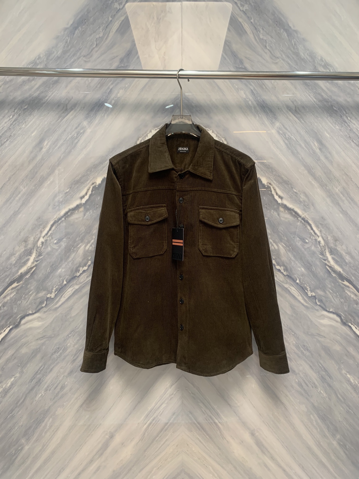 NO:608411,The warp and weft shine, a new chapter in gentleman's clothing - EZ business fashion men's lapel corduroy work shirt. When classic materials and modern tailoring meet in the lapel, a shirt is no longer just a dress, but a statement of style and texture. The business fashion men's lapel corduroy work shirt, which is simultaneously on sale at the EZ brand counter, redefines the high-end daily life of urban men's wardrobe with unique fabrics, exquisite details and restrained aesthetics. This  This shirt is made of high-density thin-strip corduroy fabric, with fine velvet like silk, and a warm and soft touch. It combines the skin-friendliness of cotton with the unique micro-velvet luster of corduroy. It has been treated with a special anti-indentation process, making the body crisp and stylish.  It does not wrinkle after sitting for a long time, has a natural drape, and presents a silk-like subtle rhythm of light and dark in the flow of light and shadow, showing a high-end texture in a low-key manner. The fabric is moderately thick, warm and breathable, and perfectly fits the seasonal transition from early autumn to early winter.  In terms of design, it combines the functional aesthetics of work shirts with the neat lines of business fashion. The lapels are crisp and well-shaped, and the collar corners are slightly drooped, retaining a sense of formality without losing the relaxed temperament. The three-dimensional flap pockets are symmetrically set up on the left and right sides of the chest, with simple lines and exquisite proportions, which combine the beauty of practical storage and visual balance. The placket adopts a hidden hidden button design, and the buttons are made of matte resin material. The color is calm and blends with the fabric to eliminate visual clutter. The tailoring is made of  Slightly slim straight silhouette, precise shoulder line, moderately loose sleeves, easy to move but not baggy. The cuffs are opened and closed with a single button, the edges are neatly hemmed, and the details are meticulous. The micro pleat design on the back shoulder blades improves freedom of movement.  The EZ shirt uses corduroy as the pen and tailoring as the ink, injecting the soul of gentleman's clothing into the skeleton of work clothes - wearing it is a sign of calmness, taste, and a silent insistence on the quality of life.  Color: Army Green Size: S-XL S Bust 112 Length 72 Shoulder Width 46 Sleeve Length 64 M Bust 116 Length 73 Shoulder Width 47 Sleeve Length 65 L Bust 120 Length 74 Shoulder Width 48 Sleeve Length 66 XL Bust 124 Length 75 Shoulder Width 49 Sleeve Length 67,,shirts,alexander wang19860909经纬生辉,绅装新章——EZ商务时装男士翻领灯芯绒工装衬衫臻品品鉴当经典材质与现代剪裁在衣襟间相遇,一件衬衫便不再仅是着装,而成为风格与质感的宣言.EZ品牌柜台同步在售的商务时装男士翻领灯芯绒工装款衬衫,以独特面料、精工细节与克制美学,重新定义都市男性衣橱中的高级日常.此款衬衫甄选高密度细条灯芯绒面料,绒沟细腻如丝,触感温润柔和,兼具棉质的亲肤与灯芯绒特有的微绒光泽.经特殊防压痕工艺处理,衣身挺括有型,久坐不褶,垂感自然,于光影流转间呈现出如丝绸般微妙的明暗韵律,低调中尽显高级质感.面料厚度适中,保暖透气,完美契合早秋至初冬的季节过渡. 设计上,融合工装衬衫的功能美学与商务时装的利落线条.翻领造型挺括有度,领角微垂,既保留正式感,又不失松弛气质.前胸左右对称设置立体翻盖口袋,线条简洁,比例考究,兼具实用收纳与视觉平衡之美.门襟采用隐藏式暗扣设计,纽扣为哑光树脂材质,色泽沉静,与面料融为一体,杜绝视觉杂乱.剪裁采用微修身直筒廓形,肩线精准,袖筒适度宽松,便于活动却不显松垮.袖口以单扣调节开合,边缘包边工整,细节一丝不苟.背部肩胛处微褶设计,提升活动自由度,兼顾舒适与挺括.EZ此款衬衫,以灯芯绒为笔,以剪裁为墨,在工装的骨架中注入绅装的灵魂——穿于身,是沉稳,是品位,更是对生活质感的无声坚持. 颜色:军绿色 尺寸:S-XL S胸围112 衣长72 肩宽46 袖长64 M胸围116 衣长73 肩宽47 袖长65 L胸围120 衣长74 肩宽48 袖长66 XL胸围124 衣长75 肩宽49 袖长67,,shirts,alexander wang,Men's clothing