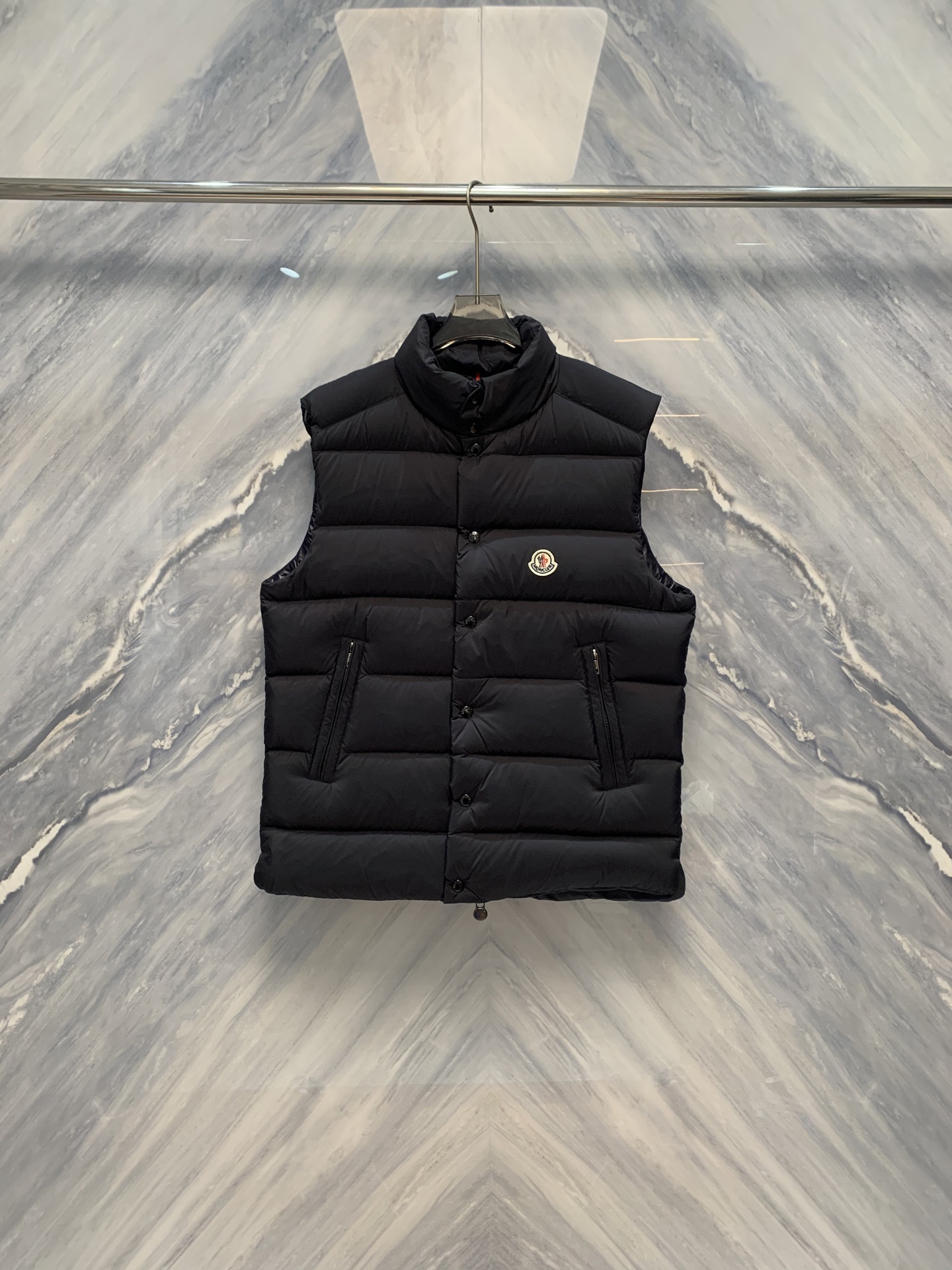 NO:608417,The realm of light feathers. The M family's new autumn and winter down vest contains the ultimate craftsmanship in the minimalist silhouette. This new men's autumn and winter down vest is on sale at the M family counter at the same time. Inspired by the spirit of ice and snow on the top of the Alps, it condenses lightness, warmth and high-end sense into a sleeveless shape, creating a cold-resistant masterpiece that transcends seasonal boundaries. The whole garment adopts the M family's iconic checkered quilting structure, each grid size is precisely unified, and the lines are as straight as  Hand-painted by craftsmen, it forms a visual rhythm with a strong sense of order. The quilting depth and density have been repeatedly measured to ensure that 90 high-fill European white goose down is evenly distributed to prevent the accumulation of cold spots. The fill power is as high as 750+, and the filling amount is scientifically proportioned. It is as light as nothing, but like clouds wrapped around the body, achieving top thermal insulation performance. The inner liner is made of high-density diamond-resistant velvet gallbladder, which is treated with Swiss technology to prevent down from escaping, making it smooth to the touch and improving wearing comfort.  The outer fabric is made of Japan's Toray ultra-fine nylon fiber, using high-density weaving technology, which is both light and tough. The surface is treated with DWR water-repellent treatment, so that when raindrops drop, it will roll off. It has excellent wind resistance and effectively isolates cold currents. The matte texture is calm and restrained, and the color is like deep sea ink jade or noon.  The night gray stone only emits a metallic shimmer when the light flows, showing nobility in a low-key manner. The stand-up collar design is straight and neat, fitting the curve of the neck, effectively resisting the cold wind. The collar is lined with skin-friendly velvet, which feels warm and moist. The front uses a double-ended YKK resin zipper, opening and closing as smooth as silk, and the puller  Small and exquisite, it blends seamlessly with the overall tone. The diagonal pockets on both sides are designed with smooth lines, allowing hands to be inserted naturally, keeping warm and practical. The inside of the back collar is inlaid with an exclusive metal nameplate of the M family, which is simple and unpretentious. It only uses the brand symbol and origin logo to tell its orthodox origin. The entire garment is handmade in European workshops.  Hand-sewn, each process undergoes strict quality inspection, and the stitching is as fine as brocade. This vest is the sublimation of down and the philosophy of silhouette. It carries the ultimate warmth in a minimalist shape, and covers the wearer with a light and unshakable dignity between the hustle and bustle of the city and the silence of nature.  Color: Black Size: 1-5 1: Bust 114, Length 68, Shoulder Width 47 2: Bust 118, Length 69, Shoulder Width 48 3: Bust 122, Length 70, Shoulder Width 49 4: Bust 126, Length 71, Shoulder Width 50 5: Bust 130, Length 72, Shoulder Width 51,,down jacket,alexander wang19860909轻羽之境M家男士秋冬新品羽绒马甲在极简的轮廓中蕴藏极致的工艺,M家此款柜台同步在售男士秋冬新品羽绒马甲,以阿尔卑斯山巅的冰雪精神为灵感,将轻盈、温暖与高级感凝练于无袖之形,成就一件超越季节界限的御寒杰作.整衣采用M家标志性的方格绗缝结构,每一格尺寸精准统一,线条笔直如匠人手绘,构成极具秩序感的视觉韵律.绗缝深度与密度经反复测算,确保90高蓬松度欧洲白鹅绒均匀分布,杜绝冷点堆积.蓬松度高达750+,充绒量科学配比,轻若无物,却如云絮裹身,实现顶级保暖效能.内胆选用高密防钻绒胆布,经瑞士技术处理,杜绝羽绒外逸,触感柔滑,提升穿着舒适度. 外层面料甄选日本东丽超细尼龙纤维,采用高密度编织工艺,兼具轻盈与坚韧.表面经DWR防泼水处理,雨水滴落即成珠滚落,抗风性能卓越,有效隔绝寒流.哑光质感沉静内敛,色泽如深海墨玉或午夜灰岩,仅在光线流转间泛出金属般的微光,低调中尽显尊贵.立领设计挺拔利落,贴合颈部曲线,有效抵御寒风侵袭.领口内衬亲肤绒布,触感温润.前襟采用双头YKK树脂拉链,开合顺滑如丝,拉头小巧精致,与整体色调浑然一体.两侧斜插口袋设计,线条流畅,手可自然深入,保暖实用.后领内侧,镶嵌M家专属金属铭牌,简约无华,仅以品牌符号与产地标识,诉说其正统血统.整衣于欧洲工坊手工缝制,每一道工序皆经严格质检,针脚细密如织锦.此马甲,是羽绒的升华,是廓形的哲学.它以极简之形,承载极致之暖,在都市的喧嚣与自然的寂静之间,为穿着者披上一件轻盈而不可撼动的尊严. 颜色:黑色 尺寸:1-5 1:胸围114 衣长68 肩宽47 2:胸围118 衣长69 肩宽48 3:胸围122 衣长70 肩宽49 4:胸围126 衣长71 肩宽50 5:胸围130 衣长72 肩宽51,,down jacket,alexander wang,Men's clothing