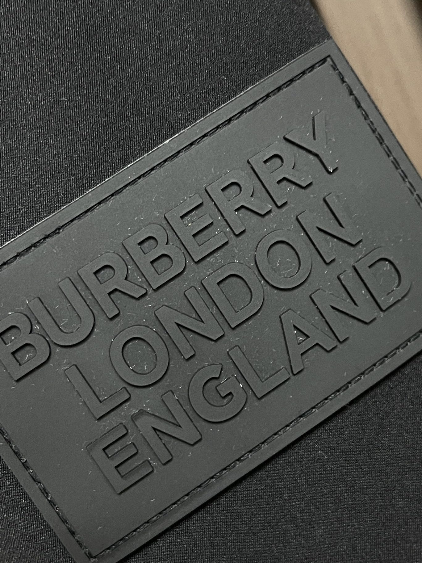 Burberry徽标图案布搭配连帽与防护性羽绒外套品牌徽标嵌花设计灵感源自1990年代英伦文化袖臂胶章装