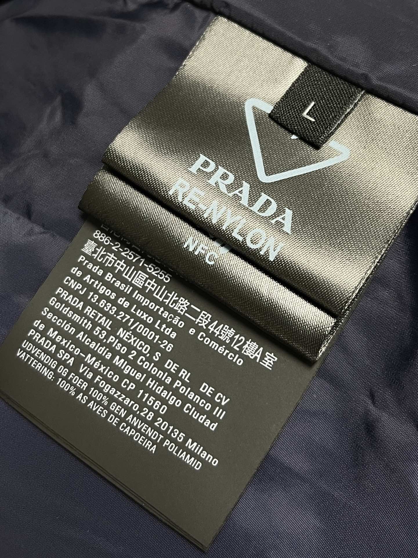 Prada连帽羽绒服面料采用40d尼龙面料尼龙面料轻盈且耐用使得羽绒服既轻便又不易损坏适合各种户外活动和