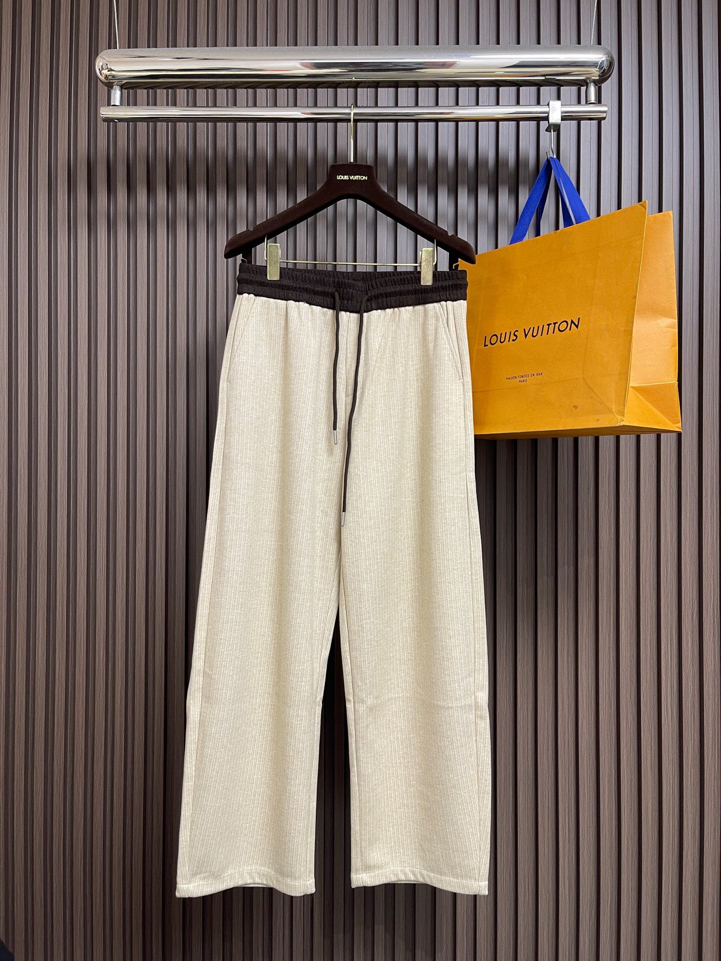 NO:646804,Jil Sander color-block wool wide-leg pants  Casual pants, these color-blocked wide-leg pants are made of custom-made wool blended fabric on the outside, interweaving the warmth of wool with the delicateness of yarn. The off-white main tone is wrapped with a low-key texture, and paired with a dark brown contrast waistband, which bursts the visual hierarchy in the simple silhouette. The milk silk lining on the inside is as smooth and skin-friendly as the second skin, completely breaking the stereotype of 'wool tied to the skin'. The brand's minimalist philosophy is reflected in every detail. Dark brown braided drawstring with metal rope ends  , injecting a sense of sophistication into casual style; the single-bag design at the back is simple and neat, and the wide-leg cut not only modifies the shape of the legs, but also gives a lazy aura when walking. Whether it is paired with a woolen sweater of the same color to create a high-end commuting style, or it collides with an oversize sweatshirt for a casual style, it has the characteristics of 'minimalist but warm' and has become the key to wearing both comfort and style in autumn and winter. Sizes XS-L,, jil  sander,versace,hoodie,sweatshirts,alexander wang19860909Jil Sander 拼色羊毛阔腿裤 休闲裤这条拼色阔腿裤外层定制羊毛混纺面料,将羊毛的柔暖与纱线的细腻交织,米白主调裹挟着低调的纹理感,搭配深棕撞色腰头,在简约廓形中迸发视觉层次；内里牛奶丝内衬,如第二层肌肤般顺滑亲肤,彻底打破'羊毛扎肤'的刻板印象.细节处尽是品牌的极简哲学深棕编织抽绳配金属绳头,为随性风格注入精致感；后幅单袋设计简约利落,阔腿剪裁在修饰腿型的同时,让行走间尽展慵懒气场.无论是搭配同色系羊毛衫打造高级通勤风,还是与oversize卫衣碰撞出休闲格调,它都以'极简却有温度'的特质,成为秋冬季节兼具舒适与腔调的穿搭密钥.尺码XS-L,,jil sander,versace,hoodie,sweatshirts,alexander wang,Men's clothing