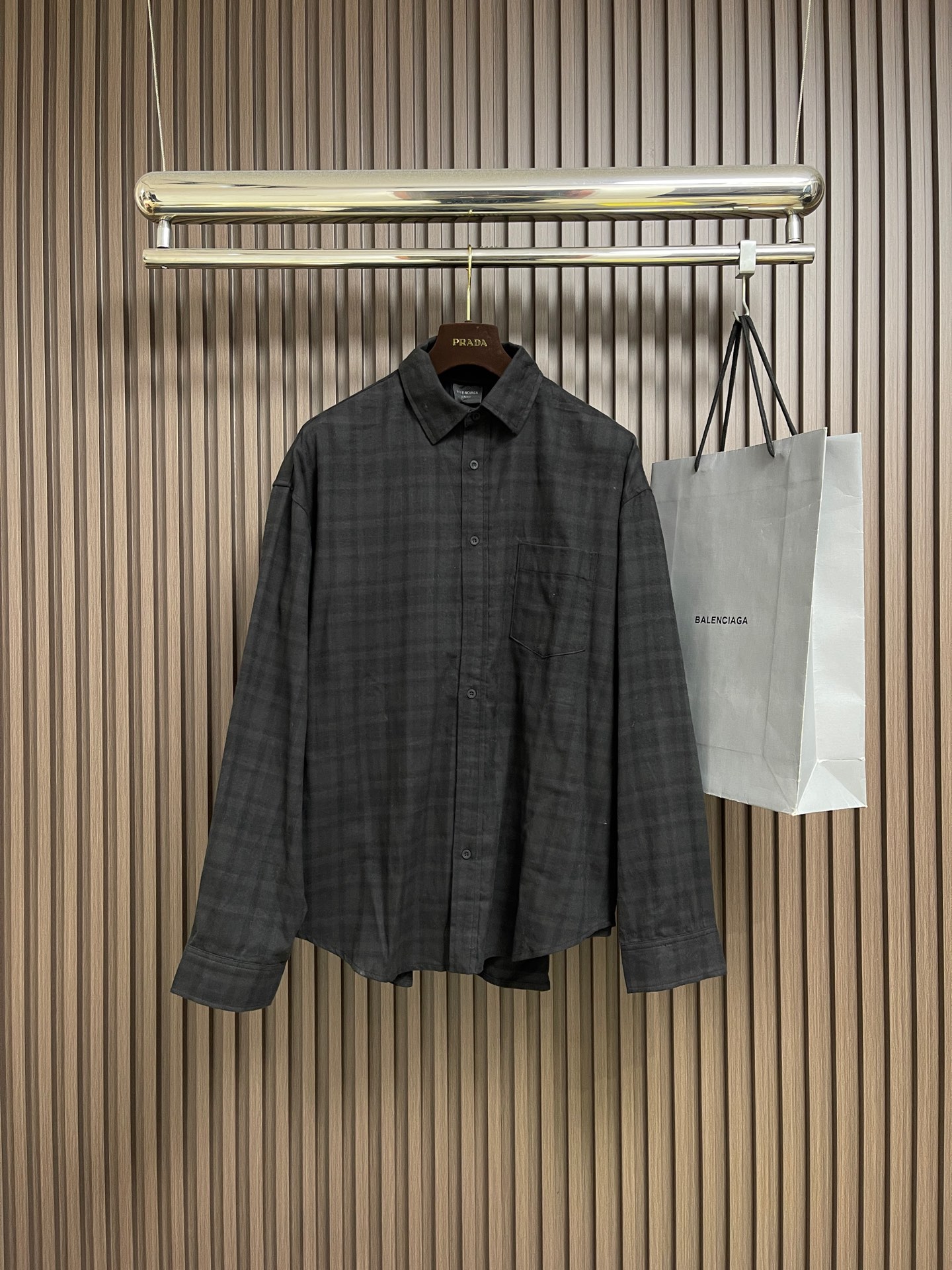 NO:597853,Balenciaga  The night scene two-piece lapel shirt uses an innovative 'two-piece' structure, combining a cotton poplin lapel shirt with a vintage jersey short-sleeve. The outer fabric is made of blended materials, through a combination of yarn configuration, weaving structure and finishing technology. The fabric is made of combed long-staple cotton, and is woven with poplin tissue through high-count and high-density yarns to form a delicate light  Luster and smooth touch. The jacquard plaid is programmed and controlled by the electronic jacquard machine to control the warp and weft yarns, and the yarns of different colors are interwoven in heavy flat, twill or square weaves. Special finishing treatment enhances the wrinkle resistance, drape and dimensional stability of the fabric. It is characterized by a tight structure and smooth surface, giving the single product a neat and boned feel. The yarn is combed to remove short fibers to ensure that the fabric is woven  The cloth surface is smooth and evenly dry; the plain weave structure makes the front and back of the fabric have the same texture, and has good breathability, ductility and softness. The post-softening treatment gives the fabric a super soft touch and reduces shrinkage. Some products will also undergo anti-pilling processing to improve durability. 13 highly complex screens are used for environmentally friendly oily dark flower paste printing. The 13 screens mean that the picture  The pattern is rich in color and the level of details is extremely fine. The environmentally friendly oil-based dark flower paste used is a high-grade printing material. It ensures that the pattern is clear and sharp, and is washable. It can also present a looming matte texture, which is smooth and non-sticky to the touch, and blends with the fabric itself. After the garments of the shirts are processed by professional washing and special processes, the garments are polished and softened as a whole.  The fabric fibers will fade and wear naturally, and slight signs of wear will appear on the bones. A silicone oil softener is added to the back section to give the cloth a soft touch. After drying and shaping, it will form a mild retro tone and soft texture, finally showing a vintage texture after natural wearing, while maintaining a stable style of clothing. The overall routing is straight and delicate, the fabric is comfortable and soft, and the color is consistent without color difference. It can be matched with the same style to create a fashionable look and control various occasions. Customized accessories, complete three standards, the same style for men and women!  Size 1-2-3-4,,balenciaga,shirts,T-shirt,alexander wang19860909Balenciaga 夜景两件套翻领衬衫,采用创新的'两件套'结构,将一件棉府绸翻领衬衫与一件复古平纹针织短袖结合.外层面料使用混纺材质,经由纱线配置、织造结构及后整理三重技术的结合.面料以精梳长绒棉为原料,通过高支高密纱线采用府绸组织织造,形成细腻的光泽与柔滑触感.提花格纹通过电子提花机对经纬纱线进行编程控制,将不同颜色的纱线以重平、斜纹或方平组织交织.特殊后整处理增强面料抗皱性、垂坠感与尺寸稳定性.其特点是结构紧密、表面光滑,赋予单品利落骨感.纱线经精梳处理去除短纤维,确保织出的布面光洁、条干均匀；平纹结构使面料正反面纹理一致,具备良好的透气性、延展性与柔软度.后整软化处理,赋予面料超柔触感并减少缩水率,部分产品还会进行抗起球加工以提升耐用性.采用了高复杂度的13个网版环保油性暗花浆印花.13个网版意味着图案色彩丰富、细节层次极为精细.所使用的环保油性暗花浆是一种高级印花材料,它在保证图案清晰锐利、耐水洗的同时,能呈现出若隐若现的哑光质感,触感平滑不粘腻,与面料本身融为一体.衬衫的成衣通过专业洗水特殊工艺处理后,对成衣进行整体打磨软化, 使面料纤维自然褪色磨损,骨位处产生轻微磨损痕迹.后段加入硅油柔软剂赋予布面柔软触感,经烘干定型后形成温和复古色调与松软肌理,最终呈现自然穿着后的古着质感,同时保持衣物版型稳定.整体走线平直细腻,面料舒适柔软,颜色一致无色差 能与同款搭配营造时尚造型,驾驭各种场合,定制辅料,三标齐全,男女同款！尺码1-2-3-4,,balenciaga,shirts,T-shirt,alexander wang,Men's clothing