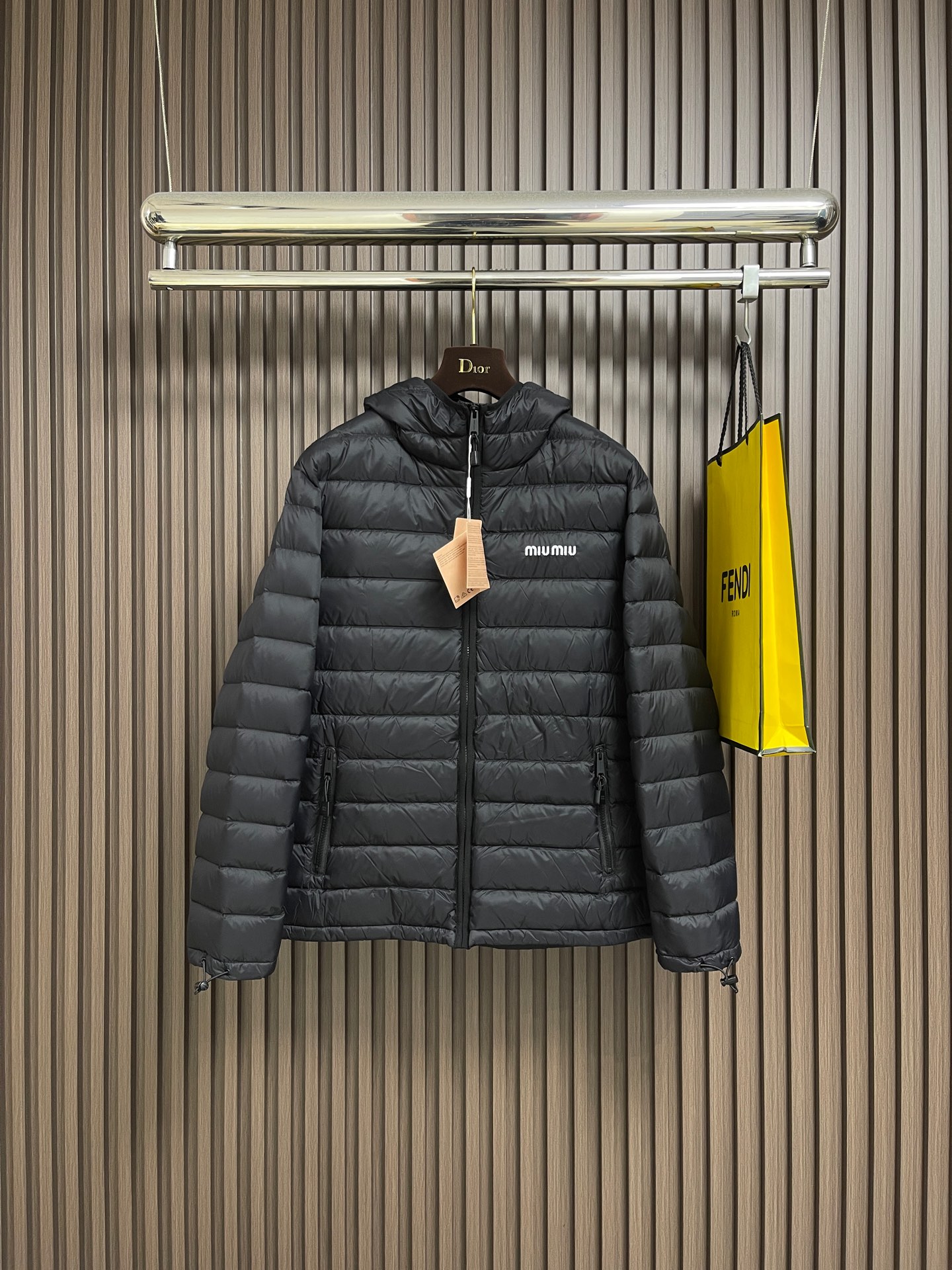 NO:646832,MIUMIU The embroidered hooded down jacket is made of high-end nylon fabric made of high-count polyamide fiber. It is famous for its excellent tensile strength and wear resistance. Its good flexibility makes the fabric less prone to wrinkles and keeps it crisp and stylish for a long time. The tight weave effectively blocks the invasion of cold wind and locks in the warm air generated by the down layer. The surface of high-density nylon forms a certain amount of charge. Leaf effect, small water droplets are not easy to penetrate, keeping the interior dry, effectively extending the service life of the down. It uses 90 national standard high-quality down, with a filling capacity of 180 grams. It has high fill power, strong warmth retention, lightness and no burden, and can easily cope with cold weather. Whether it is urban commuting or outdoor leisure, this hooded down jacket has excellent performance and simple design. It has become an indispensable item in the winter wardrobe. The logo adopts imported machine embroidery technology, using advanced computer control systems and precision mechanical components to achieve mimiu embroidery operations with high precision, smooth and delicate lines. Imported No. 7 needles + anti-velvet fine seams are used, with 13 stitches every three centimeters. The stitches are straight and do not skip stitches. Both sides of the zipper are equipped with The fabric of the cover is wrapped and sewn, so that when viewed from the front and side, the zipper teeth and chain straps are almost invisible. The hemming does not stop at the collar, but continues upward, and only a coherent and flat suture line can be seen. It achieves perfect windproof continuity and creates a smooth and advanced line sense. Sizes 46-52,,miumiu,down jacket,hats,alexander wang19860909MIUMIU 饰刺绣连帽羽绒服,面料选用高支数的聚酰胺纤维打造的高端尼龙面料,以出色的抗拉强度和耐磨性能著称,其良好柔韧性使面料不易起皱,长久保持挺括有型.紧密的织法有效阻挡冷风侵袭,锁住羽绒层产生的暖空气.高密度尼龙表面形成一定的荷叶效应,小水滴不易渗透,保持内部干爽,有效提升羽绒使用寿命.采用90国标高品质羽绒,充绒量达到了180克,蓬松度高、保暖性强,轻盈无负担,轻松应对寒冷天气.无论是都市通勤还是户外休闲,这件连帽羽绒服皆以出色性能和简约设计,成为冬季衣橱中不可或缺的单品,徽标采用进口机刺绣工艺,使用先进的计算机控制系统和精密的机械部件,实现mimiu刺绣作业,精度高、线条流畅且细腻.选用进口7号针＋防绒细线缝,每三公分达13针,线迹顺直,不跳针.拉链的两侧被配套的面料包裹缝合,使得从正面和侧面看,几乎看不到拉链的齿和链带,包边不是到领口就停止,而是继续向上,只能看到一条连贯、平整的缝合线.实现完美的防风连续性,更创造了流畅,高级的线条感.尺码46-52,,miumiu,down jacket,hats,alexander wang,Men's clothing