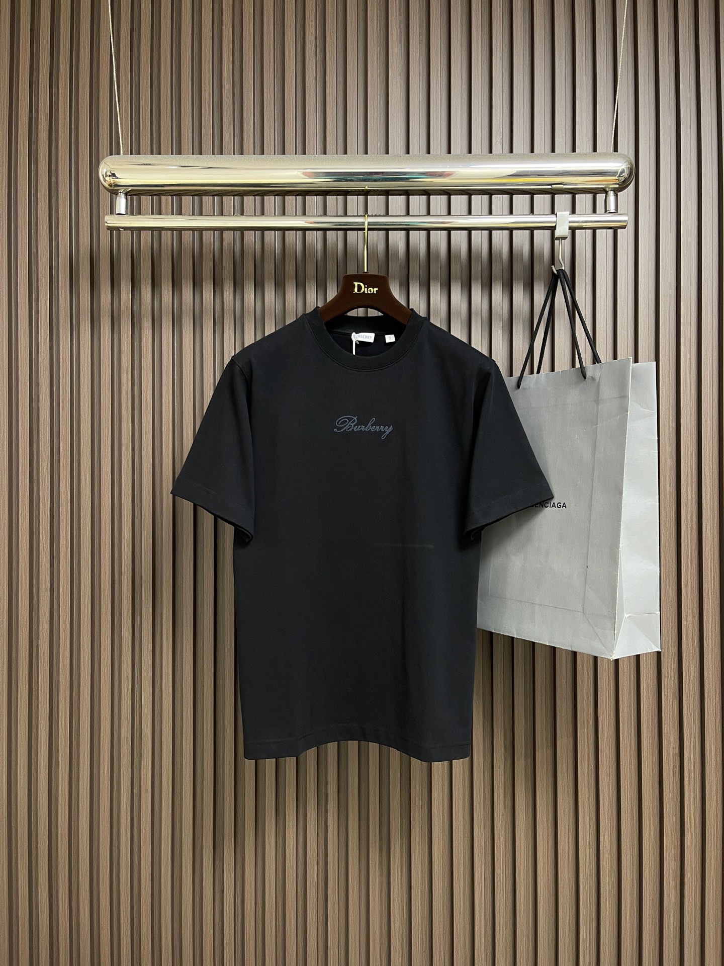 NO:646841,Burberry plaid back letter embroidered round neck short-sleeved T-shirt, made of 15S fine cotton plain weave, white 230g, black 310g; matching  32S double yarn tensioner thread, 300g. Made of pure cotton plain weave fabric, this weave has a tight structure, giving the fabric a crisp texture and excellent durability, while retaining the natural breathability and skin-friendly properties of cotton. The plain weave fabric is not easy to deform and avoid  It avoids an overly baggy casual feel and provides a neater silhouette. The chest and back are embellished with letter logo embroidery, forming a visual rhythm that echoes the front and rear, all presented through chain stitch embroidery technology. These logos are also embroidered with high precision  Craftsmanship ensures clear edges, firmness and durability. The unique embroidery technique, whose stitches are interlocking like a chain, has a stronger three-dimensional sense, softer touch, and a unique texture and luster. Using this process to present the classic plaid pattern is an innovative deconstruction of the brand's traditional elements. It transforms the original flat pattern into a three-dimensional texture with handicraft warmth, which greatly enhances the sophistication and value of the design. The overall wiring is straight and delicate, the fabric is comfortable and soft, and the colors are consistent and without color difference.  It can be matched with the same style to create a fashionable look, and can be used in various occasions. Customized accessories, complete with three standards, same style for men and women!  Size XS-L,,burberry,T-shirt,tees,t-shirt,alexander wang19860909Burberry 格子背字母刺绣圆领短袖T恤,采用15S精棉平纹,白230g、黑310g；搭配 32S双纱拉架螺纹,300g.采用纯棉平织面料,这种织法结构紧密,赋予面料挺括的骨感和优异的耐久性,同时保留了棉天然的透气与亲肤特性.平织面料不易变形,避免了过于松垮的随意感,提供了更为利落的轮廓.前胸及背部均点缀字母徽标刺绣,构成了前后呼应的视觉节奏,均通过链式缝线刺绣工艺呈现.这些徽标同样采用高精度的刺绣工艺,确保边缘清晰、牢固耐用.独特的刺绣技法,其线迹如同链条般环环相扣,立体感更强、触感更柔软,且具有独特的纹理光泽.将经典的格纹图案用此种工艺呈现,是对品牌传统元素的一次创新解构,它将原本平面的图案转化为具有手工艺温度的立体肌理,极大地提升了设计的精致度和价值感.整体走线平直细腻,面料舒适柔软,颜色一致无色差 能与同款搭配营造时尚造型,驾驭各种场合,定制辅料,三标齐全,男女同款！尺码XS-L,,burberry,T-shirt,tees，t-shirt,alexander wang,Men's clothing