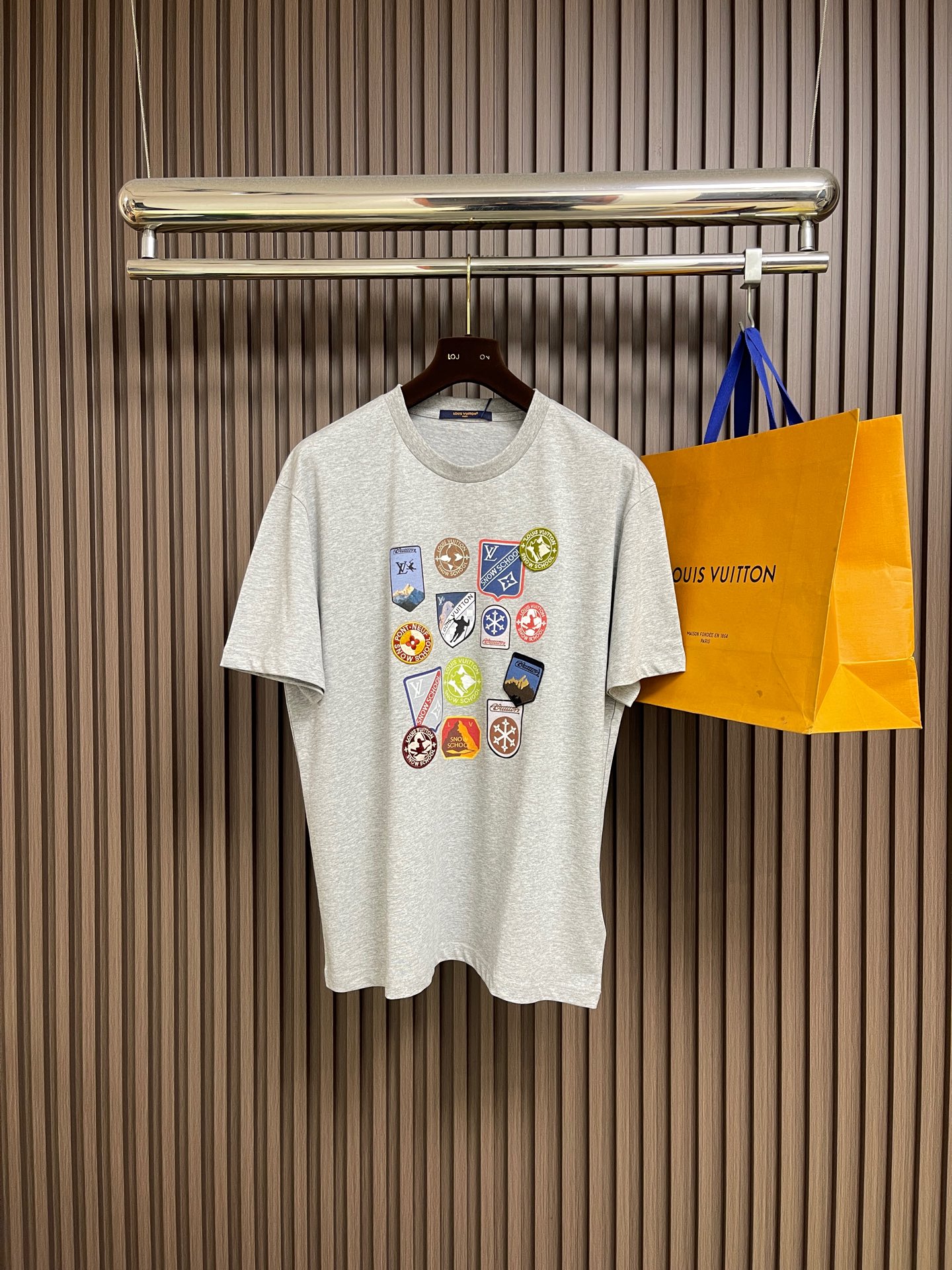 NO:597860,LV  SKI Ski Sleeve Round Neck Short Sleeve T-shirt. The T-shirt is made of pure cotton fabric, which is skin-friendly, breathable and has a good drape. The neckline is designed with a round neck and is processed by double-needle seaming process. The collar shape is flat and not easy to deform. The chest badge is combined with hand embroidery + patching technology. Multiple badges with different patterns are precisely sewn in position. The embroidery stitches are fine, the edge of the patch is flat, the colors are rich and the layers are distinct, creating a perfect look.  Decorative effect with visual impact. The overall cut is a loose-shouldered version, and the multi-piece structure is spliced to ensure comfort and freedom when wearing. The fabric is dyed with an environmentally friendly process, and the gray color is uniform and has excellent color fastness. It is a personalized item that combines exquisite embroidery technology with a casual T-shirt style. It has both fashion sense and wearing comfort. The overall wiring is straight and delicate, the fabric is comfortable and soft, and the color is consistent without color difference.  It can be matched with the same style to create a fashionable look, and can be used in various occasions. Customized accessories, complete with three standards, same style for men and women!  Size S-XL,,louis vuitton,T-shirt,tees,t-shirt,alexander wang19860909LV SKI滑雪系袖圆领短袖T恤,该T恤采用全棉面料,亲肤透气且具良好垂坠感.领口为圆领设计,经双针锁边工艺处理,领型平整不易变形.胸前徽章运用手工刺绣＋贴布工艺结合,多枚不同图案的徽章经精准对位缝制,刺绣针脚细密、贴布边缘平整,色彩丰富且层次分明,打造出极具视觉冲击力的装饰效果.整体剪裁为宽松落肩版型,多片式结构拼接确保穿着时的舒适自由度.面料经环保染色工艺,灰色色泽均匀且色牢度优异,是一件将精湛刺绣工艺与休闲T恤风格融合的个性单品,兼具时尚感与穿着舒适度.整体走线平直细腻,面料舒适柔软,颜色一致无色差 能与同款搭配营造时尚造型,驾驭各种场合,定制辅料,三标齐全,男女同款！尺码S-XL,,louis vuitton,T-shirt,tees，t-shirt,alexander wang,Men's clothing