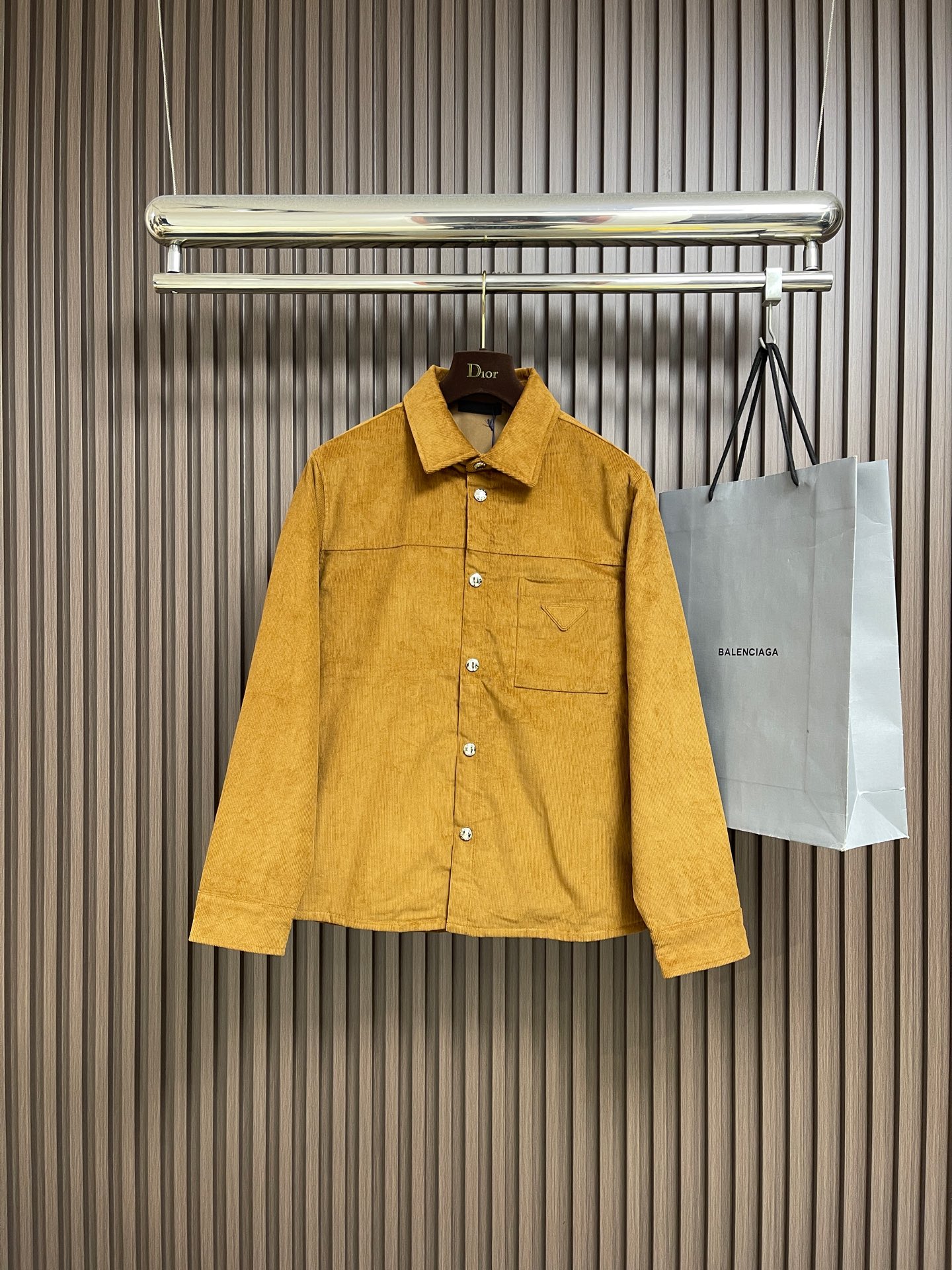 NO:600145,PRADA  The triangle mark corduroy jacket is made of corduroy fabric made of cotton fiber. The fine velvet strips erected on the surface seem to be the delicate texture left by time, with a retro atmosphere. After a special textile process, this rich-textured corduroy is woven. The velvet strips are full and even.  It feels soft and warm, not only has good thermal insulation performance, but also exudes a low-key luxury texture. The chest is decorated with the iconic triangle logo, which becomes the visual focus of the entire piece with a simple and powerful geometric shape. After fine cutting and polishing, the edges are neat and smooth, and the quality is  Full of sense. It is accurately sewn on the left chest, forming a material interaction with the body fabric, which not only highlights the brand identity, but also adds a sense of sophistication to the overall shape. The fitted version design can well modify the body shape, and can be easily created whether it is matched with  Fashionable shape. The front of the body is designed with snap buttons, which makes it easy to put on and take off while also adding a sense of casualness. The snap buttons are of high quality and complement the corduroy fabric. Every detail is done just right. Sizes S-XL, prada, jackets  & coats,alexander wang19860909PRADA 三角标灯芯绒外套,面料采用棉纤维打造的灯芯绒面料,其表面竖起的细密绒条,仿佛是时光留下的细腻纹理,自带复古氛围.经过特殊的纺织工艺,织就出这质感丰盈的灯芯绒.绒条饱满且均匀,触感柔软而温暖,不仅具有良好的保暖性能,还散发着一种低调的奢华质感.胸口饰以标志性的三角徽标,以简约而有力的几何形状,成为整件的视觉焦点.经过精细的裁剪和打磨,边缘整齐光滑,质感十足.它被精准地缝制在左胸位置,与衣身面料形成材质上的互动,既凸显了品牌身份,又为整体造型增添了一份精致感.合身的版型设计,能够很好地修饰身形,无论是搭配还是,都能轻松打造出时尚造型.衣身正面采用按扣开合设计,方便穿脱的同时,也增添了一份随性.按扣的质感上乘,与灯芯绒面料相得益彰,每一个细节都做得恰到好处.尺码S-XL,,prada,jackets & coats,alexander wang,Men's clothing