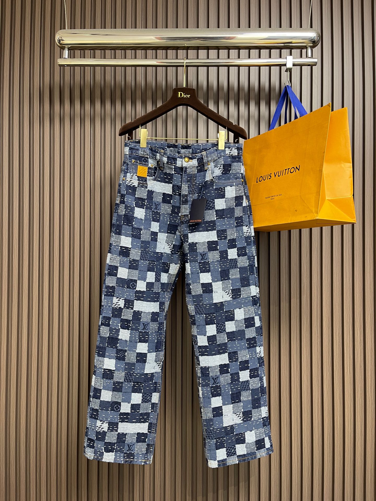 NO:600169,LV  The co-branded jacquard checkerboard jeans are made of pure cotton fabric to create a standard fit. The Damier jacquard weave pattern is presented through exquisite splicing technology, demonstrating Nigo's deep understanding of traditional Japanese craftsmanship. The design cleverly combines workwear and modern aesthetics, with smooth and elegant curved collar lines.  Elegant, perfectly balanced with the overall silhouette. The details are embellished with shiny domed metal buttons and rivets, adding a sense of sophistication to the overall look. The back waist is equipped with an adjustable strap to ensure wearing comfort. Complete with three standards, same style for men and women. Sizes 28-30-32-34-36, Louis  vuitton,jeans,alexander wang19860909LV 联名提花棋盘格牛仔裤,采用纯棉面料打造标准版型,通过精湛的拼接工艺呈现Damier提花织纹图案,展现了Nigo对日本传统工艺的深刻理解.设计上巧妙融合了工装与现代美学,弧形衣领线条流畅优雅,与整体廓形完美平衡.细节处选用亮泽圆顶金属纽扣和铆钉点缀,为整体造型增添精致感.后腰配有可调节袢带,确保穿着舒适度.三标齐全,男女同款.尺码28-30-32-34-36,,louis vuitton,jeans,alexander wang,Men's clothing