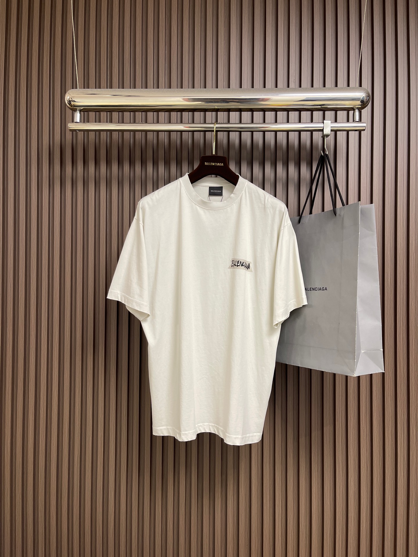 NO:598798,Balenciaga  Offset printed round neck short-sleeved T-shirt, retro plain knitted fabric. The main body is made of 24S plain knitted fabric with a weight of 185g. It is paired with 32S double yarn 1*1 thread and has a weight of 270g. The weight of the fabric ensures the lightness and breathability of the wear. The 24-count yarn gives the fabric a delicate and smooth texture, and the plain knitted structure brings a good skin-friendly feel and moderate elasticity. The fabric has been washed in faded gray, which not only gives  It gives it a unique retro appearance, softens the color, and achieves a pre-softening effect on the touch, eliminating the stiffness of new fabrics, making the garments appear comfortable and soft with the texture of old materials when worn for the first time. Art work printing patterns, dark flower paste dot multi-layer superposition printing is an advanced printing process that combines fine patterns and three-dimensional layers. Its core is to use high-mesh dot plate making to print transparent or light-colored printing paste multiple times with micron-level precision  Overprinted on the fabric base, each overlay is accurately aligned to form a looming dark floral texture. The printed pattern does not rely on bright colors, but creates subtle light and shadow gradients and tactile layering on the surface of the fabric through the thickness difference of slurry accumulation and light refraction. The pattern shows delicate changes at different angles, with both visual depth and long-lasting washability. The high collar, oversize and loose silhouette  Shape design, basic round neckline, dropped shoulder line, vertical pit woven code from top to bottom, collar, cuffs, and hem all have ruffles, and the sleeve length is longer to highlight the details. The thickness of the ready-made garment is the same as the original, and it is also shaped, so the upper body is wide and not easy to deform. Sizes XS-L, balenciaga, versace, T-shirt, tees, t-shirt, alexander  wang19860909Balenciaga 胶印花圆领短袖T恤,复古平纹针织面料,主体采用24S平纹针织面料,克重为185g；搭配32S双纱1*1螺纹,克重为270g.面料克重确保了穿着的轻盈与透气性.24支纱线赋予了面料细腻平整的肌理,平纹针织结构则带来了良好的亲肤感和适度的弹性.面料经过褪色灰色水洗处理,这不仅赋予其独特的复古外观,柔和了色彩,更在触感上实现了预软化的效果,消除了新织物的生硬感,使成衣初次穿着即呈现舒适柔软的旧物质感.艺术作品印花图案,暗花浆网点多层叠加印花是一种融合精细图案与立体层次的先进印花工艺.其核心在于通过高目数网点制版,将透明或浅色印花浆料以微米级精度多次套印于面料基底,每次叠加均精准对位,形成若隐若现的暗花纹理.印花图案不依赖鲜艳色彩,而是通过浆料堆积的厚薄差异和光线折射,在织物表面营造出微妙的光影渐变与触觉层次感.图案在不同角度下显现细腻变化,兼具视觉深度与持久耐洗性.高领oversize宽松版型,oversize宽松廓形设计,基础款圆领领口落肩线,自上而下采用纵向坑条织码,领口、袖口、下摆均有罗口收口,袖长更偏长突出细节感.成衣厚度与原版一致,另做定型处理,上身挺阔不易变形.尺码XS-L,,balenciaga,versace,T-shirt,tees，t-shirt,alexander wang,Men's clothing