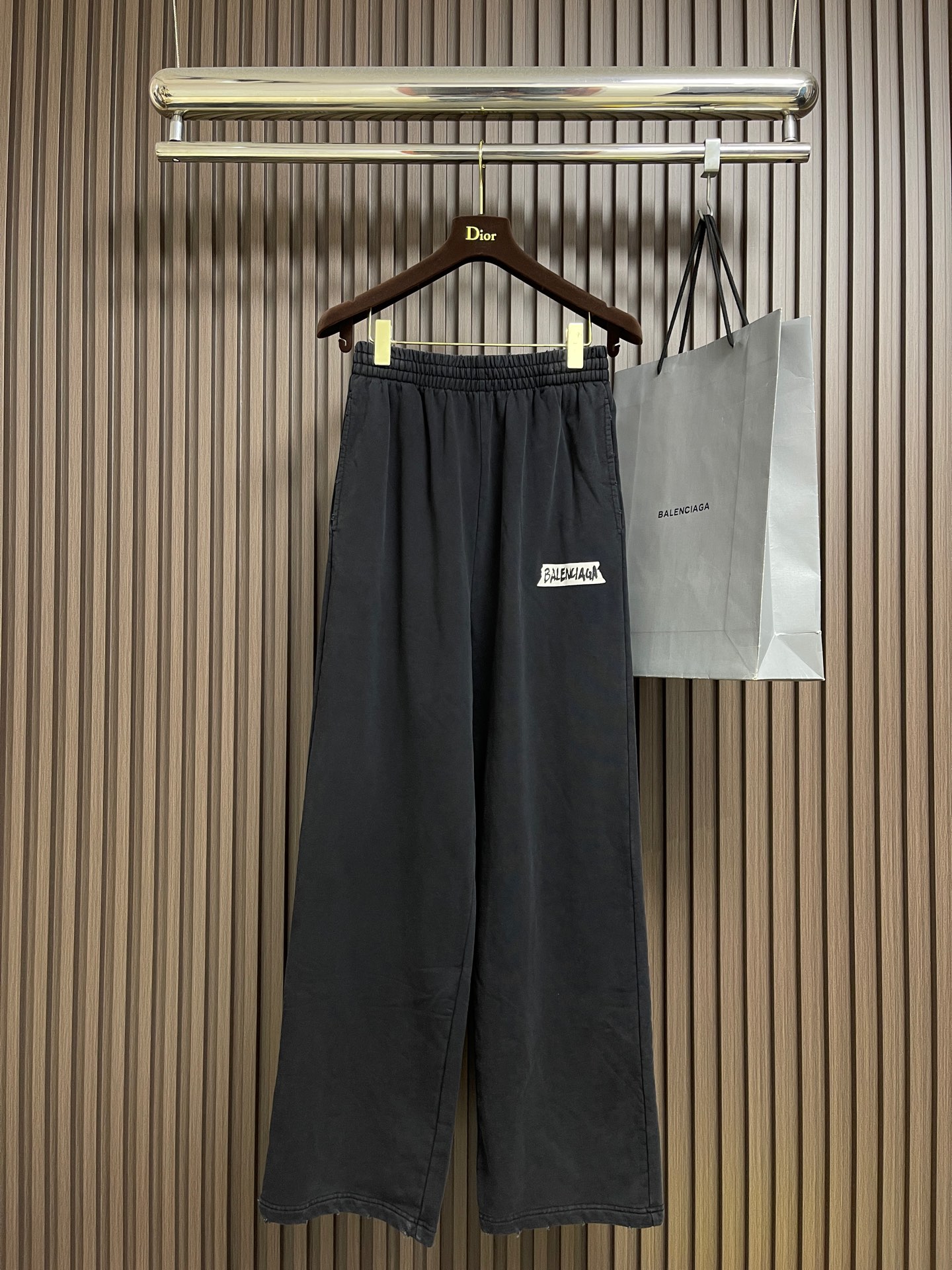 NO:601191,Balenciaga  White rubber bottom printed straight sweatpants, fish scale bottom professional stir-fried fabric, decorated with Paris logo printing works, straight sports version, complete set of accessories, the fabric is made of 26S double yarn + 10S fish scale bottom brushed fabric, 380g. The pure cotton fish scale bottom fabric is a knitted fabric with special texture and excellent performance. The pure cotton material ensures the softness and breathability of the fabric.  and hygroscopicity; the fish scale bottom structure increases the elasticity and wrinkle resistance of the fabric. Multi-layer superposition printing of dark floral dots is an advanced printing process that combines fine patterns and three-dimensional levels. Its core is to use high-mesh dot plate making to overprint transparent or light-colored printing paste on the fabric base multiple times with micron-level precision. Each overlay is accurately aligned, forming a faintly visible pattern.  Dark flower texture. The printed pattern does not rely on bright colors, but creates subtle light and shadow gradients and tactile layering on the surface of the fabric through the thickness difference of slurry accumulation and light refraction. The pattern shows delicate changes at different angles, with both visual depth and long-lasting washability. The irregular whole-body hole design gives simple garments a rebellious and destructive design.  The stone grinding and washing process locates the holes, and the ready-to-wear products use a stone grinding machine to laser position and manually destroy the wear effect. Every frayed area is purely handmade, so that the natural wear and tear of the fabric achieves the most harmonious visual effect. After stone grinding and washing, it can show a rich retro texture. Sizes XS-L, balenciaga, alexander  wang19860909Balenciaga 白胶底印花直筒卫裤,鱼鳞底专业炒色面料、饰以巴黎标识印花作品、直筒运动版型、全套辅料配备,面料采用26S双纱＋10S鱼鳞底磨毛面料,380g.纯棉质鱼鳞底面料具有特殊纹理和优良性能的针织面料,纯棉材质保证了面料的柔软性、透气性和吸湿性；鱼鳞底结构增加了面料的弹性和抗皱性.暗花浆网点多层叠加印花是一种融合精细图案与立体层次的先进印花工艺.其核心在于通过高目数网点制版,将透明或浅色印花浆料以微米级精度多次套印于面料基底,每次叠加均精准对位,形成若隐若现的暗花纹理.印花图案不依赖鲜艳色彩,而是通过浆料堆积的厚薄差异和光线折射,在织物表面营造出微妙的光影渐变与触觉层次感.图案在不同角度下显现细腻变化,兼具视觉深度与持久耐洗性.不规则的全身开洞设计,让简单成衣带有叛逆的破坏设计感.石磨洗水工艺定位破洞处理,成衣制品采用石磨机激光定位手工破坏磨损效果.每一处磨损处纯手工打造,使面料的自然磨损达到最和谐的视觉效果,通过石磨洗水后能够呈现出浓郁的复古质感.尺码XS-L,,balenciaga,alexander wang,Men's clothing