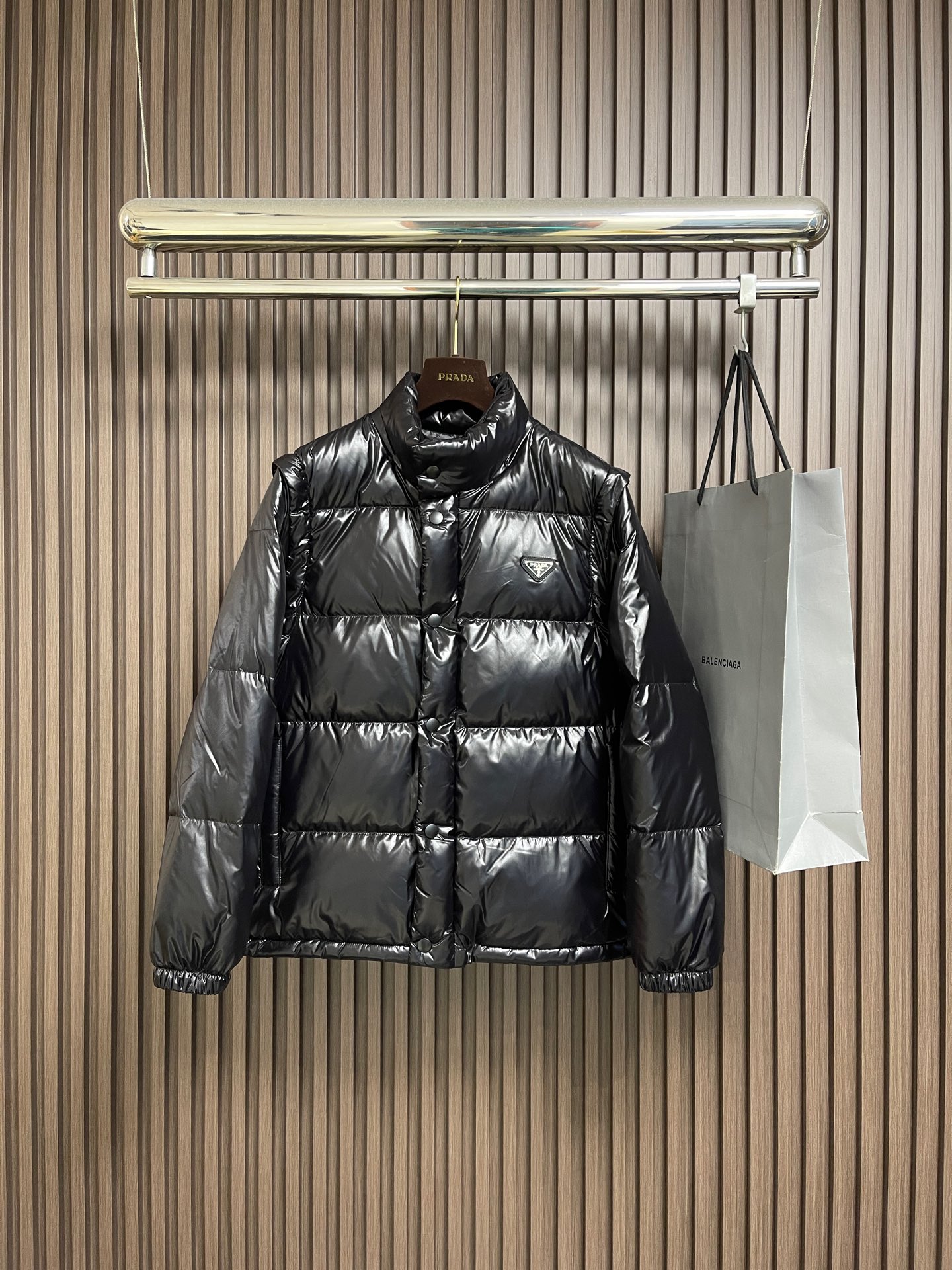 NO:645040,Prada  2025FW new autumn and winter removable sleeve glossy down jacket. It is made of glossy matte black fabric, with a low-key luster - it has a cold and high-end metallic texture under the light, and a delicate suede texture is hidden under daily light, giving it a 'flow' when walking.  'Moving exquisitely', bid farewell to the heavy boring feeling in winter. The interior is filled with 90% white goose down. The high collar + long sleeve design is temperature-locking and windproof, suitable for severe cold weather below -5℃; remove the sleeves and instantly transform into a stand-up collar, suitable for the cool season around 10℃, from  Wear it from early winter to early spring, covering your entire autumn and winter look. The iconic triangle logo embellishes the left chest, and the metallic texture echoes the shiny fabric, low-key highlighting the recognition of the luxury brand; customized brand logo metal zippers + buttons, and every hardware is engraved with the brand logo  , sophistication in the details; the drawstring design at the hem allows you to adjust the silhouette freely, switching between loose or slim with one click, adapting to different body shapes and styles. One piece, two forms, covering your 'temperature and style' throughout autumn and winter. Sizes M-XXL  Size M, bust 116, length 70, shoulder width 46.4, size L, bust 120, length 72, shoulder width 48, XL size, bust 124, length 74, shoulder width 49.6, size 219860909Prada 2025FW秋冬新品可拆卸袖亮面羽绒服外套.选用亮面哑光黑面料,自带低调光泽感﹣﹣灯光下是冷冽高级的金属质感,日常光线下又藏着细腻的绒面肌理,行走间自带「流动的精致」,告别冬日厚重的沉闷感.内里90白鹅绒填充.高领＋长袖设计,锁温防风,适配﹣5℃以下的严寒天气；卸下袖子秒变立领,内搭,适配10℃左右的微凉季节,从初冬穿到早春,承包你一整个秋冬的造型.标志性三角徽标点缀左胸,金属质感与亮面面料呼应,低调彰显奢牌辨识度；定制品牌标识金属拉链＋纽扣,每一处五金都刻有品牌标识,细节里的精致主义；下摆抽绳设计,可自由调节廓形,宽松or修身一键切换,适配不同身形与穿搭风格.一件,两种形态,承包你整个秋冬的「温度与风度」.尺码M-XXL M码胸围116衣长70 肩宽46.4 L码 胸围120衣长72 肩宽48 XL码 胸围124衣长74 肩宽49.6 2XL码胸围128衣长76 肩宽51.2,,prada,jackets & coats,down jacket,alexander wang,Men's clothing