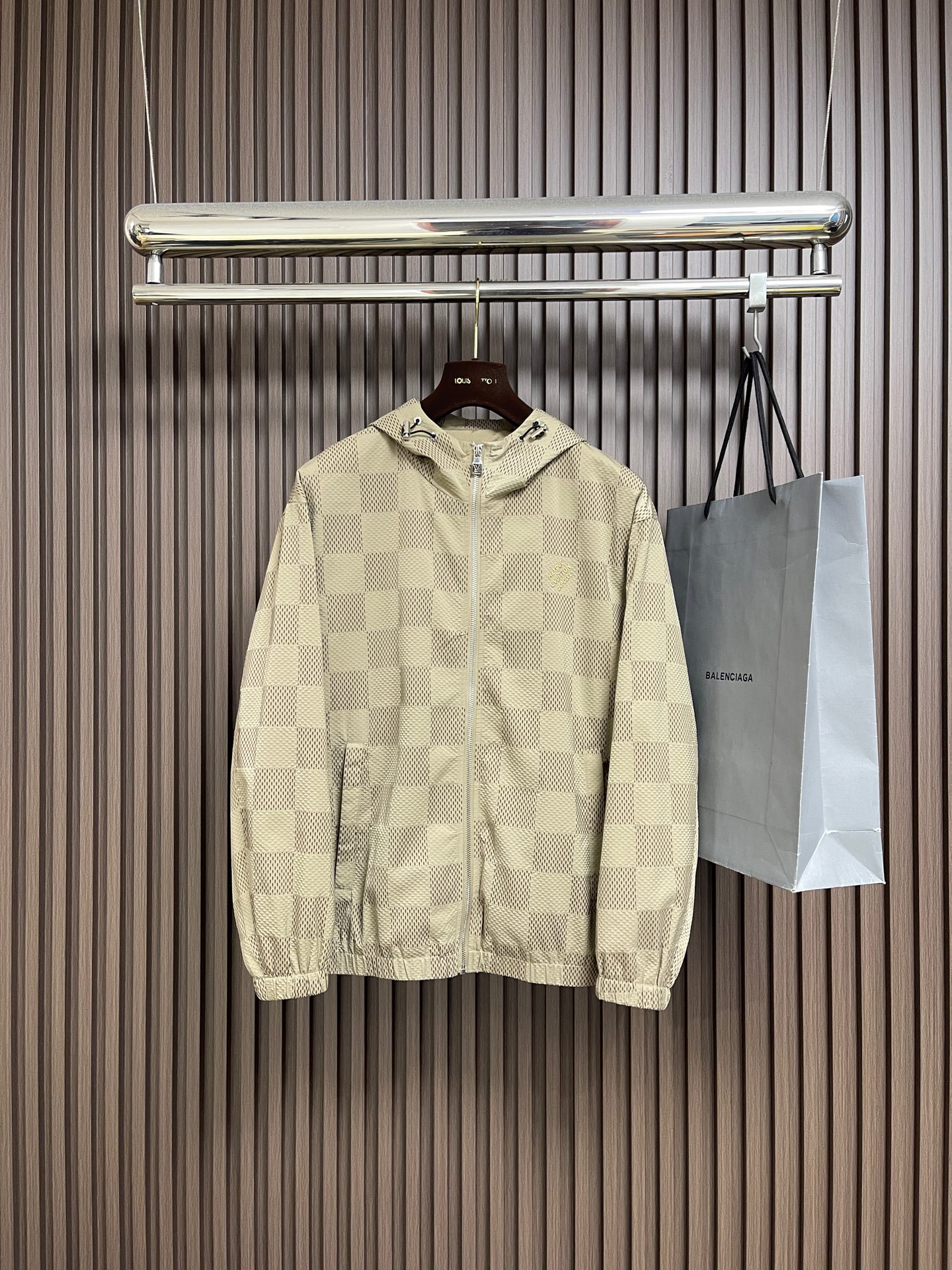 NO:627525,LV  The new 2025ss autumn and winter checkerboard jacquard hooded zipper jacket uses the classic khaki plaid pattern to create a modern look that combines casual and urban styles. It adopts a hooded design and is decorated with exquisite metal fasteners, adding practicality and detail highlights. The main body of the body is made of polyester fiber technical fabric, ensuring excellent stiffness and windproof performance. The front zipper opens and closes smoothly, and the gold LV logo is embroidered on the left chest.  It is low-key and eye-catching to highlight the brand identity. The closing design of the cuffs and hem not only provides better thermal insulation effect, but also makes the silhouette more streamlined. The overall design perfectly combines outdoor functionality with Louis Vuitton's unique luxury fashion atmosphere. Whether it is daily travel or urban exploration, it can easily enhance the texture and taste of the body. It is an ideal fashion item to cope with the changing autumn and winter climate. Sizes 48-56, Louis Vuitton  vuitton,louis vuitton,jackets & coats,hats,alexander wang19860909LV 2025ss秋冬新品棋盘格提花连帽拉链外套,以经典的卡其色格纹图案打造出兼具休闲与都市风格的现代造型.它采用连帽设计,并饰有精致的金属扣件,增添实用性与细节亮点.衣身主体选用聚酯纤维科技面料,确保了出色的挺括感与防风性能.正面拉链开合顺滑利落,左侧胸前的金色LV标志刺绣低调而醒目地彰显品牌身份.袖口与下摆的收口设计不仅提供了更好的保暖效果,也令版型更显利落.整体设计完美融合了户外机能感与路易威登独有的奢华时尚气息,无论是日常出行还是都市探索,都能轻松提升体穿搭的质感与品味,是应对多变秋冬气候的理想时尚单品.尺码48-56,,louis vuitton,louis vuitton,jackets & coats,hats,alexander wang,Men's clothing