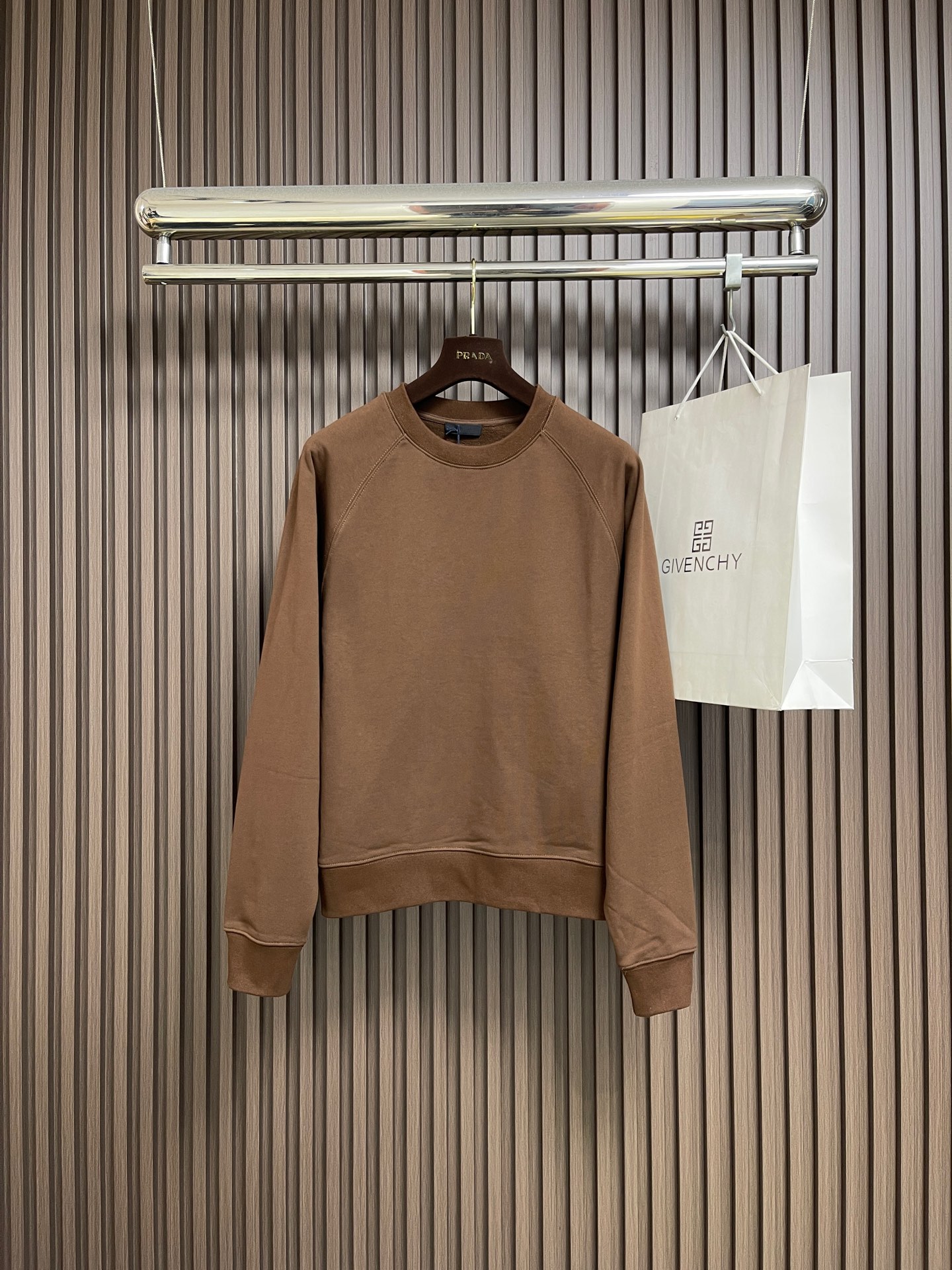 NO:627574,Prada  Woolen triangular logo round neck sweatshirt, looped cotton fabric and knitted fabric, using 26S double yarn + 10S reverse terry base yarn, 380g; paired with 21S double yarn rib, 470g. The double-sided basic structure has better bottom locking ability, and is paired with spandex yarn to tightly lock the fabric surface. Even with a thick fleece effect, the shedding is still less than that of ordinary sweatshirt fleece fabrics. The texture is clear  Clear and delicate, the cloth surface is clean and smooth; the cloth surface can quickly return to flatness after stretching, and is wide and easy to shape. The woolen triangle logo is embellished, and the inverted triangle logo is woven from 5S pure cotton wool. It is processed through multi-layer structure, handcrafting and other processes. The material and process requirements are high, ensuring clean lines without burrs, moderate thickness and elasticity, enhancing the three-dimensional sense and durable function. The logo is passed through multiple layers  The composite process achieves a three-dimensional embossed effect, and the back is reinforced to prevent deformation. High-precision machinery is then used to embroider the logo on the surface of the fabric. This process can achieve a delicate presentation of complex patterns and form an embossed effect. The standard version of the classic round neck, the collar, cuffs and hem are all ribbed; the excellent lateral elasticity of the rib tissue is used to not only ensure that key parts of the body are firm  It is not easily deformed, durable and washable, and can be naturally tightened to outline neat contour lines. Its functionality and decorative properties not only prevent the intrusion of cold wind, improve the warmth retention efficiency, but also add a sense of rhythm in details to the overall simple design, making the version more crisp. Sizes XS-L, prada, hoodie, sweatshirts, alexander  wang19860909Prada 毛织三角标识圆领卫衣,回圈棉质面料搭配针织面料,采用26S双纱＋10S反向毛圈底纱,380g；搭配21S双纱罗纹,470g.双面基础结构拥有更出色的锁底能力,搭配使用氨纶丝紧锁布面,即使做厚抓绒效果掉毛情况仍然比普通的卫衣抓绒面料减少.纹路清晰细腻,布面干净爽滑；拉伸后布面也可迅速恢复平整,挺阔易塑形.毛织三角徽标点缀,采用5S纯棉质毛料织编倒三角形徽标,通过多层结构、手工手边等多工艺处理.材质和工艺要求高,确保线条利落无毛边,厚度适中且富有弹性,增强立体感和耐用功能.徽标通过多层复合工艺,实现立体凸印效果,背面加固处理防止变形.再使用高精度机械将徽标绣制在织物表面,这种工艺能实现复杂图案的细腻呈现,形成浮雕效果.经典圆领标准版型,领口、袖口及下摆全部采用罗纹收口；利用罗纹组织优异的横向弹性,不仅确保了衣身关键部位牢固不易变形、耐穿耐洗,同时能自然收紧,勾勒出利落的轮廓线条.其功能性与装饰性并存既防止冷风灌入,提升保暖效率,又为整体简约设计增添了细节上的节奏感,使版型更挺括.尺码XS-L,,prada,hoodie,sweatshirts,alexander wang,Men's clothing