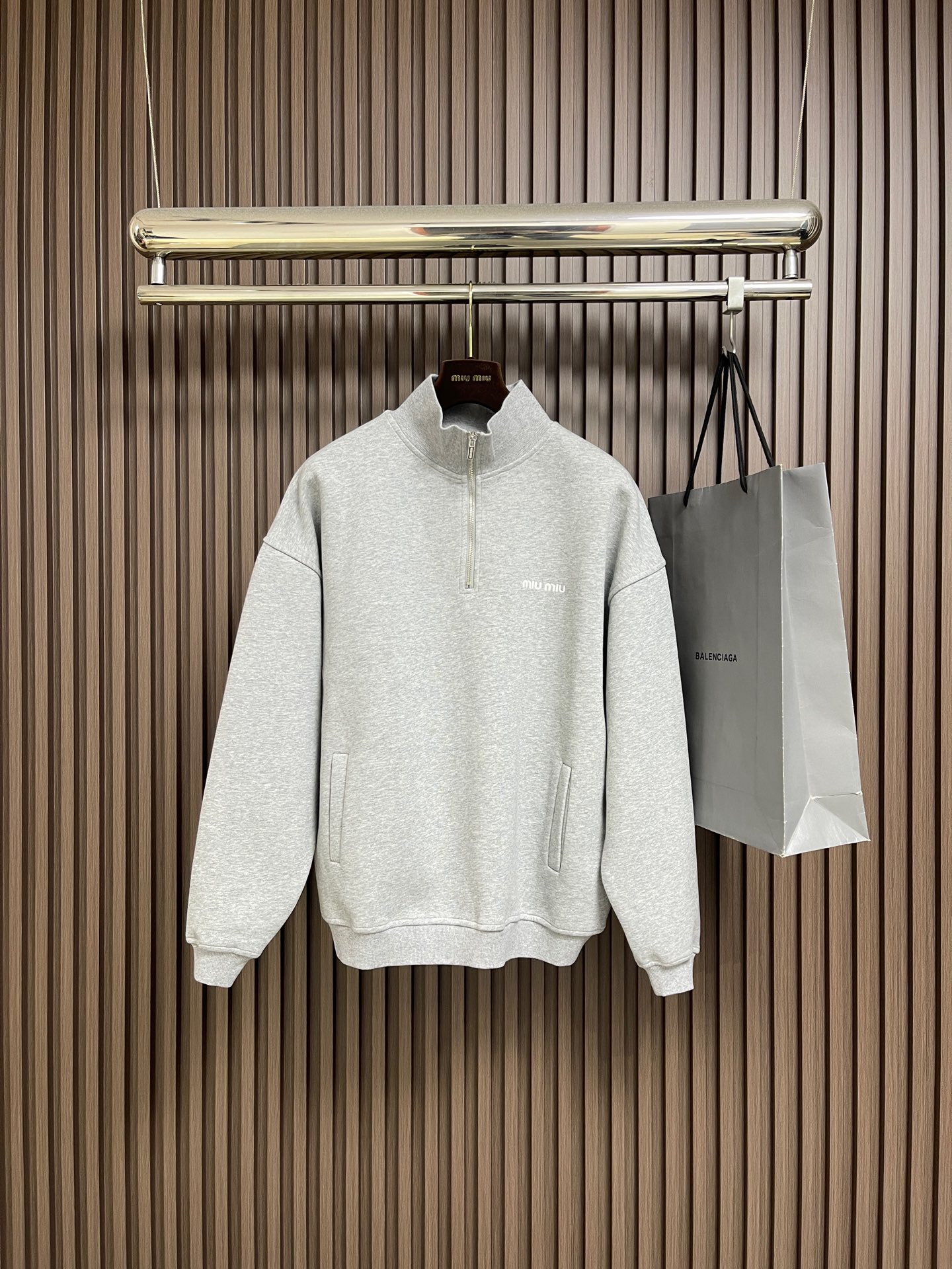 NO:683061,MiuMiu half-zip turtleneck sweatshirt, pure cotton fish scale fleece base fabric, embroidered logo embellishment, oversize version, long sleeves with rib knitted cuffs, stand-up collar with front zipper closure, elastic hem, full set of accessories, the fabric is made of 16S single yarn + 7S single yarn, 470g; matched with 21S  2*2 stretch rib; 380g. The surface layer uses 10S single yarn to ensure the surface texture, and the bottom layer uses 16S double-stranded yarn to increase strength. The surface single yarn is thicker, providing better strength and wear resistance, and is suitable as a support structure for the surface layer. The double-stranded yarn is stronger and resists pilling.  It is often used on the bottom layer to enhance the durability of the fabric. The stitching technique is mainly used to fill in the slender and curved lines of the shape, which can show the details and layering of the pattern. The slender and curved lines have a strong sense of line and three-dimensionality, and the stitching method is vivid, lively and covering.  Good. The pattern is embroidered stitch by stitch with embroidery thread, and the pattern is tight and has a shrinking effect. After three-dimensional tailoring, the body of the garment fits the curves of the human body better when worn, and is neither too tight nor loose. Double-needle threading is used for splicing to ensure the firmness and stability of the neckline.  Comfort. The collar zipper opens and closes to adjust the height of the shape; the cuffs and hem are also designed with elastic adjustment to form a unified overall aesthetic. Sizes S-XL, Miumiu, versace, hoodie, sweatshirts,19860909MiuMiu半拉链高领卫衣,纯棉鱼鳞抓绒底面料、刺绣徽标点缀、Oversize版型、长袖搭配罗纹针织袖口、立领正面拉链开合、弹力底边、全套辅料配备,面料采用16S单纱＋7S单股,470g；搭配21S 2*2拉架罗纹；380g.面层用10S单纱保证表面质感,底层用16S支双股线提升强度.表面单纱较粗,提供较好的强度和耐磨性,适合作为面层的支撑结构.双股线更结实、抗起球,常用于底层以增强面料耐用性.挨针的技法主要用于来填绣形状细长而弯曲的线条,可以表现出图案的细节和层次感.细长而弯曲的线条,挨针的线条感和立体感都很强,针法生动、活泼、覆盖性好.逐针挨着将图案用绣花线绣完,花纹紧实有收缩效果.经过立体剪裁,使得衣身在穿着时更加贴合人体曲线,既不会过于紧绷也不会显得松垮.采用双针车线螺纹拼接,确保领口的牢固度和舒适度.领口拉链开合调解造型高度；袖口和下摆同样采用弹力可调节设计,形成统一的整体美感.尺码S-XL,,miumiu,versace,hoodie,sweatshirts,,Men's clothing