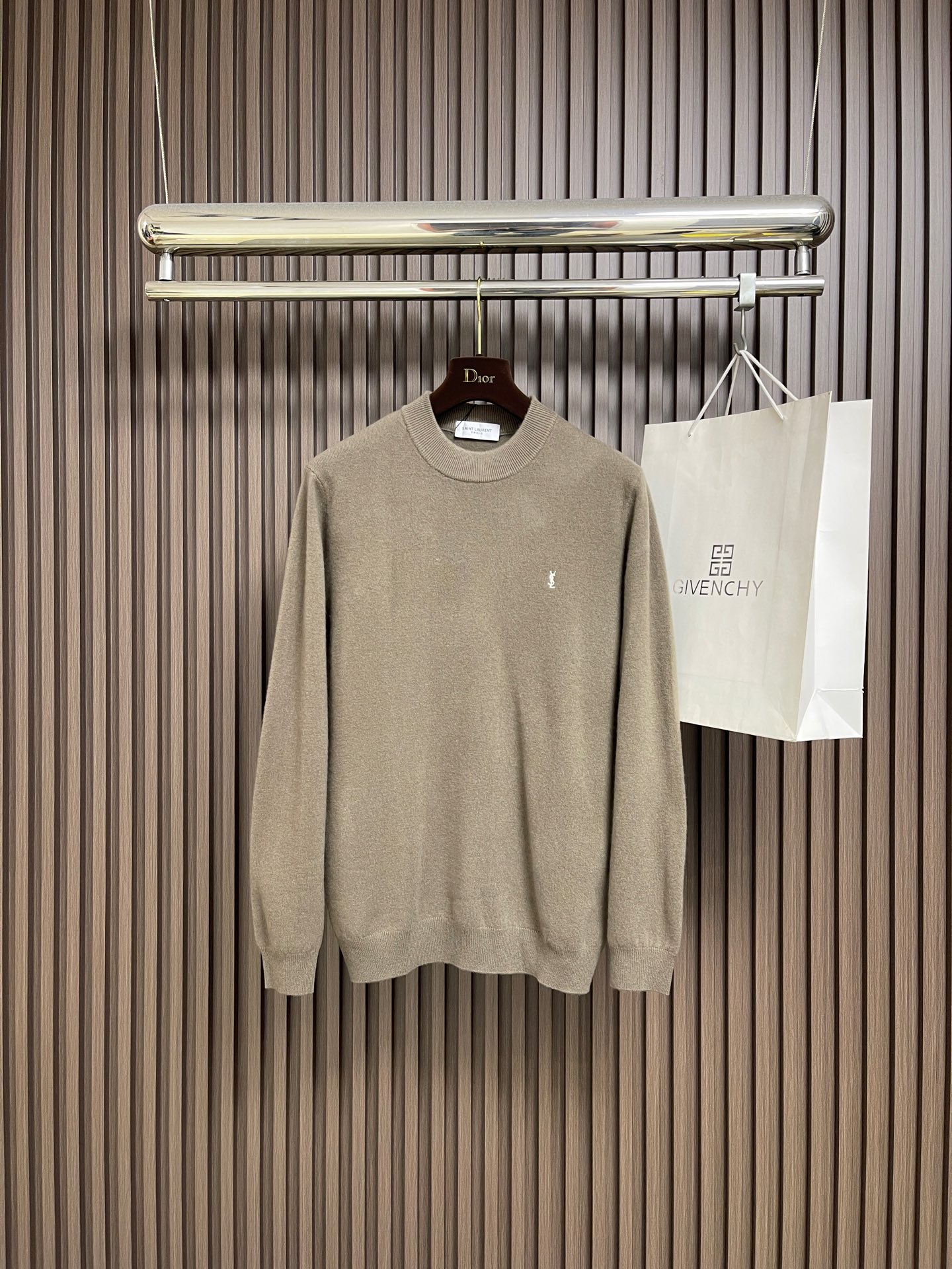 NO:660952,YSL Wa Qing 100% Wool Couple’s Knitted Sweater. When YSL’s classic tile Qing gray meets 100% wool, this sweater brings out the “accent” of autumn and winter -  Different from the dullness of ordinary grays, YSL's special tile green gray has its own 'retro filter'. It has a matte velvet feel under the sun, and there is a hint of 'coldness' hidden in the cold tone. The white YSL logo embroidery on the chest, the stitching is delicate and not rough, is not an exaggerated logo, but 'people who understand will naturally understand the delicacy. The delicate velvet feel of sheep wool, it feels like a layer of 'warm clouds' wrapped around the skin when worn.  ', the weight of g just supports the 'lazy but not slumped' version, but it doesn't feel heavy at all. The drape naturally extends from the shoulder line to the hem. The ribbing on the neckline, cuffs, and hem is tight and not loose, and every stitch hides YSL's 'fine workmanship.' The flat stitching at the shoulder line ensures a natural drape when worn, without bulging or deformation. Sizes XS-XL  XS, shoulder width 42, bust 98, length 67, shoulder width 43, bust 102, length 69, size M, shoulder width 44, bust 106, length 71, size L, shoulder width 45, bust 110, length 73, size XL, shoulder width 46, bust 114, length 75, saint laurent, sweaters,  19860909YSL 瓦青全羊毛情侣款针织毛衣,当YSL的经典瓦青灰撞上全羊毛,这件毛衣,把秋冬的「腔调感」拉满﹣- 区别于普通灰色系的沉闷,YSL特调瓦青灰自带「复古滤镜」,阳光下泛着哑光绒感,冷调里藏着一丝「清冷感」.胸前白色YSL标识刺绣,针脚细腻不粗糙,不是浮夸的logo,而是「懂的人自然懂的精致.绵羊毛的细腻绒感,贴肤穿像裹了层「暖云」,g的克重刚好撑起「慵懒不垮」的版型,却丝毫没有厚重感.垂坠感从肩线自然延伸到衣摆.领口、袖口、下摆的罗纹收口紧密不松垮,每一针都藏着YSL的「精工细作」.肩线处的平整车线,保证穿着时的自然垂坠感,不会鼓包或变形.尺码XS-XL XS码肩宽42 胸围98 衣长67  S码肩宽43 胸围102衣长69  M码 肩宽44 胸围106衣长71 L码 肩宽45 胸围110衣长73 XL码 肩宽46 胸围114衣长75,,saint laurent,sweaters, ,Men's clothing
