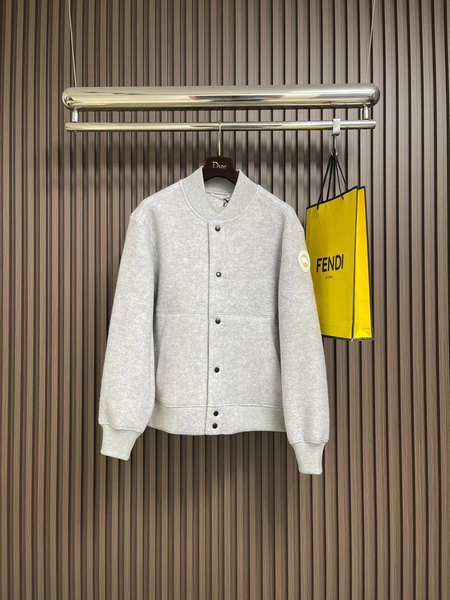 NO:681682,Canada Goose  Fleece emblem button jacket, the main fabric of this jacket is light gray wool blend fabric to improve the fabric's wear resistance, wrinkle resistance and warmth. Wool provides good thermal insulation properties and natural feel, while the blended fibers enhance the practicality and durability of the fabric. The cutting process needs to ensure that the texture and color of the fabric are evenly distributed, especially for this light gray tone, color difference needs to be avoided. When cutting pieces  It is necessary to consider the stretchability of wool blended fabrics to ensure that the size of the garment is stable. Use sewing needles and threads suitable for wool blended fabrics to avoid damage to the fabric during the sewing process. The sewing stitches are even and firm to prevent thread detachment. The temperature needs to be controlled during ironing to avoid damage to the fabric caused by high temperatures, while maintaining the fabric's smoothness and stiffness. The front and rear body parts, sleeves and other main parts are spliced with flat seams to ensure a smooth pattern.  The splicing is aligned with the fabric texture to keep the appearance neat. The white round armband on the left arm is an important part of the brand logo and is finely sewn to ensure it is firm and flat. Sizes S-XL,,jackets & coats,jackets & coats,19860909Canada Goose 抓绒饰章纽扣版外套,这款夹克的主要面料为浅灰色羊毛混纺布料,以提升面料的耐磨性、抗皱性和保暖性.羊毛提供了良好的保暖性能和自然的手感,而混纺纤维则增强了面料的实用性和耐久性.裁剪过程需确保面料的纹理和颜色均匀分布,特别是对于这种浅灰色调,需避免色差.裁片时需考虑羊毛混纺面料的伸缩性,确保成衣尺寸稳定.使用适合羊毛混纺面料的缝纫针和线,避免面料在缝制过程中受损.缝制线迹均匀、牢固,防止脱线.整烫时需控制温度,避免高温对面料造成损伤,同时保持面料的平整和挺括.前后衣片、袖子等主体部分采用平缝拼接,确保版型流畅. 拼接处对齐面料纹理,保持外观整洁.左臂上的白色圆形臂章是品牌标识的重要部分,精细缝制,确保牢固且平整.尺码S-XL,,jackets & coats,jackets & coats,,Men's clothing