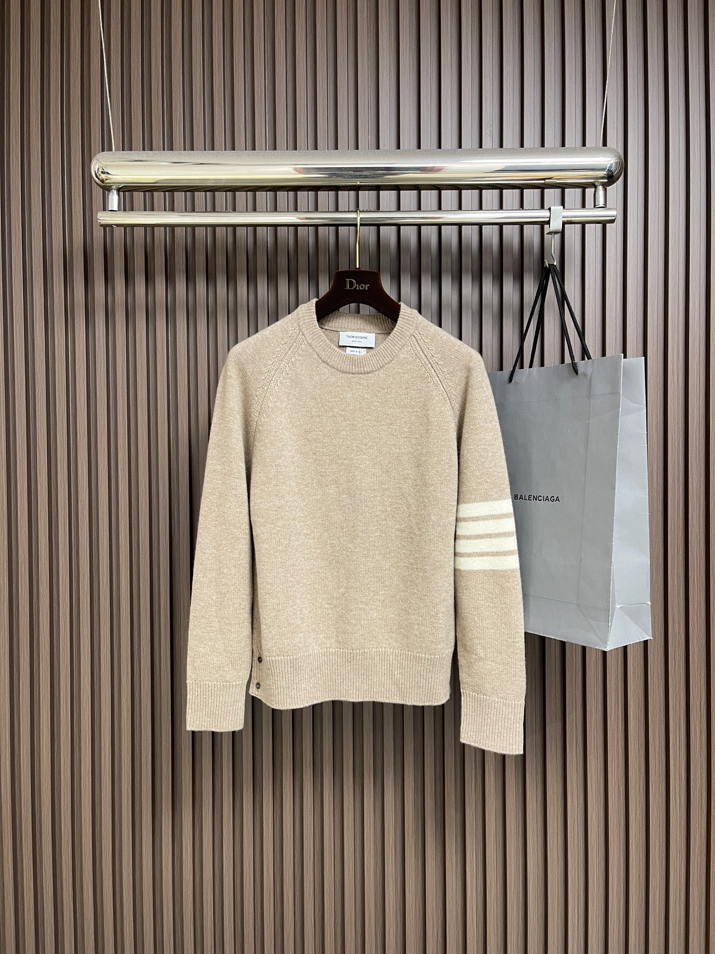 NO:690662,TB THOM BROWNE classic four-stripe round neck long-sleeved sweater, this Thom  Browne knitted sweater is made of fine cashmere blend fabric and is made by precision flat knitting process. It feels soft and skin-friendly and has good drape. The neckline is a classic round neck design, with ribbed edges of the same material, which elastically fits the neck; the shoulder sleeves use diagonal stitching raglan sleeve technology, which improves the comfort of shoulder movement while optimizing the silhouette. The left arm is decorated with the iconic four white stripes, and the stripes are intarsia.  The craftsmanship is woven into the body, the color is uniform and not easy to fall off; the hem and cuffs are ribbed with the same fabric to maintain a unified overall style. The overall style is loose and casual, the stitching of the body is fine and even, and the edges are seamed and reinforced, taking into account both texture and durability. It is a basic item that combines simplicity and brand recognition for daily wear. The overall routing is straight and delicate, the fabric is comfortable and soft, and the color is consistent without color difference.  It can be matched with the same style to create a fashionable look, and can be used in various occasions. Customized accessories, complete with three standards, same style for men and women!  Sizes 1-2-3-4,,sweaters,19860909TB THOM BROWNE经典四条杠圆领长袖毛衣,这件Thom Browne针织毛衣采用细腻羊绒混纺面料,经精密平针编织工艺制成,触感柔软亲肤且垂坠感佳.领口为经典圆领设计,搭配同材质罗纹收边,弹性贴合颈部；肩袖处采用斜向车线的插肩袖工艺,提升肩部活动舒适度的同时优化版型线条.左臂装饰标志性四道白条纹,条纹通过嵌花工艺织入衣身,色彩均匀且不易脱落；下摆及袖口均为同面料罗纹收口,保持整体风格统一.整体版型为宽松休闲款,衣身针脚细密均匀,边缘处经锁边加固处理,兼顾质感与耐穿性,是日常穿搭中兼具简约与品牌辨识度的基础单品.整体走线平直细腻,面料舒适柔软,颜色一致无色差 能与同款搭配营造时尚造型,驾驭各种场合,定制辅料,三标齐全,男女同款！尺码1-2-3-4,,sweaters,,Men's clothing