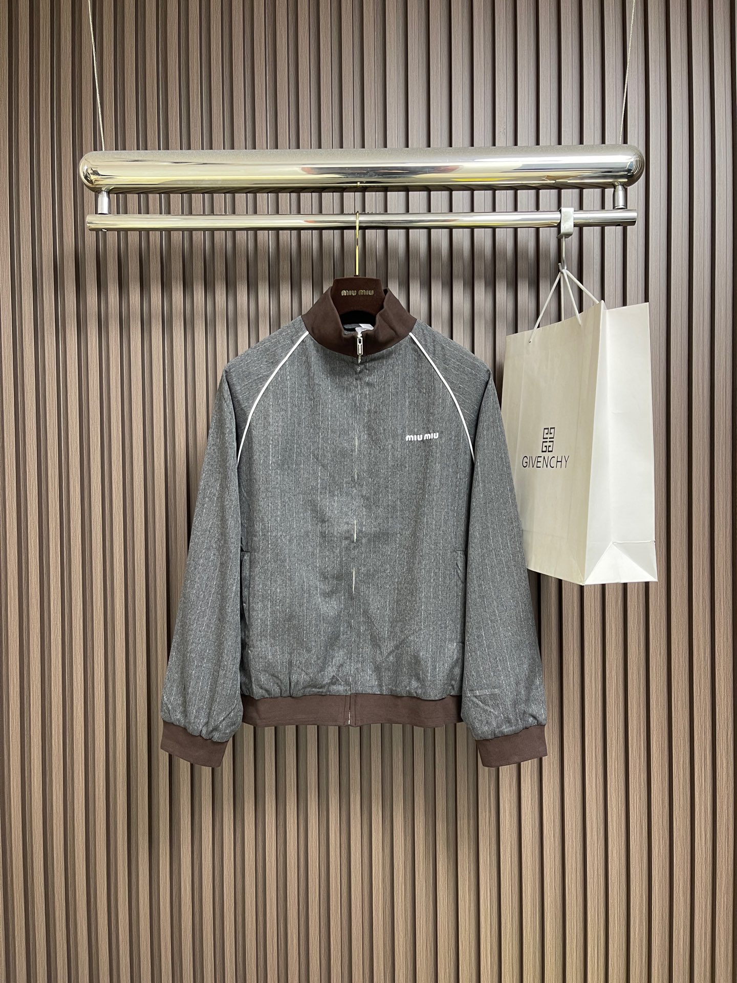 NO:703465,MIUMIU  Stand-up collar pinstripe zipper jacket. This gray pinstripe jacket is made of combed wool blend fabric, which has been treated with high temperature setting and has good wrinkle resistance and drape. Stand-up collar design, the collar and cuffs are spliced with brown elastic ribs to enhance warmth and fit. The placket adopts a metal zipper, which is smooth and easy to pull. The shoulders and armholes are three-dimensionally cut, and the armpits are darted to improve the comfort of movement. There are two darts on the front and rear panels.  Enhance the three-dimensional sense. The cuffs are elasticated for easy adjustment. There is brand logo embroidery on the left chest to highlight the brand texture. All seams are three-thread overlocked to increase durability. The steam setting process is used for ironing to ensure a crisp shape and smooth lines. The ready-made garments have been inspected three times to ensure that there are no flaws and no excess threads, and meet the standards of high-end ready-made garments. The overall wiring is straight and delicate, the fabric is comfortable and soft, and the colors are consistent and without color difference.  It can be matched with the same style to create a fashionable look, and can be used in various occasions. Customized accessories, complete with three standards, same style for men and women!  Size 38-40-42-44,,miumiu,jackets & coats,jackets & coats,19860909MIUMIU 立领细条纹拉链夹克外套,这款灰色细条纹夹克采用精梳羊毛混纺面料,经高温定型处理,具有良好的抗皱性与悬垂感.立领设计,领口与袖口采用棕色弹力罗纹拼接,增强保暖性与贴合度.门襟采用金属拉链,顺滑易拉.肩部与袖笼处采用立体剪裁,腋下收省处理,提升活动舒适度.前后片各设两个省道,增强立体感.袖口采用松紧设计,便于调节.左胸处设有品牌标识刺绣,彰显品牌质感.所有接缝处均进行三线包缝处理,增加耐用性.整烫采用蒸汽定型工艺,确保版型挺括、线条流畅.成衣经过三次质检,保证无瑕疵、无多余线头,达到高级成衣标准.整体走线平直细腻,面料舒适柔软,颜色一致无色差 能与同款搭配营造时尚造型,驾驭各种场合,定制辅料,三标齐全,男女同款！尺码38-40-42-44,,miumiu,jackets & coats,jackets & coats,,Men's clothing