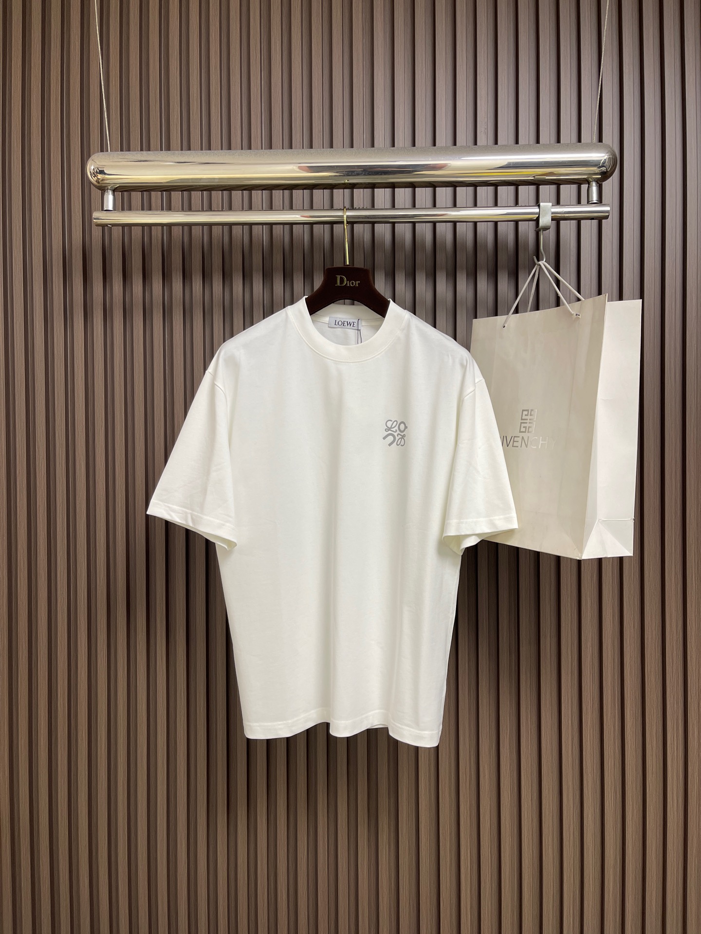 NO:726813,Support after-sales service Loewe x on  The casual short-sleeved T-shirt with letters embossed on the chest has become a must-have item in the summer wardrobe with its simple yet stylish design. This short-sleeved shirt is made of high-quality fabric, which is soft, comfortable and breathable, keeping the skin dry and comfortable even in the hot summer. Its shape is loose yet crisp, which can well modify the body shape. It can be easily worn whether it is paired with jeans or casual pants, showing a casual yet stylish casual style. The unique letter embossed design on the chest adds to the overall look.  This short sleeve adds a bit of personality and fashion. These letters may be simple and elegant, or full of fun. You can choose according to personal preferences to show your unique self-style. Whether it is daily travel, friends' gatherings or outdoor leisure, this casual short sleeve with letters on the chest can be your perfect match, allowing you to stand out from the crowd and enjoy the relaxation and comfort of summer. In short, with its unique charm, it has become an indispensable fashion element in summer. Sizes M-XXL  M size bust 110 shoulder width 51.5 length 71 L size bust 114 shoulder width 52.5 length 7319860909支持年后售后 Loewe x on 胸前压印字母休闲短袖T恤,以其简约而不失时尚的设计,成为了夏日衣橱中的必备单品.这款短袖采用优质面料,柔软舒适,透气性好,即使在炎炎夏日也能保持肌肤的干爽与自在.其版型宽松而不失挺括,能够很好地修饰身形,无论是搭配牛仔裤还是休闲裤,都能轻松驾驭,展现出随性而不失格调的休闲风范.胸前独特的字母压印设计,为整件短袖增添了几分个性与时尚感.这些字母或简约大方,或趣味十足,能够根据个人喜好进行选择,彰显独特的自我风格.无论是日常出行、朋友聚会还是户外休闲,这款胸前压字母的休闲短袖都能成为你的完美搭配,让你在人群中脱颖而出,尽享夏日的轻松与惬意.总之,它以其独特的魅力,成为了夏日里不可或缺的时尚元素.尺码M-XXL  M码 胸围110 肩宽51.5 衣长71 L码 胸围114 肩宽52.5 衣长73  XL码 胸围118 肩宽53.5 衣长75 XXL码 胸围122 肩宽54.5 衣长76,,loewe,jeans,T-shirt,tees，t-shirt,,Men's clothing