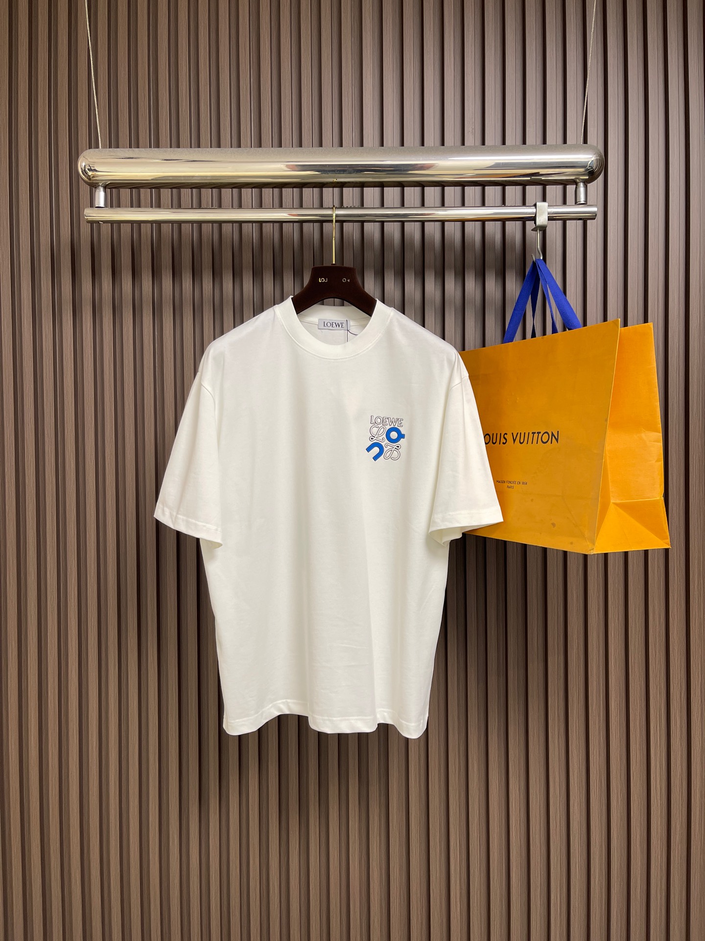 NO:726797,Support after-sales service Loewe x on  The casual short-sleeved T-shirt with offset printed letters on the chest has become a must-have item in the summer wardrobe with its simple yet stylish design. This short-sleeved T-shirt is made of high-quality fabric, which is soft, comfortable and breathable. It can keep the skin dry and free even in the hot summer. Its shape is loose yet crisp, which can well modify the body shape. It can be easily worn whether it is paired with jeans or casual pants, showing a casual yet stylish casual style. The unique offset letter design on the chest adds to the overall look.  This short sleeve adds a bit of personality and fashion. These letters may be simple and elegant, or full of fun. You can choose according to personal preferences to show your unique self-style. Whether it is daily travel, friends' gatherings or outdoor leisure, this casual short sleeve with offset letters on the chest can be your perfect match, allowing you to stand out from the crowd and enjoy the relaxation and comfort of summer. In short, with its unique charm, it has become an indispensable fashion element in summer. Sizes M-XXL  M size bust 110 shoulder width 51.5 length 71 L size bust 114 shoulder width 52.5 length 7319860909支持年后售后 Loewe x on 胸前胶印字母休闲短袖T恤,以其简约而不失时尚的设计,成为了夏日衣橱中的必备单品.这款短袖采用优质面料,柔软舒适,透气性好,即使在炎炎夏日也能保持肌肤的干爽与自在.其版型宽松而不失挺括,能够很好地修饰身形,无论是搭配牛仔裤还是休闲裤,都能轻松驾驭,展现出随性而不失格调的休闲风范.胸前独特的字母胶印设计,为整件短袖增添了几分个性与时尚感.这些字母或简约大方,或趣味十足,能够根据个人喜好进行选择,彰显独特的自我风格.无论是日常出行、朋友聚会还是户外休闲,这款胸前胶印字母的休闲短袖都能成为你的完美搭配,让你在人群中脱颖而出,尽享夏日的轻松与惬意.总之,它以其独特的魅力,成为了夏日里不可或缺的时尚元素.尺码M-XXL  M码 胸围110 肩宽51.5 衣长71 L码 胸围114 肩宽52.5 衣长73  XL码 胸围118 肩宽53.5 衣长75 XXL码 胸围122 肩宽54.5 衣长76,,loewe,jeans,T-shirt,tees，t-shirt,,Men's clothing