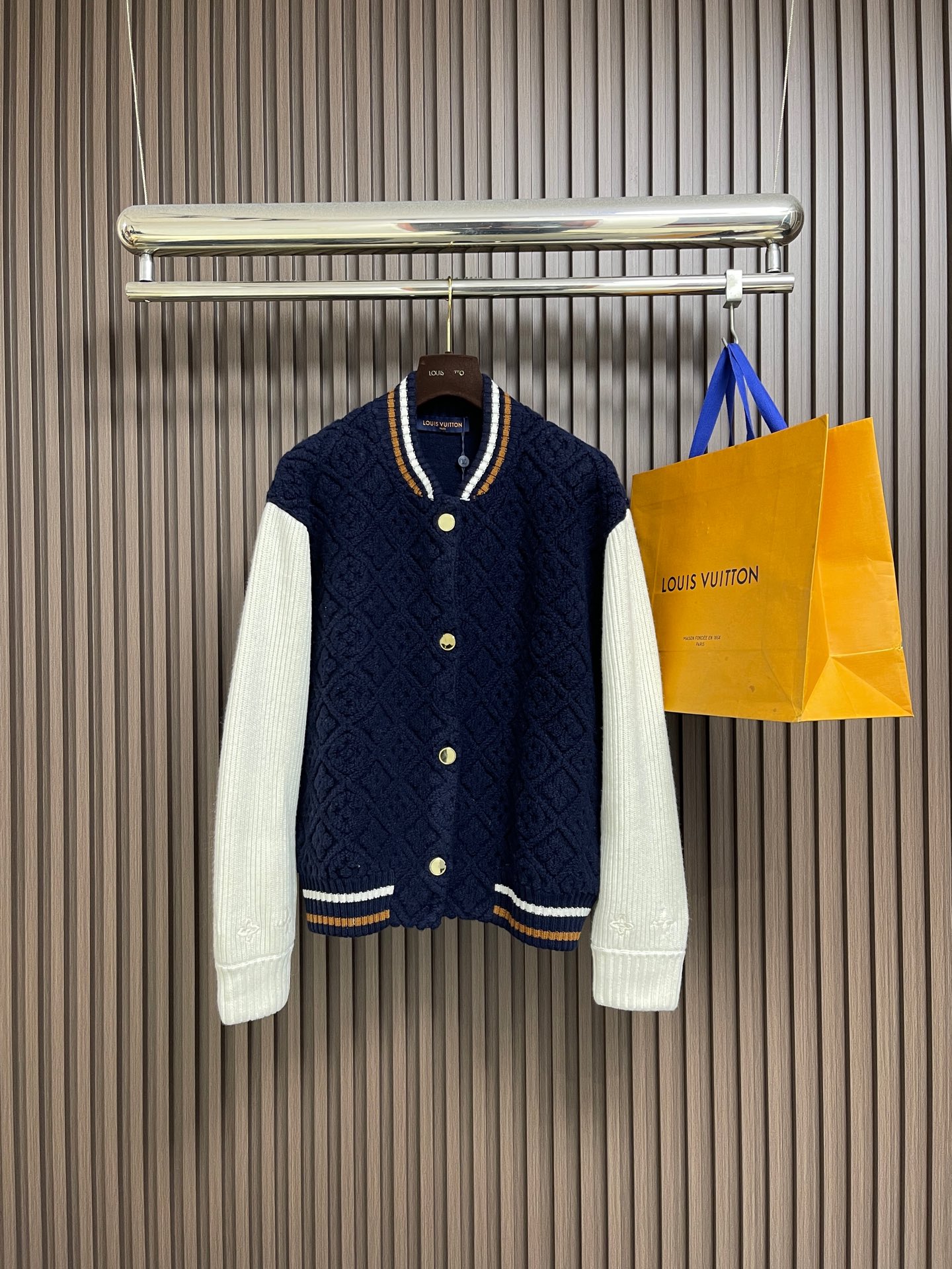 NO:730596,Support after-sales LV after the year  SKI ski series color-blocked striped baseball long-sleeved jacket. This Louis Vuitton color-blocked knitted cardigan uses three-dimensional cable knitting technology to create the main body. It uses high-count merino wool blended fabrics and is woven with double needle bed knitting machines to create concave and convex shapes.  The unique rhombus texture has a knitting density of 32 stitches per square centimeter, giving the texture both three-dimensionality and softness. The main body of the garment is made of navy blue custom-spun yarn, which has been washed and fixed for three times to effectively prevent fading. The sleeves are made of off-white vertical pits.  Striped rib knitting, the twist of a single yarn is controlled at 800 twist meters to ensure resilience and fit. The metal snaps are made of customized brass and treated with gold-plated glaze sealing process; the contrasting ribs on the collar and hem are intarsia woven to accurately match the brand.  The classic three-color webbing proportions, and the laser-engraved brand logo hidden on the cuffs. The overall process combines traditional knitting techniques with modern precision workmanship, and the details show the level of craftsmanship. The overall routing is straight and delicate, the fabric is comfortable and soft, and the colors are consistent without color difference.  It can be matched with the same style to create a fashionable look, and can be used in various occasions. Customized accessories, complete with three standards, same style for men and women!  Sizes S-XL,,louis vuitton,louis vuitton,jackets & coats,gold plating,19860909支持年后售后 LV SKI滑雪系列拼色条纹棒球长袖外套,这款路易威登拼色针织开衫采用立体绞花编织工艺打造主体衣身,选用高支数美利奴羊毛混纺面料,通过双针床针织机织造出凹凸有致的菱格纹理,每平方厘米编织密度达32针,让纹理兼具立体感与柔软度；衣身主体为藏青色定纺纱线,经三次水洗固色处理,有效防止褪色.袖子部分采用米白色竖坑条罗纹针织,单股纱线捻度控制在800捻米,保证回弹性与贴合度.金属按扣为定制黄铜材质,经镀金封釉工艺处理；领口、下摆的撞色罗纹采用嵌花编织,精准对接品牌经典三色织带比例,袖口处还暗藏激光雕刻的品牌标识,整体工艺融合传统针织技法与现代精工,细节处尽显匠造水准.整体走线平直细腻,面料舒适柔软,颜色一致无色差 能与同款搭配营造时尚造型,驾驭各种场合,定制辅料,三标齐全,男女同款！尺码S-XL,,louis vuitton,louis vuitton,jackets & coats,gold plating,,Men's clothing