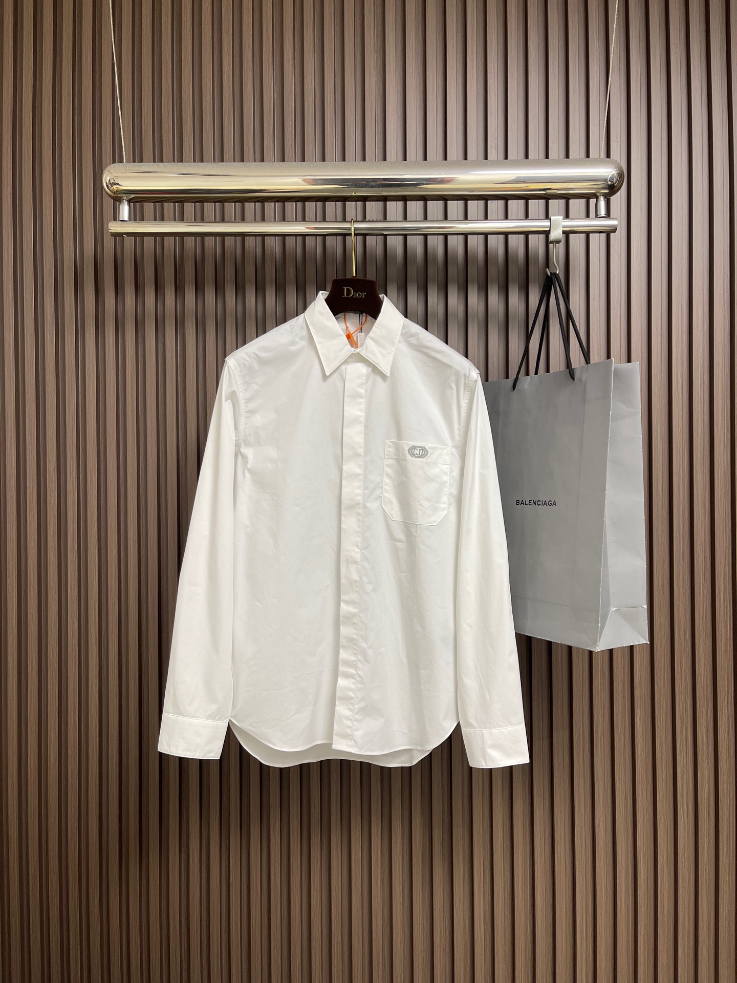 NO:735336,Dior chest pocket box embroidered long-sleeved shirt, custom silk satin poplin, delicate and soft, comfortable and close to the skin, a touch of simple white, pure and elegant, patch pocket CD Box logo embellished on the chest, carved invisible aristocratic coat of arms, sealing the architectural aesthetics and craftsmanship spirit of the 1947 haute couture workshop in the square inches of a white shirt. Only neat tailoring and precise details outline the design philosophy that high-end comes from order.  Demonstrate an effortless sense of luxury. Use imported machine embroidery technology and use advanced computer control systems and precision mechanical components to achieve CD Box logo embroidery operations with high precision. The lines are smooth and delicate, and the fabrics have been sand washed. The texture is better, not easy to deform, not easy to shrink, not easy to fade, and maintains long-term beauty. The overall wiring is straight and delicate, the fabric is comfortable and soft, and the color is consistent without color difference. It can be matched with the same style to create a fashionable look and control various occasions. Customized accessories, complete three labels, the same style for men and women!  Size 39-40-41-42 S-XL,,dior,shirts,19860909Dior 胸前口袋Box 刺绣长袖衬衫,定制丝缎府绸 细腻柔软 舒适贴肤 一抹简约白 纯净如初 优雅自现 贴袋CD Box标志点缀于胸前 雕琢隐形的贵族纹章 将1947年高订工坊的建筑美学与手工精神封存在一件白衬衫的方寸之间 仅以利落的剪裁与精准的细节 勾勒出高级感源于秩序的设计哲学 演绎不费力的高级感.采用进口机刺绣工艺 使用先进的计算机控制系统和精密的机械部件 实现CD Box 标志刺绣作业 精度高 线条流畅而细腻,面料都经过砂洗 手感质感更佳 不易变形 不易缩水 不易褪色 保持长久的美观.整体走线平直细腻,面料舒适柔软,颜色一致无色差 能与同款搭配营造时尚造型,驾驭各种场合,定制辅料,三标齐全,男女同款！尺码39-40-41-42 S-XL,,dior,shirts,,Men's clothing