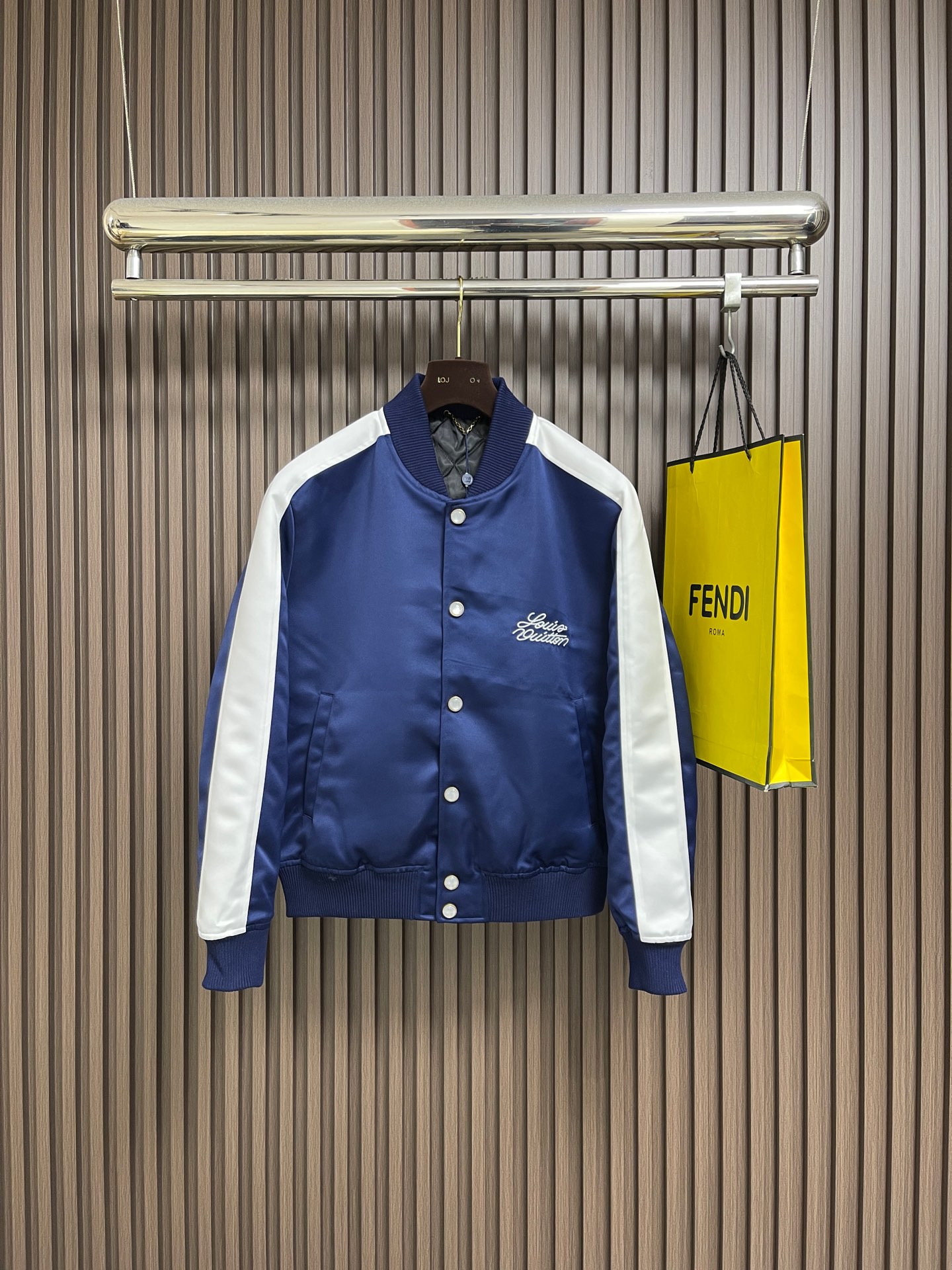 NO:735357,LV  Year of the Horse limited edition single-breasted long-sleeved jacket with contrasting ribbon embroidery. This LV Year of the Horse limited edition contrasting color ribbon embroidered jacket is made of heavy matte satin fabric, which has both a crisp drape and a smooth touch. The surface is treated with anti-wrinkle and water-repellent treatment.  , convenient for daily care. The stand-up collar, cuffs, and hem are made of high-elastic rib knitting, which fits tightly and is not easy to loosen and deform. The placket is made of custom matte metal single-breasted buttons, and the button surface is engraved with the brand logo, which has both texture and recognition. Shoulder  The contrasting ribbons at the waist and sleeves are spliced with twill, and the edges are hemmed to avoid off-line. The brand logo on the left chest is embroidered three-dimensionally, with multiple stitches to present a full texture. The interior is breathable, and all seams are hemmed and overlocked. The overall process combines traditional baseball uniforms with exclusive design elements for the Year of the Horse, which has both collection value and practical wearability. The overall line routing is straight and delicate, the fabric is comfortable and soft, and the colors are consistent and without color difference.  It can be matched with the same style to create a fashionable look, and can be used in various occasions. Customized accessories, complete with three standards, same style for men and women!  Sizes S-XL,,louis vuitton,jackets & coats,19860909LV 马年限定撞色饰带刺绣单排扣长袖夹克,这款LV马年限定撞色饰带刺绣夹克,采用重磅哑光缎面面料,兼具挺括垂坠感与柔滑触感,表面经抗皱防泼水处理,日常打理便捷.立领与袖口、下摆采用高弹罗纹针织,紧密贴合且不易松弛变形,门襟选用定制哑光金属单排扣,扣面刻有品牌标识,兼具质感与辨识度.肩部与袖身的撞色饰带采用斜纹拼接工艺,边缘经包边处理避免脱线,左胸的品牌标识采用立体刺绣工艺,以多股线迹呈现饱满纹理,内里采用透气衬里,所有缝线处均做包边与锁边处理,整体工艺将传统棒球服版型与马年专属设计元素结合,兼具典藏价值与实穿性.整体走线平直细腻,面料舒适柔软,颜色一致无色差 能与同款搭配营造时尚造型,驾驭各种场合,定制辅料,三标齐全,男女同款！尺码S-XL,,louis vuitton,jackets & coats,,Men's clothing