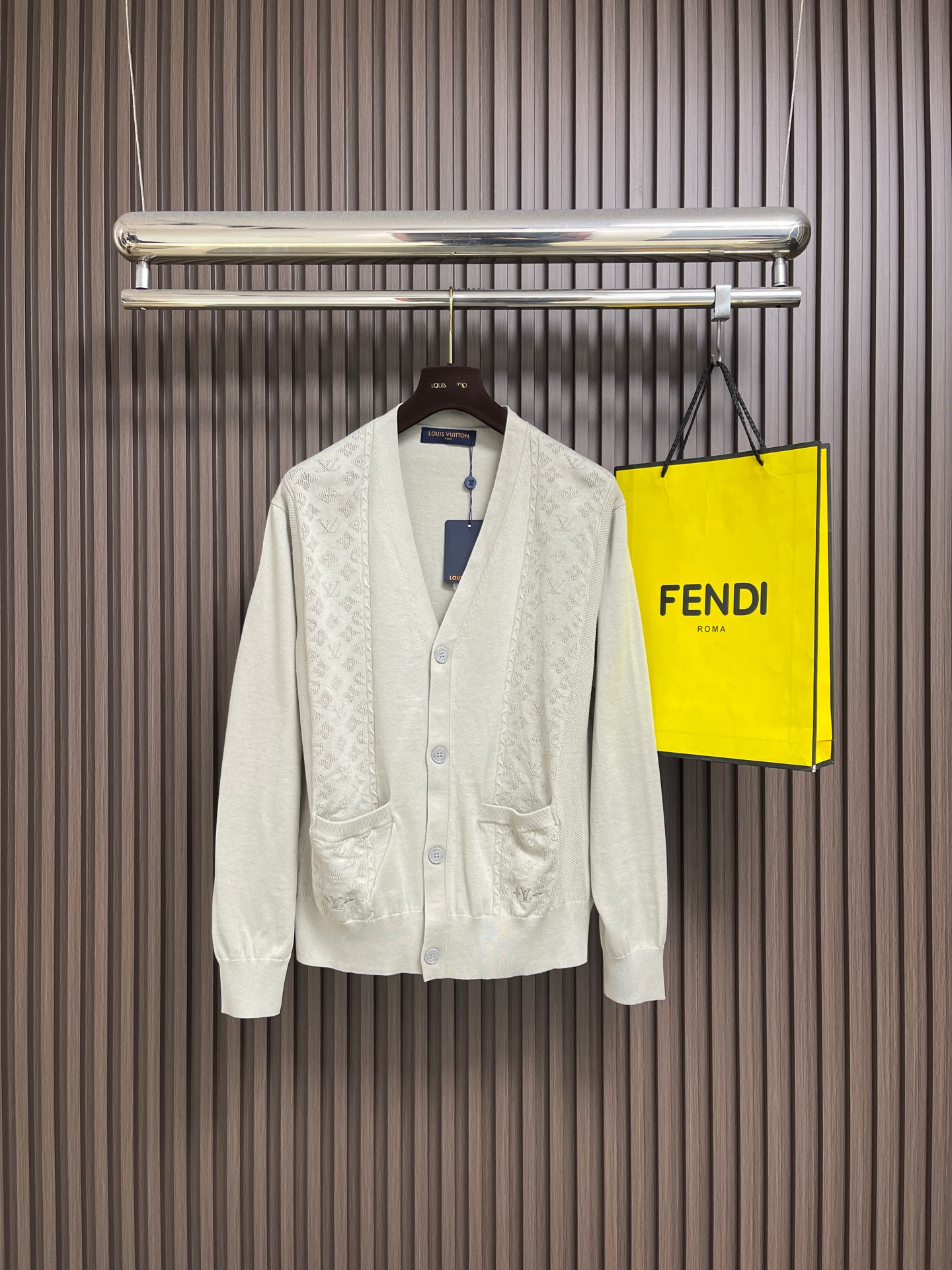 NO:745817,LV  Letter perforated jacquard splicing knitted cardigan sweater. This V-neck knitted cardigan is made of high-quality blended wool yarn and is made with precision knitting technology. It has a soft and skin-friendly touch and excellent warmth retention. The classic V-neck style is paired with a neat placket and custom matte buttons, which open and close smoothly and have a high-end texture. The body is integrated with the brand's iconic jacquard texture, and is twisted through three-dimensional twists.  The floral craftsmanship is interwoven, the pattern is clear and three-dimensional, and it is not easy to deform after long-term wear. There are patch pockets on both sides, the bag body and the jacquard area are seamlessly connected, and the lines are neat. The cuffs and hem are edged with high-elastic ribs, which fit the body shape without being tight. The overall workmanship is fine, showing the light luxury style and exquisite craftsmanship. The overall lines are straight and delicate, the fabric is comfortable and soft, and the colors are consistent and without color difference.  It can be matched with the same style to create a fashionable look, and can be used in various occasions. Customized accessories, complete with three standards, same style for men and women!  Size S-XL S size bust 108 shoulder width 50 length 66 medium size bust 112 shoulder width 52 length 68 L size bust 116 shoulder width 54 length 70 XL size bust 120 shoulder width 56 length 72,,louis vuitton,sweaters,19860909LV 字母穿孔提花拼接针织开衫毛衣,这款V领针织开衫甄选优质混纺羊毛纱线,经精密针织工艺打造,兼具软糯亲肤的触感与出色的保暖性.经典V领版型搭配利落门襟,采用定制哑光纽扣,开合顺滑且质感高级.衣身融入品牌标志性提花纹理,通过立体绞花工艺交织呈现,图案清晰立体,久穿不易变形.两侧设有贴袋设计,袋身与提花区域无缝衔接,走线工整.袖口与下摆采用高弹罗纹收边,贴合身形不紧绷,整体做工精细,尽显轻奢格调与精湛工艺.整体走线平直细腻,面料舒适柔软,颜色一致无色差 能与同款搭配营造时尚造型,驾驭各种场合,定制辅料,三标齐全,男女同款！尺码S-XL S码 胸围108 肩宽50衣长66 M码胸围112肩宽52衣长68 L码 胸围116肩宽54衣长70 XL码胸围120肩宽56衣长72,,louis vuitton,sweaters,,Men's clothing