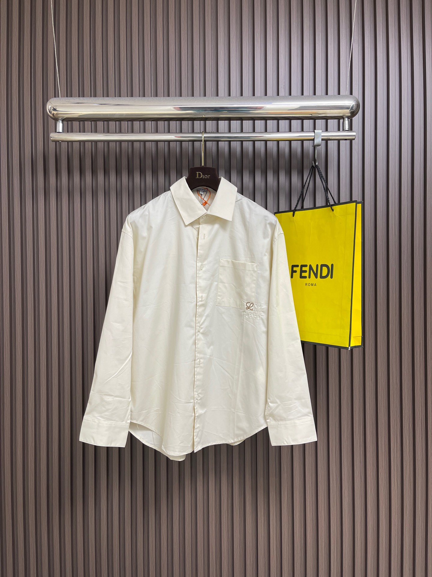 NO:756890,Loewe Anagram two-color embroidered patch pocket long-sleeved shirt. Custom-dyed cloud satin twill shirt material. Excellent texture. Comfortable and close to the skin. Presented with a touch of khaki brown with age. It is intriguing and high-end. The chest patch pocket is decorated with two-color Anagram embroidery. Each silk thread of the two-color embroidery flows in clear and hazy with the light. It injects a sense of breathing into the totem. At the same time, it has a retro soul and a modern attitude. It interprets high-end fashion style. It uses imported machine embroidery.  Using advanced computer control systems and precision mechanical components to achieve Loewe Anagram two-color semi-finished embroidery work, the workmanship is smooth and smooth, with a full sense of lines. The stitches are fine and adopt the side-turn buried clamping threading process. The fabrics are smooth and neat, and the fabrics have been sand washed. They have a better hand feel and are not easy to deform, not easy to shrink, not easy to fade, and maintain long-term beauty. The overall wiring is straight and delicate, the fabric is comfortable and soft, and the color is consistent without color difference.  It can be matched with the same style to create a fashionable look, and can be used in various occasions. Customized accessories, complete with three standards, same style for men and women!  Size S-XL 36-38-40-42,,loewe,shirts,19860909Loewe Anagram 双色刺绣贴袋长袖衬衫 定制定染云缎斜纹衬衫料 质感卓越 舒适贴肤 以一抹带着岁月沉淀的卡其棕呈现 耐人寻味的高级 胸前贴袋饰有双色Anagram刺绣 双色刺绣的每一根丝线都随光线照射在清晰与朦胧流转 为图腾注入呼吸感 同时拥有复古的灵魂与现代的态度 诠释着高级的时尚格调.采用进口机绣花 使用先进的计算机控制系统和精密的机械部件 实现Loewe Anagram双色半成品绣花作业 做工工整平整 线条感十足 针脚细密采用侧翻埋夹车线工艺 平顺整洁工整整洁面料都经过砂洗 手感质感更佳 不易变形 不易缩水 不易褪色 保持长久的美观.整体走线平直细腻,面料舒适柔软,颜色一致无色差 能与同款搭配营造时尚造型,驾驭各种场合,定制辅料,三标齐全,男女同款！尺码S-XL 36-38-40-42,,loewe,shirts,,Men's clothing