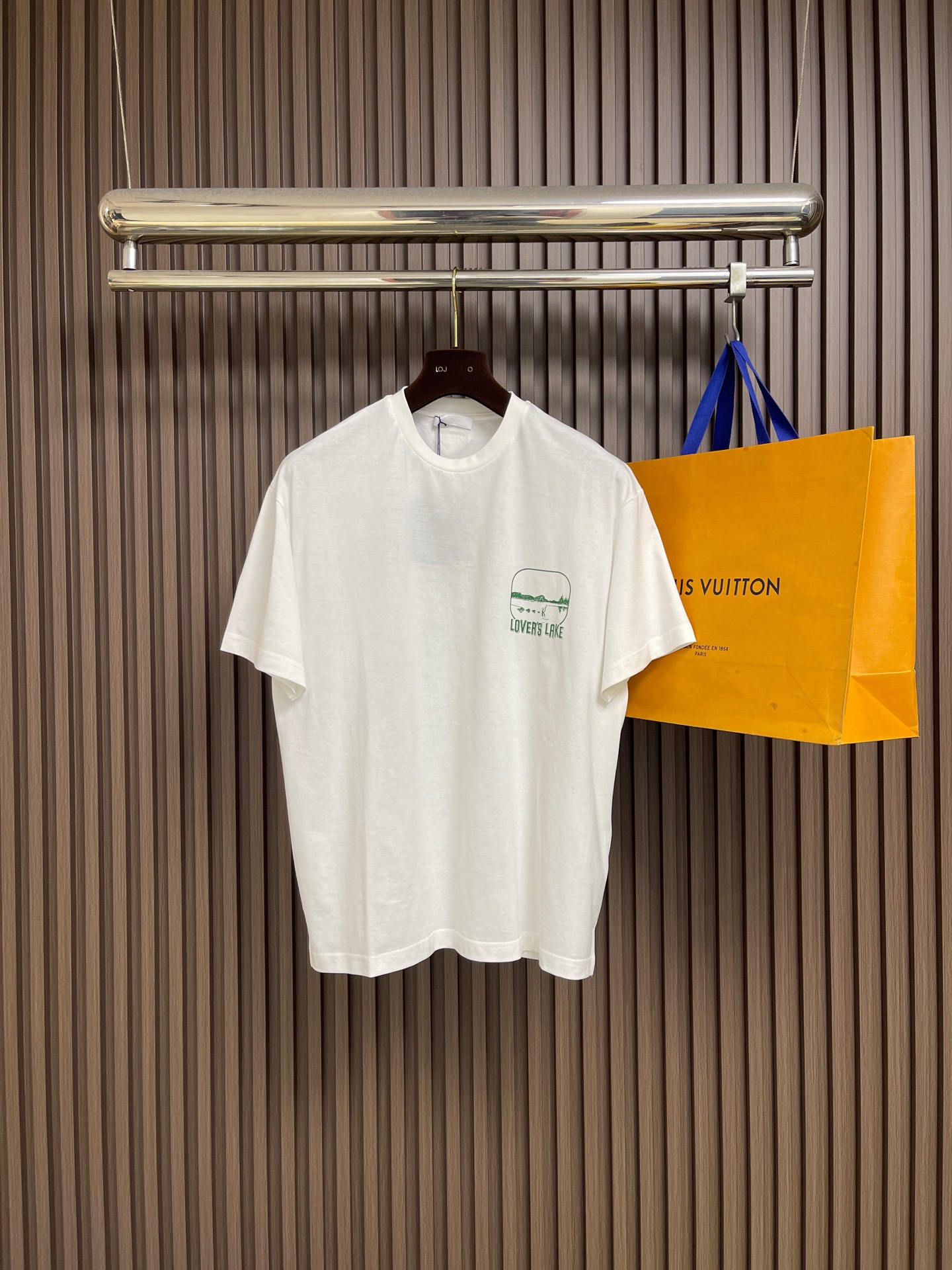 NO:827548,PRADA lake view printed casual short-sleeved T-shirt is made of imported high-count heavyweight pure cotton fabric. The texture is tight and thick, soft and skin-friendly. It has excellent breathability and anti-wrinkle properties. It is not easy to deform and pill after long-term wear. It perfectly balances wearing comfort and garment texture; classic round neck design, customized LOVERS on the left chest of the body  LAKE lake view themed printing outlines the lakeside scenery and letter logo in fresh green tones. It is full of design, breaks the monotony of the basic white T-shirt, and injects a relaxed atmosphere into the outfit. The printing uses imported environmentally friendly offset printing technology, with high color saturation, clear and sharp edges, and is firm and will not crack or fall off. Every detail  All show off the brand's top craftsmanship; the loose shoulder sleeves are cut, regardless of body shape or outfit, easily modify the shoulder line, creating a casual and relaxed wearing atmosphere, suitable for various dressing scenes; the cuffs and hem adopt double stitching technology, the routing is neat and delicate, the workmanship is rigorous, and the details are full of ingenuity and quality. Size XS-L  XL size, bust 114, shoulder width 50.5, dress length 70, S size, chest size 118, shoulder width 52, dress length 72, M size, chest size 122, shoulder width 53.5, dress length 74, L size, chest size 126, shoulder width 55, dress length 76,, prada, versace, T-shirt, tees, t-shirt,19860909PRADA 湖景印花休闲短袖T恤,采用进口高支重磅纯棉面料,质地紧密厚实,触感柔软亲肤,兼具出色的透气性与抗皱性,久穿不易变形起球,完美兼顾穿着舒适度与成衣质感；经典圆领设计,衣身左胸定制LOVERS LAKE湖景主题印花,以清新绿色调勾勒湖畔风景与字母标识,设计感十足,打破基础白T的单调感,为穿搭注入松弛氛围感；印花采用进口环保胶印工艺,色彩饱和度高,边缘清晰锐利,牢固不开裂不脱落,每一处细节都彰显品牌顶级工艺；宽松落肩袖剪裁,不挑身材不挑穿搭,轻松修饰肩线,打造随性松弛的穿搭氛围,适配多元穿搭场景；袖口与下摆采用双车线锁边工艺,走线工整细腻,做工严谨,细节处尽显匠心品质.尺码XS-L XL码胸围114肩宽50.5 衣长70 S码 胸围118肩宽52 衣长72 M码胸围122肩宽53.5衣长74 L码 胸围126肩宽55 衣长76,,prada,versace,T-shirt,tees，t-shirt,,Men's clothing