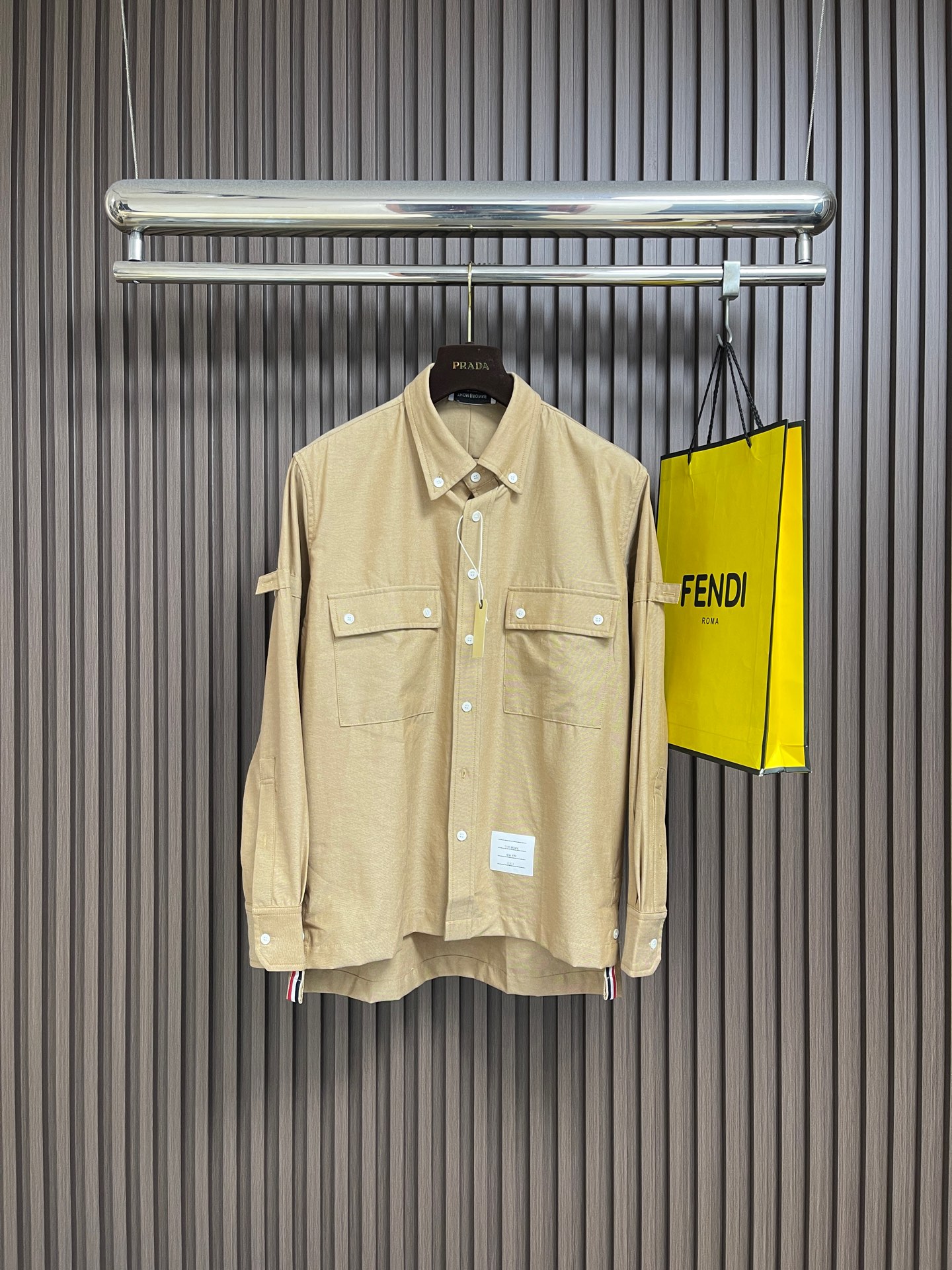 NO:775873,ThomBrowne TB work style OS long-sleeved shirt, imported pure cotton fabric, real mother-of-pearl white buttons, belongs to the brand's classic Overshirt (loose work shirt)  The overall style presents a unique temperament that combines American retro workwear and modern luxury goods. On the basis of classic workwear shirts, minimalist tailoring and iconic brand details are injected. They not only retain the practicality and toughness of workwear, but also enhance the overall sense of high-end and recognition through exquisite fabrics and unique striped elements. They are suitable for wearers who pursue low-key luxury and unique taste. Size 1-2-3-4 1 code, bust 104, shoulder width 45, length 74 2 code  Bust 110, shoulder width 46, length 75, size 3, bust 116, shoulder width 47, length 76, size 4, bust 122, shoulder width 48, length 77,,thom browne,versace,shirts,19860909ThomBrowne汤姆布朗 TB 工装风OS长袖衬衫,进口纯棉面料 真贝母白色纽扣,属于该品牌经典的 Overshirt（宽松工装衬衫） 风格,整体呈现出一种融合美式复古工装与现代奢侈品的独特气质.在经典的工装衬衫基础上,注入极简主义的剪裁和标志性的品牌细节.它们既保留了工装的实用性和硬朗感,又通过精致的面料和独特的条纹元素提升了整体的高级感和辨识度,适合追求低调奢华与独特品味的穿着者.尺码1-2-3-4 1码 胸围104 肩宽45衣长74 2码 胸围110 肩宽46衣长75 3码 胸围116 肩宽47衣长76 4码 胸围122 肩宽48衣长77,,thom browne,versace,shirts,,Men's clothing