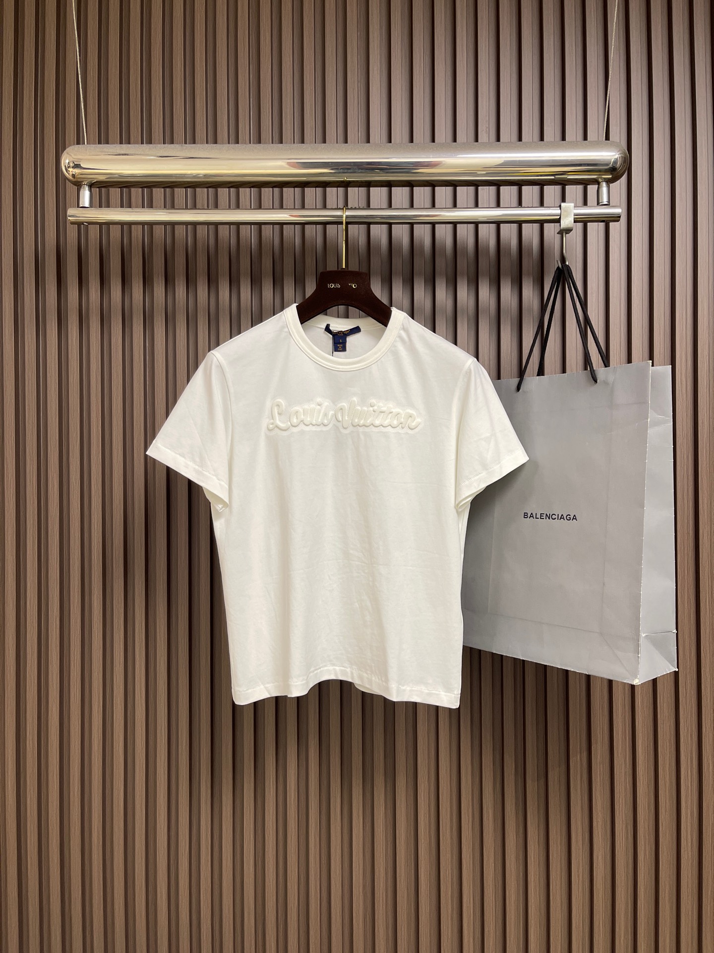 NO:775905,LV The three-dimensional wave round neck short-sleeved T-shirt is made of 15-count special-spun compact cotton with a weight of 230gm2; it is matched with 32-count 1x1 rib; the weight is 340gm2. The fabric is a medium-thick knitted fabric, and the 15-count yarn is thicker. The fabric has a strong texture and a crisp texture. The cotton fiber cross-section of the fabric is round, which significantly enhances the gloss and smoothness. The mercerization can improve the even adsorption of dyes. properties, making the background color of the fabric more plump and uniform. After being stretched and set by a high-temperature setting machine, the warp and weft yarns are restored to straightness through tension control, eliminating wrinkles and internal stress. The 32-count rib collar retracts to the best elastic state, and the tight structure of the rib is fully stabilized in the process, forming a collar shape that fits without being tight. The overall routing is straight and delicate, the fabric is comfortable and soft, and the color is consistent without color difference. It can be matched with the same style to create a fashionable look, and can be used in various occasions. Customized accessories, complete with three standards, same style for men and women! Size S-M-L S ​​size, bust 102, shoulder width 43, length 60, size M, bust 106, shoulder width 44, length 61, size L, bust 110, shoulder width 45, length 62,, louis vuitton, T-shirt, tees, t-shirt,19860909LV 立体浪花圆领短袖T恤,采用15支特纺紧密棉,克重为230gm2；搭配32支1x1罗纹；克重为340gm2.面料属于中厚型针织面料,15支纱线较粗,织物肌理感强,质地挺括.面料棉纤维截面圆润,显著增强光泽度与平滑感,丝光能提升染料的吸附均匀性,使面料底色更加饱满匀净.后经高温定型机拉幅定形,通过张力控制使经纬纱恢复平直,消除褶皱与内应力.32支罗纹的领口回缩至最佳弹性状态,罗纹的紧实结构在此过程中充分稳定,形成贴合而不勒的领型.整体走线平直细腻,面料舒适柔软,颜色一致无色差 能与同款搭配营造时尚造型,驾驭各种场合,定制辅料,三标齐全,男女同款！尺码S-M-L S码 胸围102 肩宽43 衣长60 M码胸围106 肩宽44 衣长61 L码 胸围110 肩宽45衣长62,,louis vuitton,T-shirt,tees，t-shirt,,Men's clothing