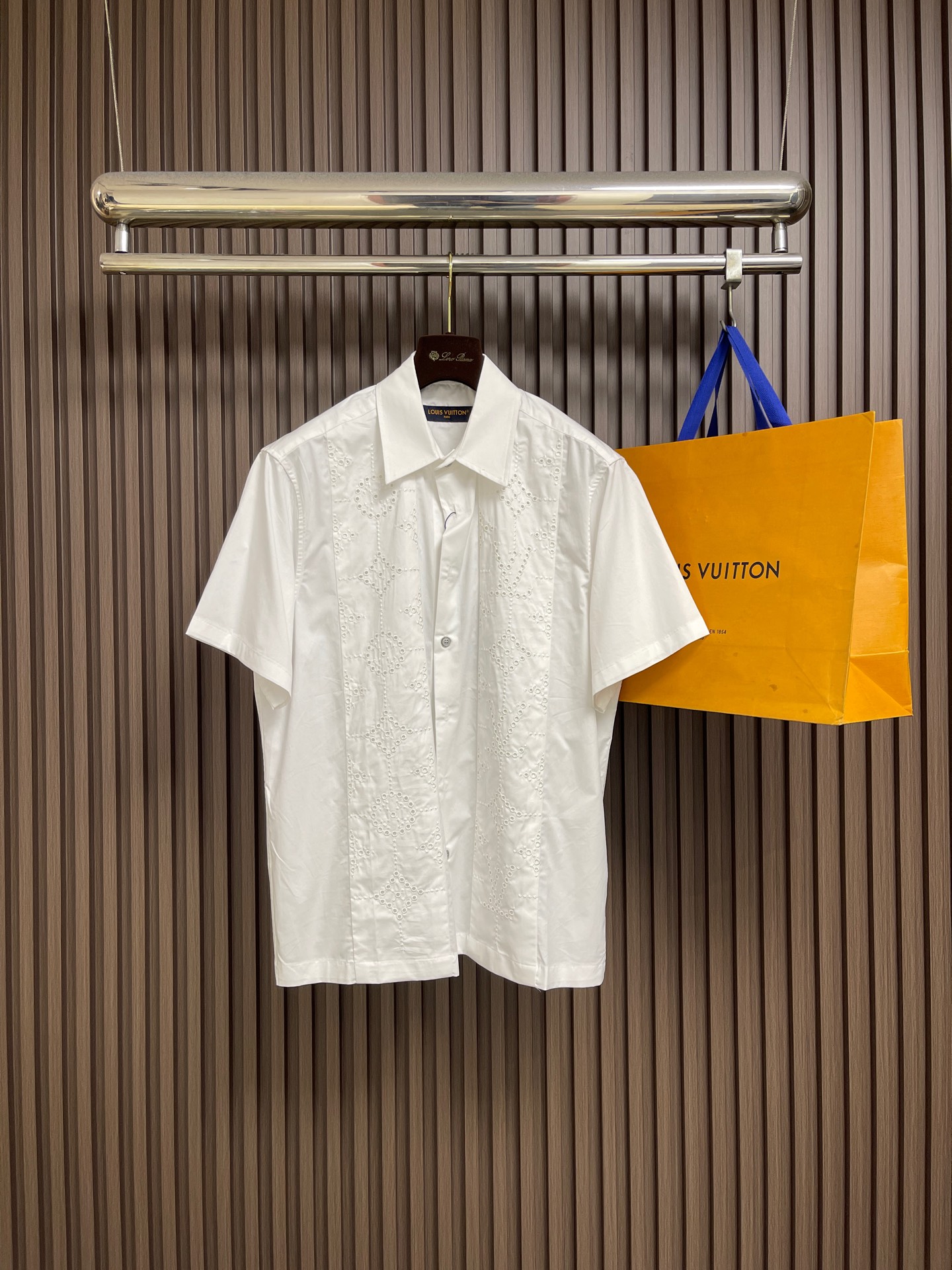 NO:775912,LV Hollow Hollow Short-Sleeved Shirt. This short-sleeved shirt uses exquisite hollow embroidery technology. The symmetrical geometric pattern on the chest adds beauty to the details. The simple lapel is matched with a classic button placket, and the tailoring is neat and slim. The fabric is crisp and breathable, suitable for daily commuting or casual occasions. Easily paired with pants to create an elegant and casual style and enhance the overall look. Sizes S-XL S Size Bust 118 Shoulder Width 48 Length 72 Medium Bust 122  Shoulder width 50, length 73.5 L, bust 126, shoulder width 52, length 75, size XL, chest 130, shoulder width 54, length 76.5,,louis vuitton,shirts,T-shirt,19860909LV 镂空洞洞短袖衬衫,这款短袖衬衫采用精致镂空刺绣工艺,胸前对称几何图案增添细节美感,简约翻领搭配经典纽扣门襟,剪裁利落显瘦.面料挺括透气,适合日常通勤或休闲场合.轻松搭配裤装,打造优雅随性风格,提升整体造型质感.尺码S-XL S码 胸围118 肩宽48 衣长72 M码胸围122 肩宽50 衣长73.5 L码 胸围126 肩宽52 衣长75 XL码胸围130 肩宽54 衣长76.5,,louis vuitton,shirts,T-shirt,,Men's clothing