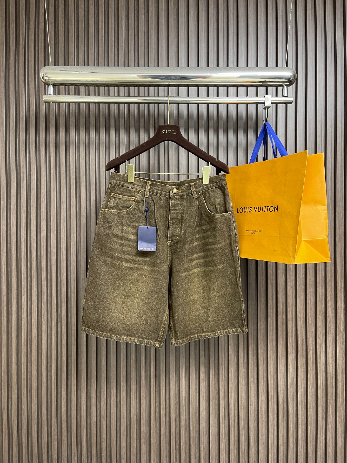 NO:775907,LV  Distressed washed denim shorts with leather label are made of imported heavyweight denim fabric. After multiple distressed washing processes, they present a natural retro tan tone. The fabric is thick and crisp, with excellent wear resistance and breathability. The upper body is comfortable and not sweaty. Perfect  Suitable for spring and summer wear; classic high-waisted straight-leg pants design, with metal buttons and zipper placket at the waist, smooth opening and closing, fitting the waist and abdomen lines, more tolerant to the body, easily modifying the leg shape, creating a casual and relaxed retro style; there are waistbands on both sides.  The typical diagonal pockets are paired with double patch pockets on the back, which combines practicality and style. The back pockets are embellished with the brand's exclusive letter embroidery logo, with fine and neat stitching, low-key highlighting the brand recognition; the trousers are made of bright yellow contrasting topstitching, which is evenly and firmly routed.  Every stitching accurately fits the shape, which not only strengthens the structural stability, but also adds a sense of detail to the overall shape; the back of the waistband is equipped with the brand's exclusive leather label, which has a delicate texture and is hot-printed with the brand logo. The details show the high-end clothing standards. Sizes S-XL  29-30-31-32 The counter sizes are too large. 29 yards, pants length 58, waist 85 hips 105, 30 yards pants length 59, waist 89 hips 109, 31 yards pants length 60, waist 93 hips 113, 32 yards, pants length 61, waist 97 hips 117,, Louis Vuitton, shorts,19860909LV 皮标做旧水洗牛仔短裤,采用进口重磅丹宁牛仔面料,经过多重做旧水洗工艺处理,呈现出自然复古的棕褐色调,面料厚实挺括,兼具出色的耐磨性与透气性,上身舒适不闷汗,完美适配春夏穿搭；经典高腰直筒裤型设计,搭配腰头金属纽扣与拉链门襟,开合顺畅,贴合腰腹线条,对身材包容度更高,轻松修饰腿型,打造随性松弛的复古穿搭氛围；腰头两侧设置经典斜插口袋,搭配后片双贴袋设计,兼具实用性与造型感,后袋点缀品牌专属字母刺绣标识,针脚细密工整,低调彰显品牌辨识度；裤身采用明黄色撞色明线工艺,走线均匀牢固,每一处缝线都精准贴合版型,既强化了结构稳定性,又为整体造型增添了细节层次感；腰头后侧配备品牌专属皮质皮标,质感细腻,烫印品牌标识,细节处尽显高端制衣水准.尺码S-XL 29-30-31-32 专柜码数偏大 29码 裤长58 腰围85臀围105 30码 裤长59 腰围89臀围109 31码裤长60 腰围93臀围113 32码 裤长61腰围97臀围117,,louis vuitton,shorts,,Men's clothing