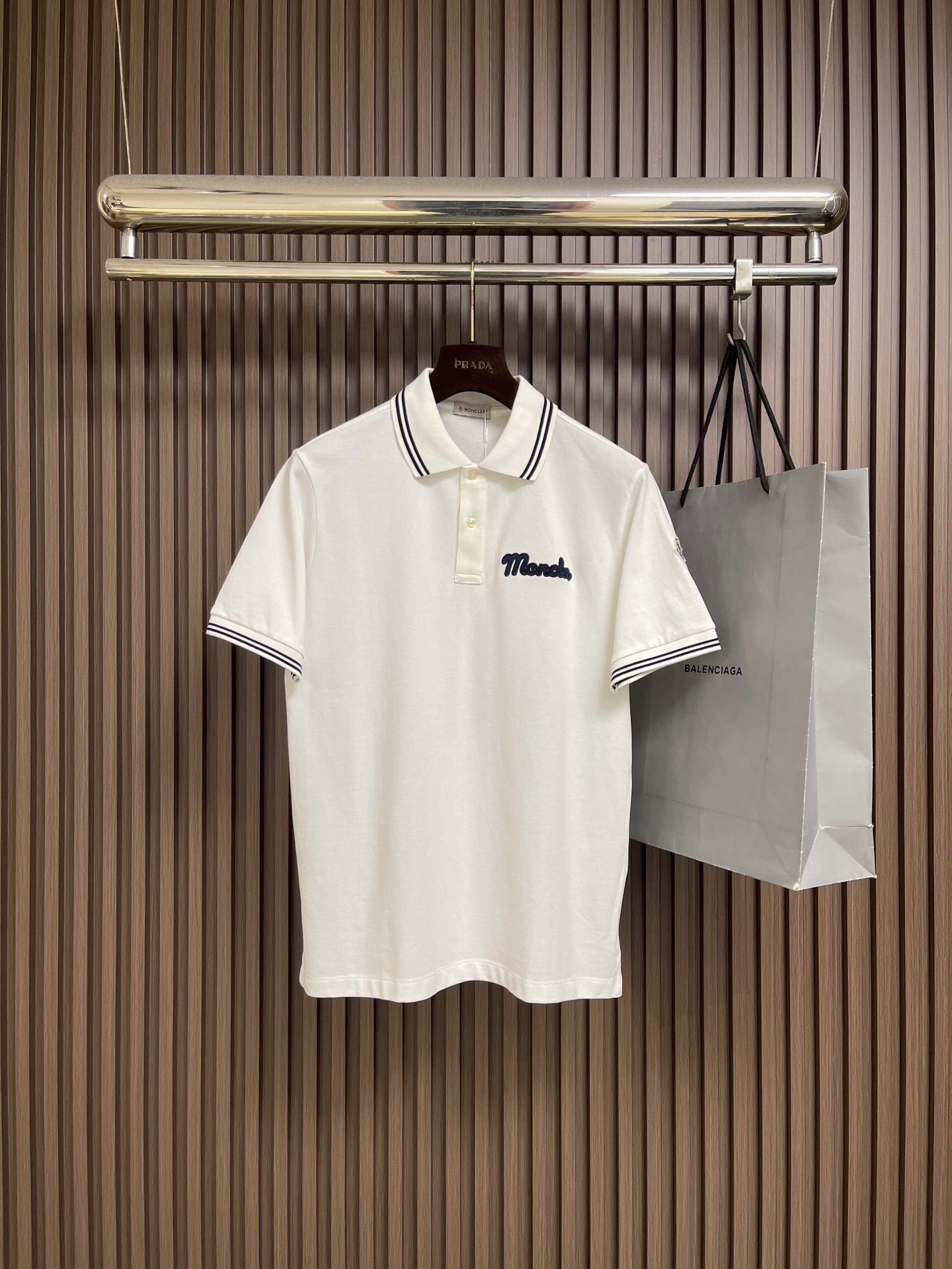 NO:775892,MONCLER  The classic logo embroidered short-sleeved POLO is made of imported high-count double-strand pique mesh pure cotton fabric. It has been pre-shrunk and enzyme-washed. The texture is tight and crisp, breathable and skin-friendly. The upper body is refreshing and not sweaty. It also has excellent wrinkle resistance and drape. It is not easy to deform after long-term wear. It is perfect for daily commuting, leisure travel and other scenes. The classic lapel design fits the neck line and is neat.  Stylish, with a three-button placket, the opening and closing can be adjusted freely, making it easy to create different styles; the left chest is custom-made with three-dimensional M letter embroidery, using high-density embroidery thread, with fine and full stitches, and the contrasting color binding process is more exquisite and eye-catching, making it more recognizable and highlighting the brand's high-end tone; the iconic brand badge logo on the sleeves is made of precision woven label technology, with exquisite details, which instantly enhances the texture of the outfit. Size M-XXL  M size bust 104 shoulder width 45 length 70 L size bust 108 shoulder width 46 length 72 XL size bust 112 shoulder width 47 length 74 XXL size bust 116 shoulder width 48 length 76,,T-shirt,19860909MONCLER 经典logo标识刺绣短袖POLO,采用进口高支双股珠地网眼纯棉面料,经过预缩水处理与酵素洗工艺,质地紧密挺括、透气亲肤,上身清爽不闷汗,同时兼具出色的抗皱性与垂坠感,久穿不易变形,完美适配日常通勤、休闲出行等多场景穿着；经典翻领设计,贴合颈部线条,利落有型,搭配三粒扣门襟,可自由调节开合度,轻松打造不同穿搭风格；左胸定制立体M字母刺绣,甄选高密绣线,针脚细密饱满,撞色包边工艺更显精致醒目,辨识度拉满,彰显品牌高端调性；袖身标志性品牌徽章标,采用精密织唛工艺,细节考究,瞬间提升穿搭质感.尺码M-XXL M码 胸围104肩宽45 衣长70 L码胸围108肩宽46 衣长72 XL码 胸围112 肩宽47 衣长74 XXL码 胸围116 肩宽48 衣长76,,T-shirt,,Men's clothing