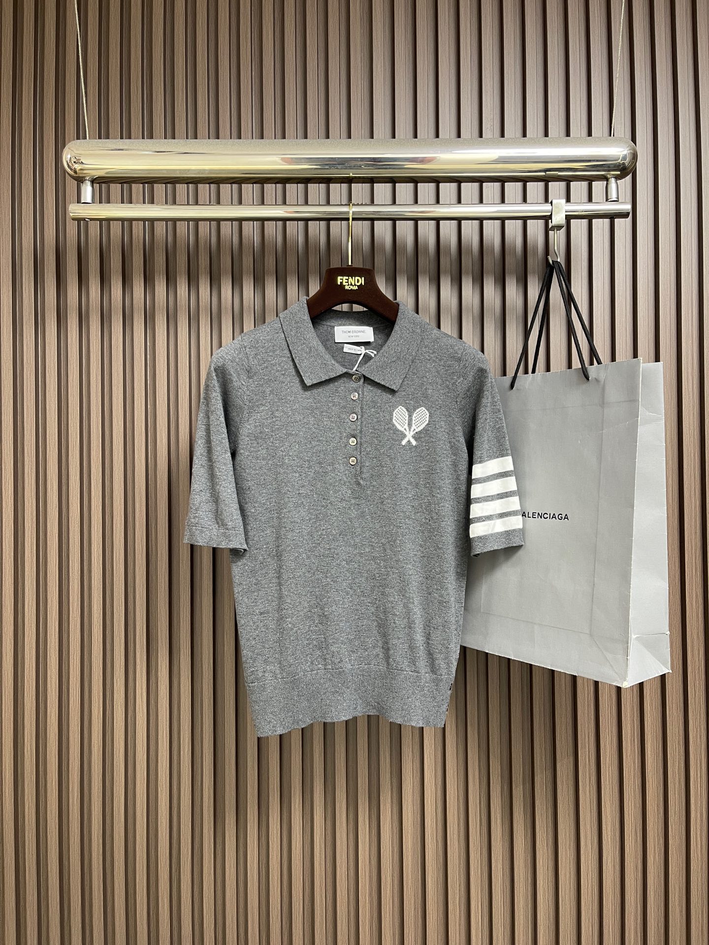 NO:827474,THOM BROWNE TB tennis racket jacquard short-sleeved polo, this Thom  Browne navy blue, made of high-count worsted wool blended fabric, has a delicate touch and skin-friendly feel, excellent drape and breathability, and is not easily deformed after long-term wear. The classic lapel is matched with five custom-made metal buttons on the placket, which opens and closes smoothly and has outstanding texture. The left chest uses jacquard technology to present a cross tennis racket pattern, with fine three-dimensional stitching, restoring the brand's iconic sports aesthetics. The four classic white stripes on the right arm are inlaid with contrasting colors.  Art, the lines are neat and neat, and the recognition is full. The whole piece adopts seamless one-piece molding technology, and the collar, cuffs and hem are ribbed, which fits the body shape and is not easy to loosen. The wiring is neat and elegant, and every detail strictly follows the brand craftsmanship standards, taking into account both casual commuting and light sports scenes. The upper body is neat and stylish, showing high-end texture and brand style. The overall wiring is straight and delicate, the fabric is comfortable and soft, and the color is consistent and without color difference.  It can be matched with the same style to create a fashionable look, and can be used in various occasions. Customized accessories, complete with three standards, same style for men and women!  Size 1-2-3-4 1 size bust 92 shoulder width 34 length 62 size 2 bust 96 shoulder width 35 length 64 3 size chest 102 shoulder width 36 length 66 4 size chest 108 shoulder width 37 length 68,, T-shirt,19860909THOM BROWNE TB 网球拍提花短袖polo,这件Thom Browne藏青色,采用高支精纺羊毛混纺面料打造,触感细腻亲肤,兼具优异垂坠感与透气性能,久穿不易变形.经典翻领搭配门襟五颗定制金属纽扣,开合顺滑且质感出众；左胸以提花工艺呈现交叉网球拍图案,针脚细立体,还原品牌标志性运动美学.右臂四道经典白色条纹采用撞色嵌花工艺,线条工整利落,辨识度拉满.整件采用无缝一体成型技术,领口、袖口及下摆做罗纹收边,贴合身形且不易松垮.走线工整考究,每一处细节都严格遵循品牌工艺标准,兼顾休闲通勤与轻运动场景,上身利落有型,尽显高级质感与品牌格调.整体走线平直细腻,面料舒适柔软,颜色一致无色差 能与同款搭配营造时尚造型,驾驭各种场合,定制辅料,三标齐全,男女同款！尺码1-2-3-4 1码 胸围92 肩宽34衣长62 2码 胸围96 肩宽35衣长64 3码 胸围102 肩宽36衣长66 4码 胸围108 肩宽37衣长68,,T-shirt,,Men's clothing