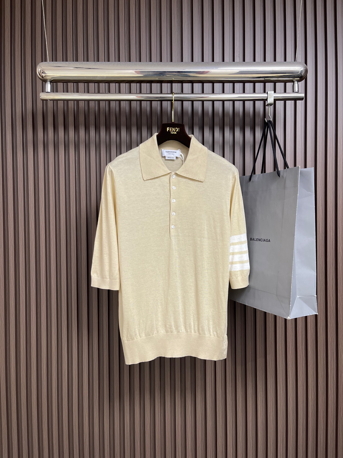 NO:831343,THOM BROWNE TB  Wool knitted three-quarter sleeve short-sleeved polo. This mid-sleeve knitted polo shirt is made of delicate and skin-friendly wool blended fabrics. It is soft and smooth to the touch, has good breathability and anti-wrinkle properties, and is comfortable and not sweaty on the upper body. It is not easy to deform after long-term wear. Classic flip  The collar design is matched with a half-open placket, and custom-made metal buttons are used. The opening and closing are smooth, strong and durable, and enhance the sophistication. The iconic four white bars on the sleeves are made of precision jacquard technology, with neat and clear lines and sharp color contrast, which is not easy to snag or pill.  , it still maintains a crisp shape after washing. The body is made of four-knit knitting technology, with a fine and full texture, and a stable and stylish structure. The brand's iconic metal buckle is embellished on the side of the hem, giving it a full sense of detail. The loose shoulder cut is suitable for a variety of body shapes, taking into account commuting and  It is a versatile item for creating simple and high-end outfits in casual scenes. The overall wiring is straight and delicate, the fabric is comfortable and soft, and the color is consistent without color difference. It can be matched with the same style to create a fashionable look, and can be used in various occasions. Customized accessories, complete with three standards, the same style for men and women!  Size 1-2-3-4 1 size bust 100 shoulder width 41 length 62 2 size bust 104 shoulder width 42 length 64 3 size bust 108 shoulder width 43 length 66 4 size chest 112 shoulder width 44 length 68,, T-shirt,19860909THOM BROWNE TB 羊毛针织七分袖短袖polo,这件中袖针织Polo衫甄选细腻亲肤的羊毛混纺面料,触感柔软顺滑,兼具良好的透气性与抗皱性,上身舒适不闷汗,久穿不易变形.经典翻领设计搭配半开襟门襟,选用定制金属质感纽扣,开合顺滑且牢固耐用,提升精致度.袖身标志性四道白杠采用精密提花工艺,线条工整清晰,色彩对比鲜明,不易勾丝、不起球,水洗后依旧保持挺括造型.衣身采用四平针编织工艺,纹理细腻饱满,结构稳定有型.下摆侧边点缀品牌标志性金属扣,细节感拉满.宽松落肩剪裁适配多种身形,兼顾通勤与休闲场景,是打造简约高级穿搭的百搭单品.整体走线平直细腻,面料舒适柔软,颜色一致无色差能与同款搭配营造时尚造型,驾驭各种场合,定制辅料,三标齐全,男女同款！尺码1-2-3-4 1码 胸围100 肩宽41衣长62 2码 胸围104 肩宽42衣长64 3码 胸围108 肩宽43衣长66 4码 胸围112 肩宽44衣长68,,T-shirt,,Men's clothing