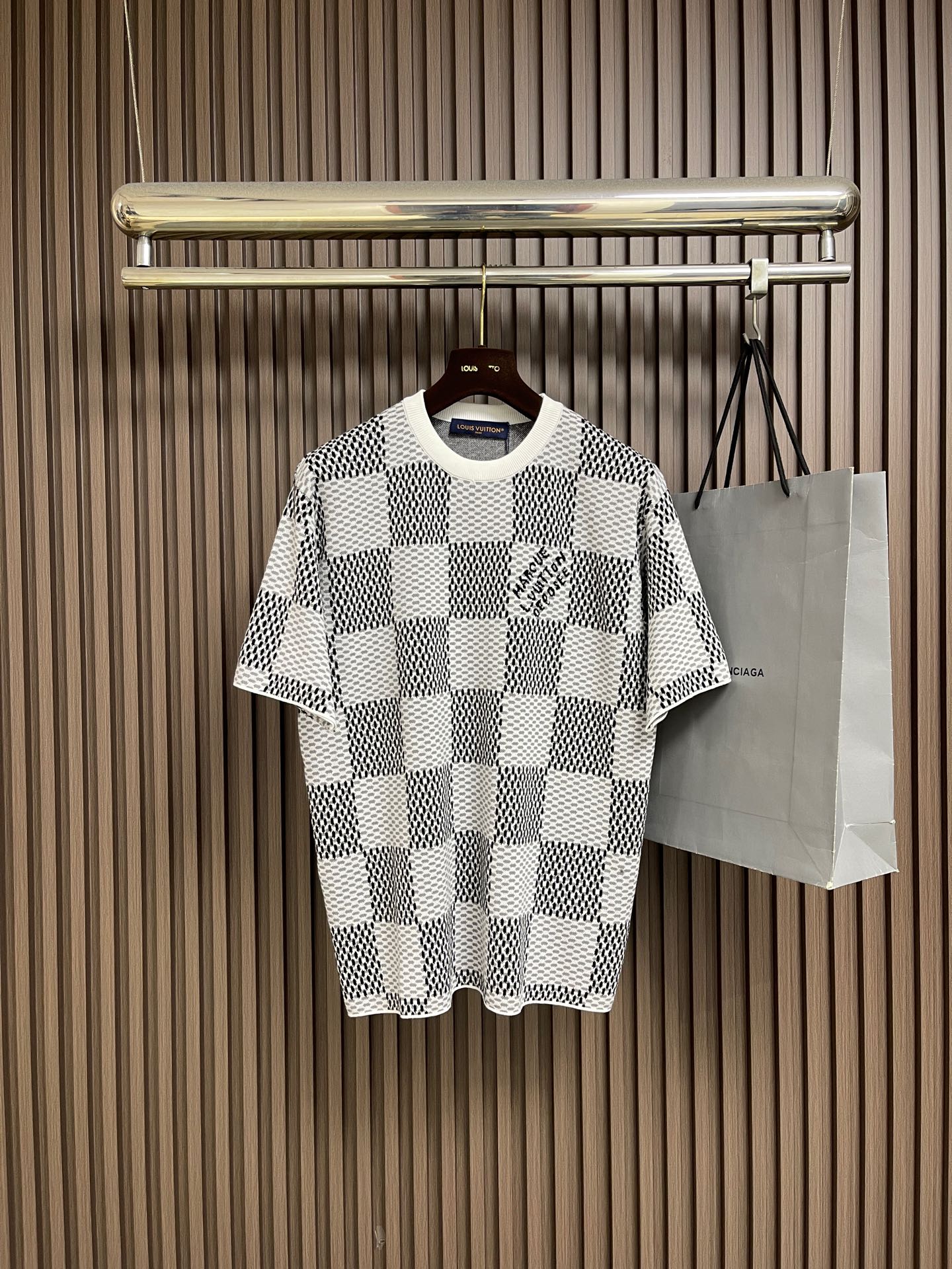 NO:835042,LV classic checkerboard jacquard knitted short-sleeved T-shirt  It is made of specially imported high-twist cotton blended knitted fabric and woven with three-dimensional jacquard technology. It has a soft, thick and elastic texture. It is comfortable and breathable to wear and has a good drape feeling. It is not easy to pill and deform after long-term wear, ensuring the top quality and practicality of the T-shirt. The neckline adopts a double-layer rib closing design, with fine and tight hemming and is not easy to deform. It is a classic  The round neck shape fits the neck line, is simple and durable, and enhances the overall sophistication; the body is fully printed with the brand's checkerboard pattern, and the contrasting colors of black, white, green, white, and blue are fresh and advanced, breaking the monotony of the basic T-shirt and adding a sense of luxury recognition and fashionable design. The handwritten brand logo is printed on the chest, and the details highlight low-key luxury. Sizes S-XL  S size chest 108 shoulder width 44 length 69 M size chest 112 shoulder width 46 length 71 L size chest 116 shoulder width 48 length 73 XL size bust 120 shoulder width 50 length 75, Louis Vuitton, T-shirt, tees, t-shirt,19860909LV 经典棋盘提花针织短袖T恤 采用进口特供高捻棉混纺针织面料,经立体提花工艺编织,质地软糯厚实且弹性极佳,穿着舒适透气同时具备良好的垂坠感,久穿不易起球变形,保证了T恤的顶级品质与实穿度；领口采用双层罗纹收口设计,包边细腻紧密且不易变形,经典圆领造型贴合颈部线条,简约耐看提升整体精致度；衣身满印品牌棋盘格图案,黑白绿白蓝绿撞色配色清新高级,打破基础T恤的单调感,增添了奢华辨识度与时尚设计感,胸口位置印有手写体品牌标识,细节处彰显低调奢华.尺码S-XL S码 胸围108 肩宽44衣长69 M码胸围112肩宽46衣长71 L码 胸围116肩宽48衣长73 XL码胸围120 肩宽50 衣长75,,louis vuitton,T-shirt,tees，t-shirt,,Men's clothing