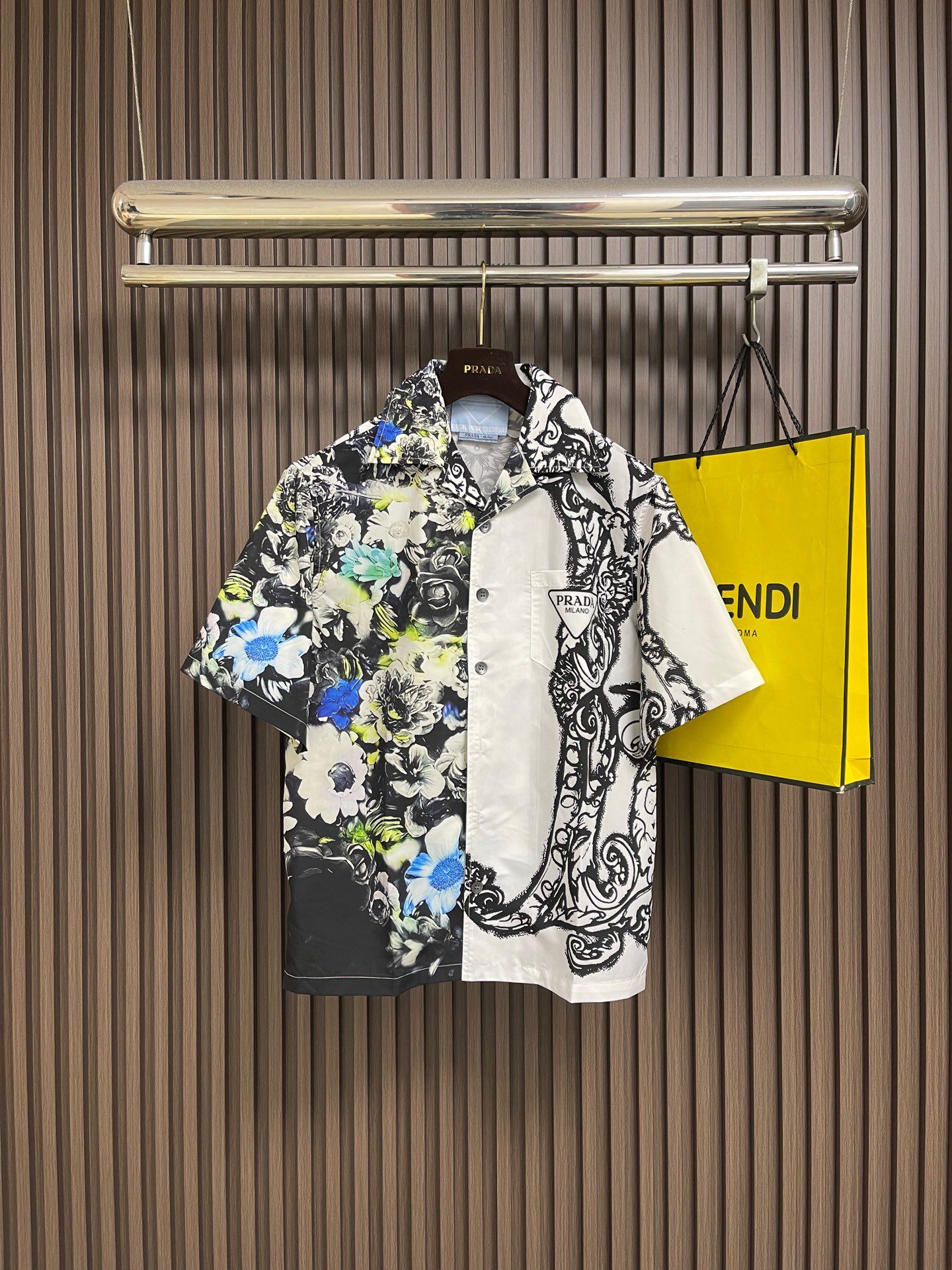 NO:836088,PRADA  Asymmetrical contrasting printed short-sleeved shirt, made of imported high-count mercerized twill cotton fabric, with a delicate and smooth touch, excellent wrinkle resistance and drape, the upper body is refreshing and breathable, and has a high-end matte texture; it adopts a Cuban lapel design, and the collar is neat and comfortable  Exhibiting, it modifies the neck line while bringing a relaxed retro style; the body adopts an asymmetric contrasting color design, and the left half is based on a black base, which is decorated with realistic floral prints. The blue and white flowers are clearly layered, and the color transition is natural, restoring the fresh texture of the flowers.  ; The right half uses pure white as the background color, with a hand-painted black curly grass pattern. The lines are smooth and flexible, forming a strong visual contrast with the left side, creating a personalized and pioneering artistic atmosphere; the cuffs and hem are made of double-line hemming technology, with fine and even stitches.  The edges are reinforced while improving the overall sophistication. Every printing connection is carefully controlled, showing the brand's ultimate pursuit of craftsmanship. It can easily adapt to a variety of wearing scenarios and create a trendy combination with both high-end and individuality. Sizes 46-52  S-XL 46, shoulder width 48.8, bust 112, length 68, size 48, shoulder width 50, bust 116, length 69.5, size 50, shoulder width 51.2, bust 120, length 71, size 52, shoulder width 52.4, bust 124, length 72.5,,prada,shirts,T-shirt,19860909PRADA 不对称撞色印花短袖衬衫,甄选进口高支丝光斜纹棉面料,触感细腻顺滑,兼具优越的抗皱性与垂坠感,上身清爽透气,自带高级哑光质感；采用古巴翻领设计,领型利落舒展,修饰颈部线条的同时自带松弛的复古格调；衣身采用不对称撞色设计,左半边以黑底为基底,铺陈写实花卉印花,蓝白花朵层次分明,色彩过渡自然,还原花卉的鲜活质感；右半边以纯白为底色,搭配手绘风黑色卷草纹图案,线条流畅灵动,与左侧形成强烈视觉反差,打造个性先锋的艺术氛围；袖口及下摆处采用双线包边工艺,针脚细密均匀,加固边缘的同时提升整体精致度,每一处印花衔接都经过精细把控,尽显品牌对工艺的极致追求,轻松适配多种穿搭场景,打造兼具高级感与个性的潮流搭配.尺码46-52 S-XL 46码 肩宽48.8 胸围112衣长68 48码 肩宽50 胸围116衣长69.5 50码 肩宽51.2胸围120 衣长71 52码 肩宽52.4 胸围124 衣长72.5,,prada,shirts,T-shirt,,Men's clothing