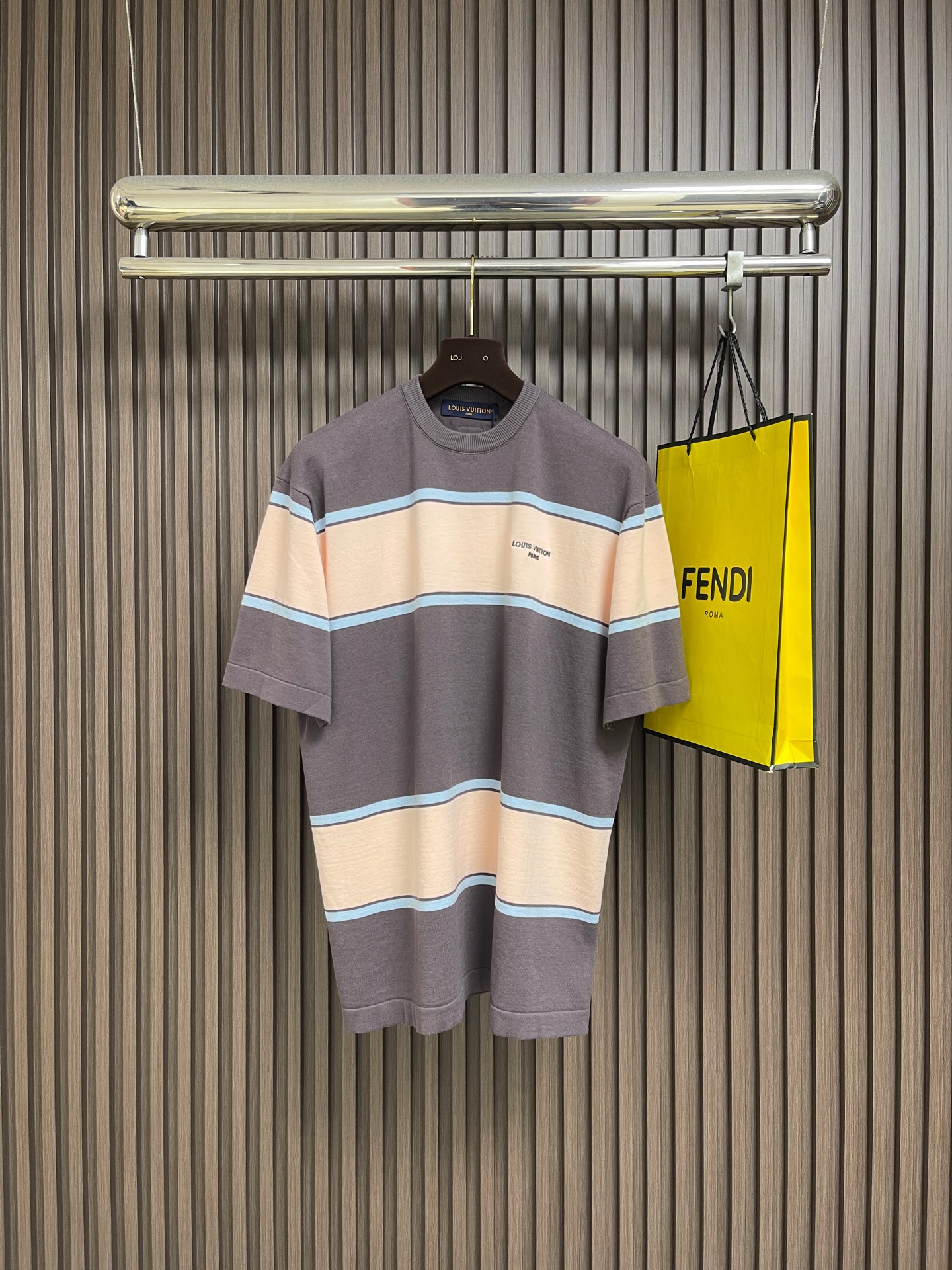 NO:835074,LV letter logo color block striped knitted short-sleeved T-shirt, this LOUIS VUITTON  FW26 round neck striped short-sleeved T-shirt is made of high-count combed cotton fabric. It has been pre-shrunk and bio-enzyme polished. It feels soft and skin-friendly and will not easily deform after long-term wear. It has excellent breathability and perspiration, and is suitable for daily wear in multiple scenarios.  Designed with classic contrasting wide stripes, the color blocks are accurately aligned with precision flat screen printing technology, and the color fastness is full, and it will still look as bright as new after repeated washing. The neckline adopts double-layer rib reinforcement technology, and is matched with contrasting edges of the same color, so that it will not become loose after long-term wear.  , fits the neck more comfortably. The stitching follows the brand's strict standards, using four-needle and six-thread boneless suture technology, and double seams at stress-bearing areas such as the rotator cuffs and side seams to eliminate the risk of open threads. The left chest is decorated with the brand's iconic mini embroidery logo, with fine stitching  It is densely three-dimensional, with high-end texture in every detail. The overall cut is loose and neat, taking into account both casualness and brand recognition. It is a luxury item with both practical wearability and design. The overall routing is straight and delicate, the fabric is comfortable and soft, and the color is consistent without color difference.  It can be matched with the same style to create a fashionable look, and can be used in various occasions. Customized accessories, complete with three standards, same style for men and women!  Size S-XL S size bust 108 shoulder width 44 length 66 M size bust 112 shoulder width 46 length 68 L size bust 116 shoulder width 48 length 7019860909LV 字母标识拼色条纹针织短袖T恤,这件LOUIS VUITTON FW26圆领条纹短袖T恤,甄选高支精梳棉面料打造,经预缩水处理与生物酶抛光工艺,触感柔软亲肤且久穿不易变形,透气排汗性优异,适配日常多场景穿着.采用经典撞色宽条纹设计,以精密平网印花工艺实现色块精准对位,色牢度拉满,反复洗涤仍鲜亮如新.领口采用双层罗纹加固工艺,搭配同色系撞色包边,久穿不松垮,贴合颈部更舒适.走线遵循品牌严苛标准,采用四针六线无骨缝合技术,肩袖、侧缝等受力处双重锁边,杜绝开线隐患.左胸饰以品牌标志性迷你刺绣标识,针脚细密立体,细节处彰显高级质感,整体剪裁宽松利落,兼顾休闲感与品牌辨识度,是兼具实穿性与设计感的奢品单品.整体走线平直细腻,面料舒适柔软,颜色一致无色差 能与同款搭配营造时尚造型,驾驭各种场合,定制辅料,三标齐全,男女同款！尺码S-XL S码 胸围108 肩宽44衣长66 M码胸围112肩宽46衣长68 L码 胸围116肩宽48衣长70 XL码胸围120 肩宽50 衣长72,,louis vuitton,louis vuitton,T-shirt,tees，t-shirt,,Men's clothing