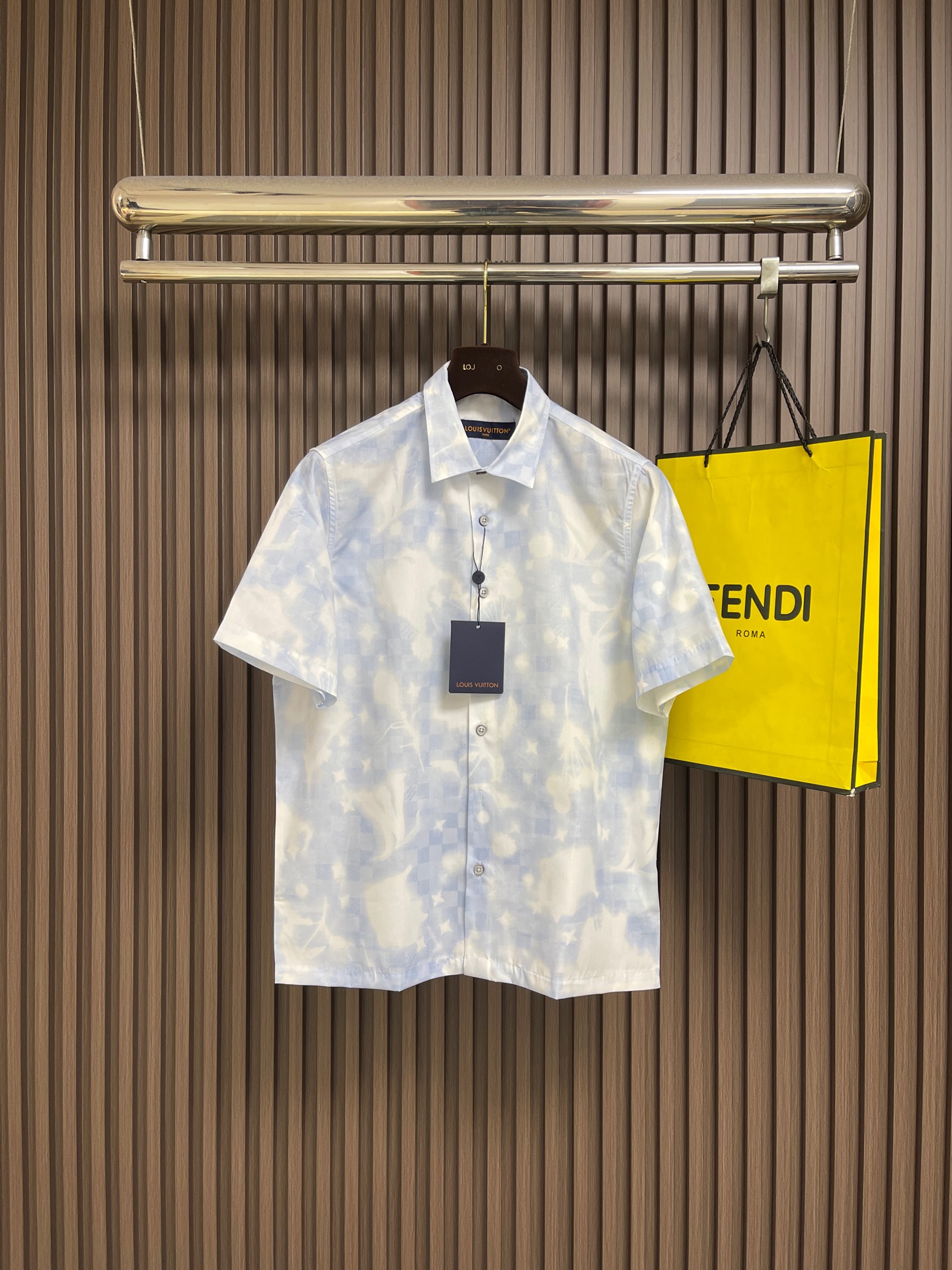 NO:836057,LV overprint logo printed short-sleeved shirt, this LOUIS  VUITTON overprinted logo-printed short-sleeved shirt is made of high-quality fabrics. It feels soft and smooth, has good drape and breathability, and is refreshing and comfortable to wear. It uses fine digital printing technology to cleverly combine the brand's classic logo with the blue and white blooming pattern. The colors are rich and not easy to fall off and deform. The classic lapel is matched with a single-breasted placket design, and the lines are neatly routed.  It is dense and has meticulous hemming technology, showing exquisite workmanship. The back is embellished with a brand logo leather tag, low-key highlighting the brand texture. The loose fit is suitable for a variety of body shapes, and can be easily managed for daily wear or casual travel. It is both fashionable and practical. It is recommended to hand wash and care to keep the clothes in good condition. The overall wiring is straight and delicate, the fabric is comfortable and soft, and the color is consistent without color difference.  It can be matched with the same style to create a fashionable look, and can be used in various occasions. Customized accessories, complete with three standards, same style for men and women!  Size S-XL S size Bust 114 Shoulder width 43.5 Length 69 Medium Bust 118 Shoulder width 45 Length 71 L Size Bust 122 Shoulder width 46.5 Length 73 XL Bust 126 Shoulder width 48 Length 7519860909LV 叠印标识印花短袖衬衫,这款LOUIS VUITTON叠印标识印花短袖衬衫,甄选优质面料打造,触感柔软顺滑,兼具良好垂坠感与透气性,穿着清爽舒适.采用精细数码印花工艺,将品牌经典标识与蓝白晕染图案巧妙融合,色彩层次丰富,不易脱落变形.经典翻领搭配单排扣门襟设计,走线工整密实,锁边工艺细致,展现精湛做工.背部点缀品牌标识皮牌,低调彰显品牌质感.宽松版型剪裁适配多种身形,日常穿搭或休闲出行都能轻松驾驭,兼具时尚度与实穿性,建议手洗护理以保持衣物完好状态.整体走线平直细腻,面料舒适柔软,颜色一致无色差 能与同款搭配营造时尚造型,驾驭各种场合,定制辅料,三标齐全,男女同款！尺码S-XL S码 胸围114肩宽43.5 衣长69 M码胸围118肩宽45 衣长71 L码 胸围122 肩宽46.5衣长73 XL码胸围126 肩宽48衣长75,,louis vuitton,louis vuitton,shirts,T-shirt,,Men's clothing