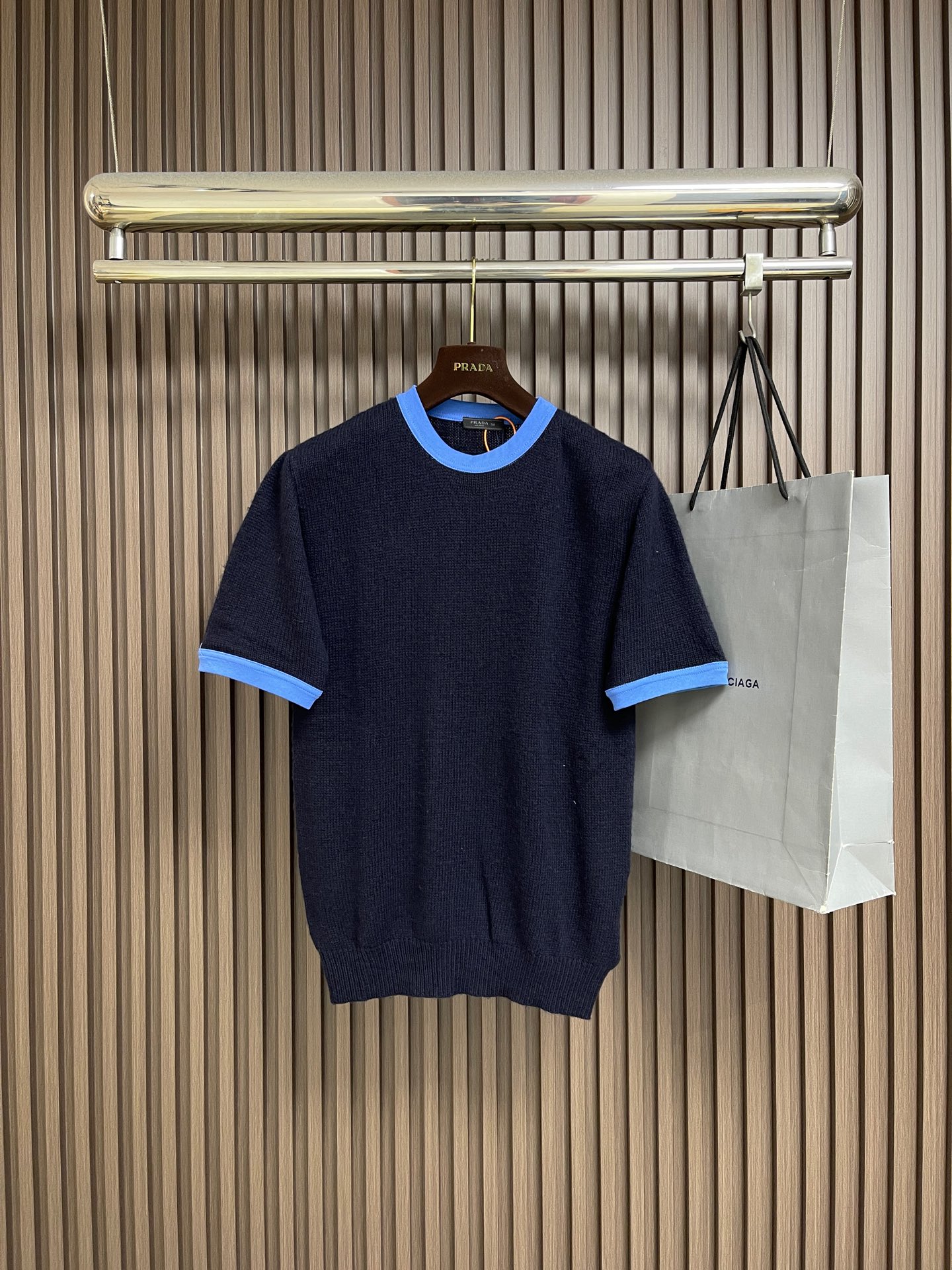 NO:842671,Prada triangle logo short-sleeved knitted T-shirt sweater, custom-woven night blue cloud cashmere, light and fluffy, soft and waxy cloud feel. Charcoal gray brown tone, with effortless old money aesthetic nobility, sky blue contrast rib, outlines just the right sense of sophistication. The iconic triangle logo is embellished on the back, low-key yet dignified, and is an elegant continuation of the brand DNA. The neat tailoring hides the flesh and makes you slim, adapts to all body shapes, and easily creates the golden ratio of short top and long bottom. Perfect interpretation of old money style less is  more's dressing philosophy, showing relaxation and casualness. The custom-made special knitting machine is manually controlled by craftsmen and the human-machine collaborative knitting logic adjusts yarn tension in real time and controls the rise and fall of knitting needles to form the Prada triangle logo with a three-dimensional concave and convex texture. Professional equipment is paired with exclusive detergents to deeply clean and remove odors, optimizing fabric softness and wearing experience. The overall wiring is straight and delicate, the fabric is comfortable and soft, and the color is consistent without color difference.  It can be matched with the same style to create a fashionable look, and can be used in various occasions. Customized accessories, complete with three standards, same style for men and women!  Size S-XL 48-54, size 48 bust 96, shoulder width 41, length 64, size 50 bust 100, shoulder width 42.5, length 66, size 52 bust 104, shoulder width 44, length 68, size 54 bust 108, shoulder width 45.5, length 70, prada, sweaters, T-shirt, tees, t-shirt, gold,19860909Prada 三角徽标短袖针织T恤毛衣,定织夜澜云絮羊绒,轻盈蓬松,软糯云感.炭灰棕调,自带不费力的老钱美学贵气感,天蓝色撞色罗纹,勾勒恰到好处的精致感.标志性三角徽标点缀于后背,低调不又显贵,是品牌DNA的优雅延续.利落剪裁藏肉显瘦,适配所有身形,轻松打造上短下长的黄金比例.完美诠释老钱风less is more的穿搭哲学,尽显松弛随性.通过匠人手工操控定制化专用编织机 人机协同的编织逻辑,实时调整纱线张力,控制织针起落,形成具有立体凹凸肌理的Prada三角徽标.专业设备搭配专属洗涤剂,深度清洁去味、优化面料柔软度与穿着体感.整体走线平直细腻,面料舒适柔软,颜色一致无色差 能与同款搭配营造时尚造型,驾驭各种场合,定制辅料,三标齐全,男女同款！尺码S-XL 48-54 48码胸围96 肩宽41衣长64 50码胸围100肩宽42.5衣长66 52码胸围104肩宽44衣长68 54码胸围108肩宽45.5 衣长70,,prada,sweaters,T-shirt,tees，t-shirt,gold,,Men's clothing
