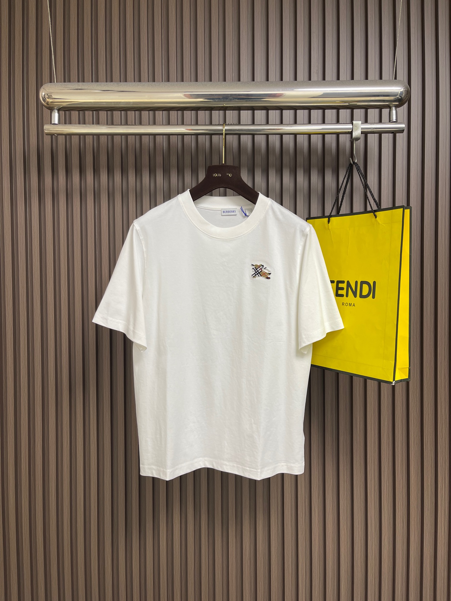NO:842644,Burberry  Plaid toothbrush embroidered round neck short-sleeved T-shirt, made of 15-count special-spun compact cotton, 230g㎡; matched with 32-count 1×1 rib, 340g㎡. The fabric is a heavy-weight fabric with thick needles, strong texture, and crisp texture. Because the 15-count yarn is thicker, the shaping process is particularly important, as it can eliminate  The internal stress generated during the weaving process of thick yarns prevents pattern misalignment due to shrinkage of the fabric during subsequent multi-layer printing. The collar is made of high-density tight ribbing made of cotton, which is elastic through high-density weaving and has a more pure and natural touch. The equestrian knight logo uses tufted three-dimensional toothbrush thorns.  Embroidery technology, which is characterized by dense and straight piles, soft to the touch like velvet, and clear edge outlines. This is an embroidery technique that uses special needles to embed embroidery threads into bundles into the base fabric, forming an upright-like pile effect. The embroidery needle pierces the fabric with high-speed reciprocating motion, and embroiders multiple strands of embroidery thread simultaneously.  Bring it in and form a coil; after the embroidery is completed, the back is coated with water-based adhesive to fix the bottom of the coil, and the top of the coil is cut and trimmed to a uniform height through a shearing process to form an upright texture similar to toothbrush bristles. The overall wiring is straight and delicate, the fabric is comfortable and soft, and the color is consistent without color difference.  It can be matched with the same style to create a fashionable look, and can be used in various occasions. Customized accessories, complete with three standards, same style for men and women!  Sizes S-XL S size, bust 104, shoulder width 45, length 69, size M, bust 108, shoulder width 46.5, length 71, size L, chest size 112, shoulder width 48, length 73, size XL, chest size 116, width 49.5, length 75, burberry, T-shirt, tees, t-shirt,19860909Burberry 格纹牙刷绣圆领短袖T恤,用15支特纺紧密棉,230g㎡；搭配32支1×1罗纹,340g㎡.面料属于粗针重克重面料,肌理感强、质地挺括.由于15支纱线较粗,定形工序尤为重要,它能消除粗支纱线织造过程中产生的内应力,防止后续多层印花时因面料收缩导致图案错位.衣领属于全棉高密度紧实罗纹,全棉罗纹通过高密度织造实现弹性,触感更加纯粹自然.马术骑士徽标采用簇绒立体牙刷刺绣工艺,该工艺的特点是绒毛密实挺拔、触感柔软如天鹅绒、边缘轮廓清晰.这是一种通过特殊针具将绣线成束植入底布、形成竖立状绒毛效果的刺绣技法.刺绣针以高速往复运动刺穿面料,将多股绣线同时带入并形成线圈；刺绣完成后,背面涂覆水性背胶固定线圈底部,正面则通过剪毛工序将线圈顶部剪开并修剪至统一高度,形成类似牙刷毛束的直立质感.整体走线平直细腻,面料舒适柔软,颜色一致无色差 能与同款搭配营造时尚造型,驾驭各种场合,定制辅料,三标齐全,男女同款！尺码S-XL S码 胸围104肩宽45 衣长69 M码胸围108肩宽46.5 衣长71 L码 胸围112 肩宽48 衣长73 XL码胸围116 肩宽49.5 衣长75,,burberry,T-shirt,tees，t-shirt,,Men's clothing