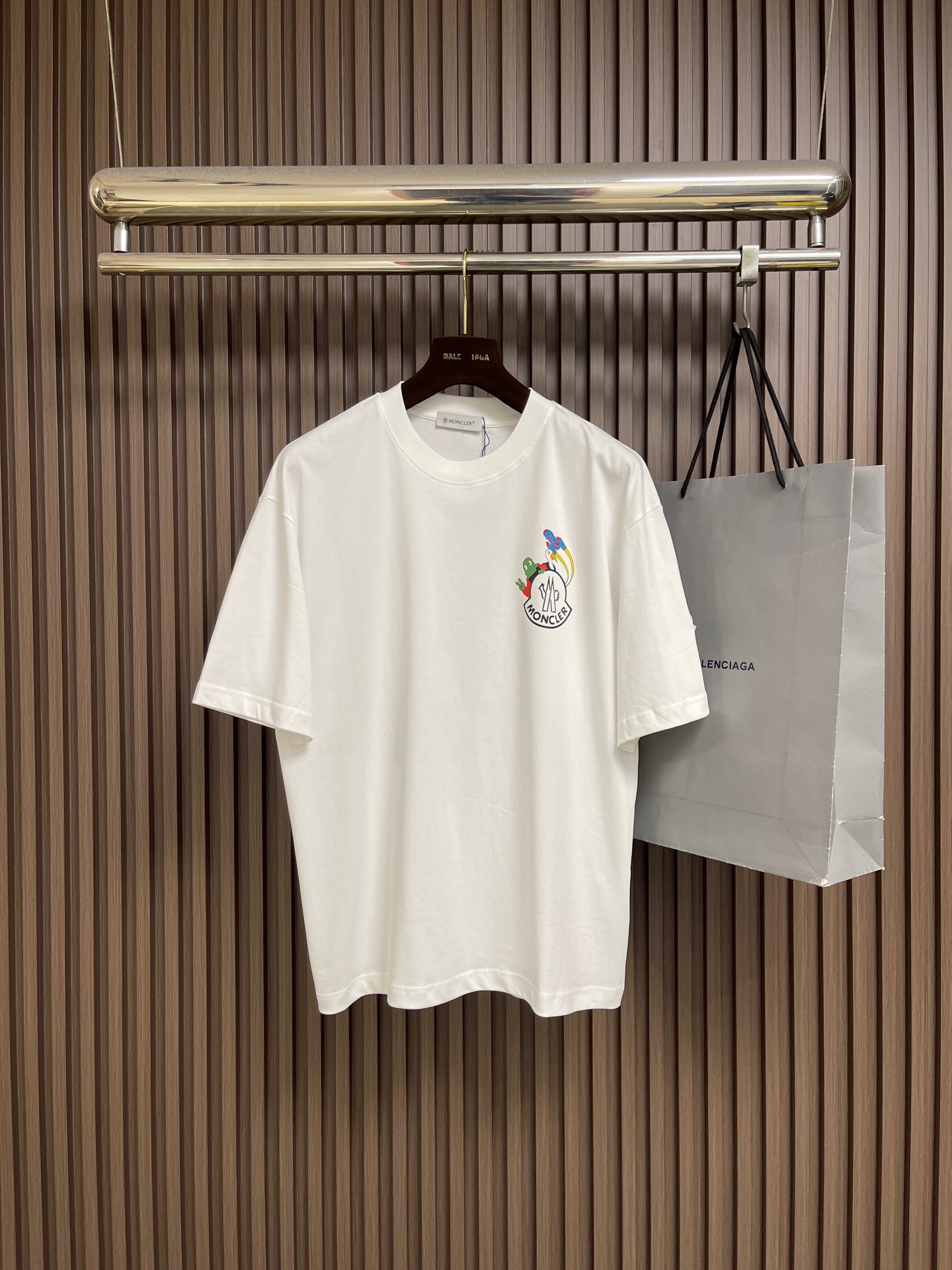 NO:839882,Moncler  Glue printed pattern round neck pullover short-sleeved T-shirt. This white short-sleeved shirt is made of high-count combed cotton fabric, treated with ammonia pre-shrinking and mercerization process. It feels smooth and skin-friendly, breathable and sweat-absorbent and has excellent wrinkle resistance. The color fastness reaches level 4 or above.  , not easy to yellow and deform after long-term washing. The neckline is made of high-elastic ribbing with three-needle hemming technology, which is not easy to loosen and curl after repeated wear; the side seams of the body are made of double-needle embedded clip technology, which ensures smooth and firm routing and reduces skin friction. Chest  The front brand logo adopts imported glue printing process, the pattern is clear and delicate, has strong adhesion, and is not easy to crack and fall off; the cuffs and hem adopt the flat seam sewing process, the stitching is fine and even, and there are no excess threads. The ready-made garments undergo multiple quality inspection processes such as stitching, ironing, and decontamination. The version is loose and comfortable, suitable for daily commuting, leisure travel and other scenes, with both simple texture and practical wearability. The overall wiring is straight and delicate, the fabric is comfortable and soft, and the color is consistent without color difference.  It can be matched with the same style to create a fashionable look, and can be used in various occasions. Customized accessories, complete with three standards, same style for men and women!  Sizes M-XXL M size bust 110 shoulder width 51.5 length 71 L size bust 114 shoulder width 52.5 length 7319860909Moncler 胶浆印花图案圆领套头短袖T恤,这款白色短袖采用高支精梳棉面料,经氨预缩与丝光工艺处理,触感柔滑亲肤,透气吸汗且抗皱性优异,色牢度达4级以上,久洗不易发黄变形.领口采用高弹力罗纹搭配三本针包边工艺,反复穿着不易松弛卷边；衣身侧缝采用双针埋夹工艺,走线平整牢固,减少皮肤摩擦感.胸前品牌标识采用进口胶浆印刷工艺,图案清晰细腻、附着力强,不易开裂脱落；袖口与下摆采用平缝锁边工艺,针脚细密均匀,无多余线头.成衣经针、整烫、去污等多道质检工序,版型宽松舒适,适配日常通勤、休闲出游等多种场景,兼具简约质感与实穿性.整体走线平直细腻,面料舒适柔软,颜色一致无色差 能与同款搭配营造时尚造型,驾驭各种场合,定制辅料,三标齐全,男女同款！尺码M-XXL  M码 胸围110 肩宽51.5 衣长71 L码 胸围114 肩宽52.5 衣长73  XL码 胸围118 肩宽53.5 衣长75 XXL码 胸围122 肩宽54.5 衣长76,,T-shirt,tees，t-shirt,,Men's clothing