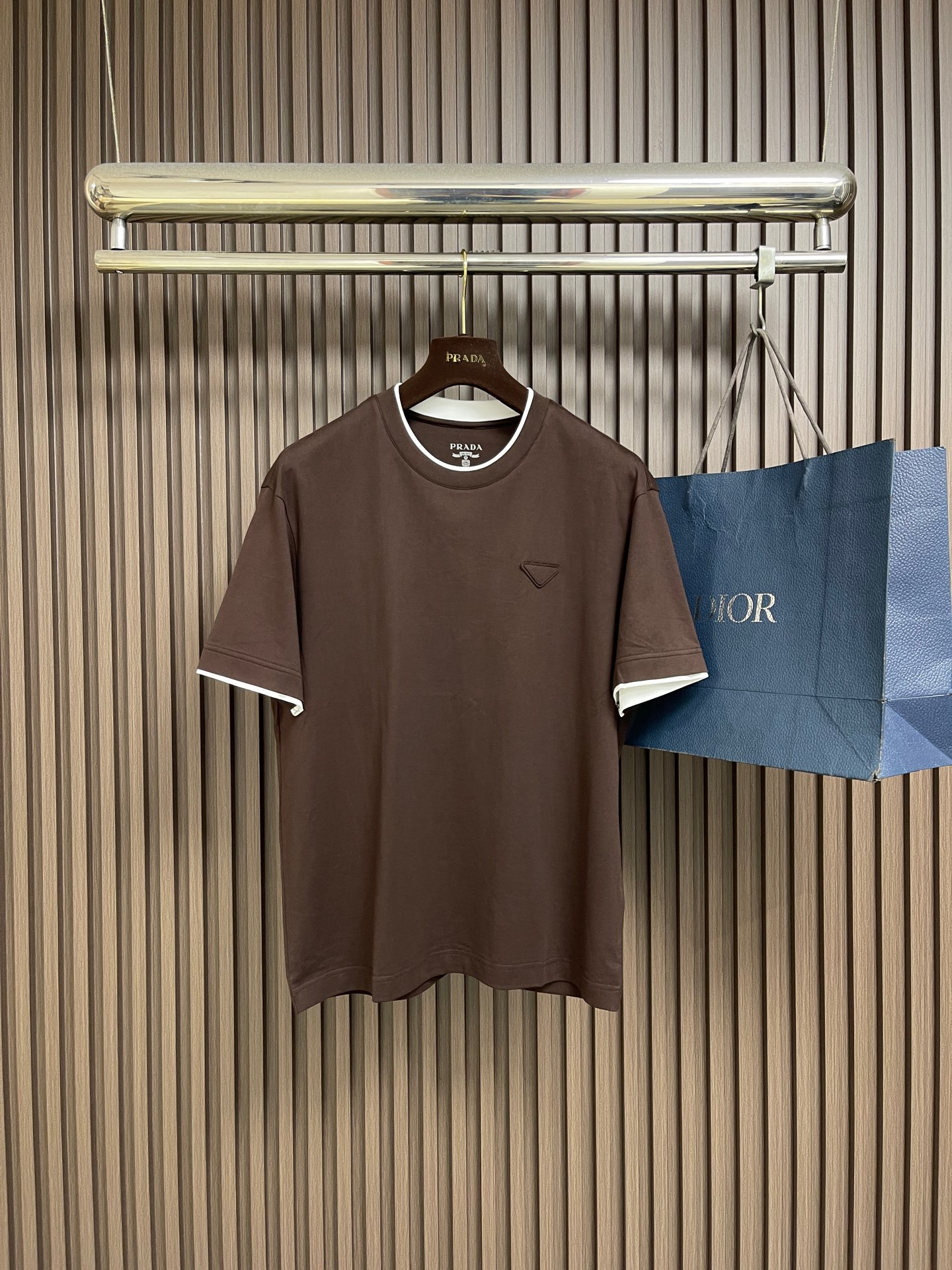 NO:848694,PRADA  Logo fake two-piece round neck short-sleeved T-shirt. The fabric is made of 24S special-spun compact cotton with 40S double yarn thread g. The compact spinning process makes the yarn highly strong, the fibers are tightly arranged, and the appearance is smooth and hairy and difficult to sand. The classic round-neck basic version adopts a fake two-piece structure with a double-layer neckline and asymmetrical hem, and side seams  The three-dimensional box-shaped outline is shaped, and the color blocks collide and overlap to create a visual dislocation effect, and the design is novel and unique; the triangular logo on the front chest is composited by heat pressing to form a three-dimensional thickness, and is woven with woven yarn raw materials and laser cut to restore it. The overall wiring is straight and delicate, ensuring comfortable wearing, and the fabric color is consistent without color difference!  Size 48-56,,prada,T-shirt,tees,t-shirt,19860909PRADA 标识假两件圆领短袖T恤,面料采用24S特纺紧密棉,搭配40S双纱螺纹g,紧密纺工艺使纱线强力高、纤维排列紧密、外观光洁毛羽少不易磨毛;经典圆领基础版型采用双层领口与不对称下摆的假两件结构,侧缝线塑造立体箱型轮廓,色块碰撞叠搭营造视觉错位效果,设计新颖独特;前胸三角徽标通过热压复合形成立体厚度,采用梭织成份纱线原料编织并激光切割还原,整体走线平直细腻,确保穿着舒适,且面料颜色一致无色差! 尺码48-56,,prada,T-shirt,tees，t-shirt,,Men's clothing