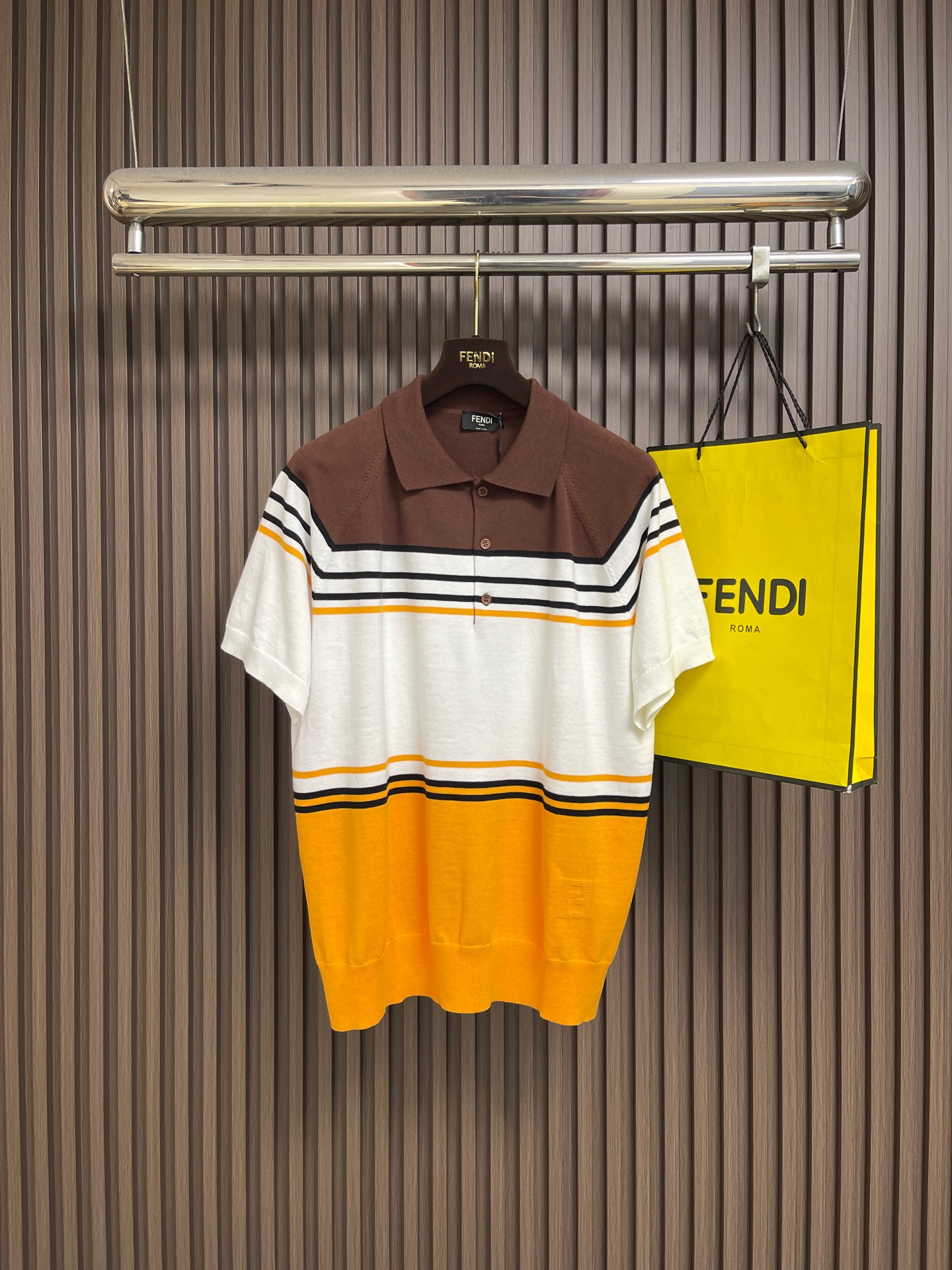 NO:848692,FENDI  The contrasting striped knitted short-sleeved Polo is made of imported high-count ice silk knitted fabric specially supplied by the brand. The texture is light and breathable, smooth and skin-friendly. It has excellent wrinkle resistance and drape. It is not easy to deform and pill after long-term wear, easily creating a wearing experience that combines comfort and style. The body adopts retro contrasting stripe splicing technology, with brown, white and orange colors.  Color gradient transition, smooth and eye-catching lines, breaking the monotony of solid colors, low-key highlighting the brand texture, adding layer and recognition to the simple body; the side hem is embellished with the brand's same-color embroidery logo, the craftsmanship is delicate and exquisite, and the brand texture is fully displayed in the details; the overall tailoring is neat and stylish, and the fit is suitable for various body shapes. Sizes S-XL  Size S, bust 108, sleeve length 20, length 68, size M, bust 112, sleeve length 21, length 70, size L, bust 116, length 22, length 72, size XL, bust 120, length 23, length 74, fendi, T-shirt,19860909FENDI 撞色条纹针织短袖Polo,采用品牌特供进口高支冰丝针织面料,质地轻薄透气,触感顺滑亲肤,兼具出色的抗皱性与垂坠感,久穿不易变形起球,轻松打造舒适与格调兼具的穿着体验；衣身采用复古撞色条纹拼接工艺,棕白橙三色渐变过渡,线条流畅醒目,打破纯色单调感,低调彰显品牌质感,为简约衣身增添层次与辨识度；侧摆处点缀品牌同色系刺绣标识,工艺细腻精致,细节处尽显品牌质感；整体剪裁利落有型,合身版型适配多元身形.尺码S-XL S码 胸围108袖长20 衣长68 M码胸围112 袖长21 衣长70 L码 胸围116 袖长22 衣长72 XL码胸围120 袖长23 衣长74,,fendi,T-shirt,,Men's clothing