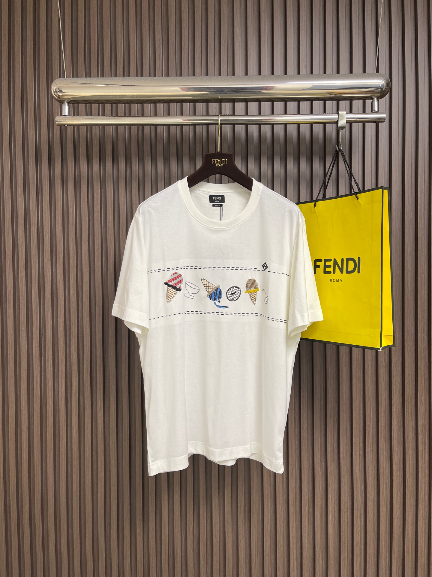 NO:845170,Fendi  Summer multi-color embroidered T-shirt with ice cream pattern elements. This FENDI ice cream themed embroidered short-sleeved T-shirt is made of high-weight, skin-friendly cotton fabric. It feels soft and delicate, breathable and absorbs sweat. The upper body is comfortable and not sweaty. It has a crisp fit and a  Draping texture. The classic round neck cut fits the neck, and the loose silhouette is not flattering and is tolerant to the body shape. The front of the body uses exquisite three-dimensional embroidery technology to create interesting ice cream, cone and other patterns. The stitches are fine and neat, and the colors are full.  It is fresh and embellished with the brand's iconic double F logo, and the details are full of high-end texture. The neckline, cuffs and hem are reinforced with double-strand wiring, and the workmanship is rigorous and elegant. It is washable, durable and not easy to deform. The overall design is fresh and smart, integrating the brand's classic elements with fun creativity, and is suitable for daily commuting, leisure travel and other scenarios. It is a versatile item that is both fashionable and practical, making it easy to create a trendy look. The overall wiring is straight and delicate, the fabric is comfortable and soft, and the color is consistent without color difference.  It can be matched with the same style to create a fashionable look, and can be used in various occasions. Customized accessories, complete with three standards, same style for men and women!  Size S-XL S size bust 110 shoulder width 49 length 70 medium size bust 114 shoulder width 50.5 length 71.5 L size bust 118 shoulder width 52 length 7319860909Fendi 夏日多色冰激淋图案元素绣花T恤,这件FENDI冰淇淋主题刺绣短袖T恤,甄选高克重亲肤棉面料,触感柔软细腻,透气吸汗,上身舒适不闷汗,兼具挺括版型与垂坠质感.经典圆领剪裁贴合颈部,宽松廓形不挑身形,对身材包容度高.衣身正面采用精致立体刺绣工艺,打造趣味冰淇淋、甜筒等图案,针脚细密工整,色彩饱满鲜活,搭配品牌标志性双F徽标点缀,细节尽显高端质感.领口、袖口与下摆采用双股走线加固,做工严谨考究,耐洗耐穿不易变形.整体设计清新灵动,将品牌经典元素与趣味创意融合,适配日常通勤、休闲出行等多场景,是兼具时尚感与实穿性的百搭单品,轻松打造潮流造型.整体走线平直细腻,面料舒适柔软,颜色一致无色差 能与同款搭配营造时尚造型,驾驭各种场合,定制辅料,三标齐全,男女同款！尺码S-XL S码 胸围110 肩宽49 衣长70 M码胸围114 肩宽50.5衣长71.5 L码 胸围118 肩宽52 衣长73 XL码胸围122 肩宽53.5 衣长74.5,,fendi,T-shirt,tees，t-shirt,,Men's clothing