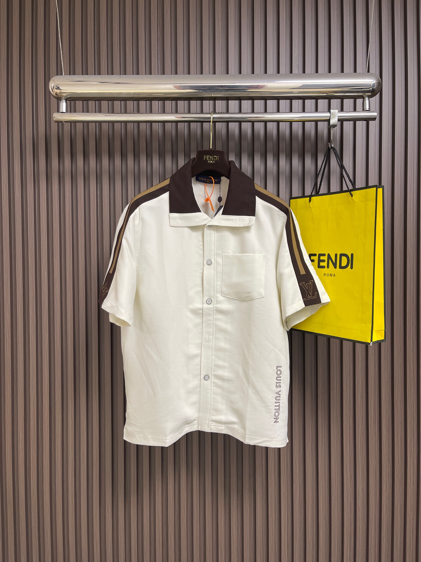 NO:845097,LV  Contrast color embroidered short-sleeved shirt jacket, classic off-white background color with dark brown retro contrast collar and side webbing, contrasting color transition is high-end and soft, directly filling the light and luxurious retro atmosphere; neat retro lapels fit the neck line, optimizing the head and shoulder ratio to show a tall and straight figure; precision workmanship  The whole placket is paired with chest patch pockets, and every stitch is placed with the utmost care; the sleeves are embroidered with three-dimensional brand exclusive logos and letters, and the stitching is dense and exquisite, with a full three-dimensional feel. It low-key releases the exclusive luxury heritage of big brands, and the details are full of top-notch craftsmanship. Sizes S-XL  S size bust 116 shoulder width 48 length 68 medium size bust 120 shoulder width 49.5 length 70 L size bust 124 shoulder width 51 length 7219860909LV 撞色刺绣短袖衬衫外套,经典米白底色搭配深棕色复古撞色领边与侧边织带,撞色过渡高级柔和,轻奢复古氛围感直接拉满；利落复古翻领贴合颈部线条,优化头肩比例尽显挺拔身姿；精密工整的门襟排扣搭配胸前贴袋,每一针走线都极致考究；袖身立体品牌专属标识与字母刺绣,针脚密实精致、立体感十足,低调释放专属大牌奢华底蕴,细节之处尽显顶级匠心工艺.尺码S-XL S码胸围116 肩宽48衣长68 M码 胸围120 肩宽49.5衣长70 L码胸围124 肩宽51 衣长72 XL码 胸围128 肩宽52.5 衣长74,,louis vuitton,jackets & coats,shirts,T-shirt,,Men's clothing