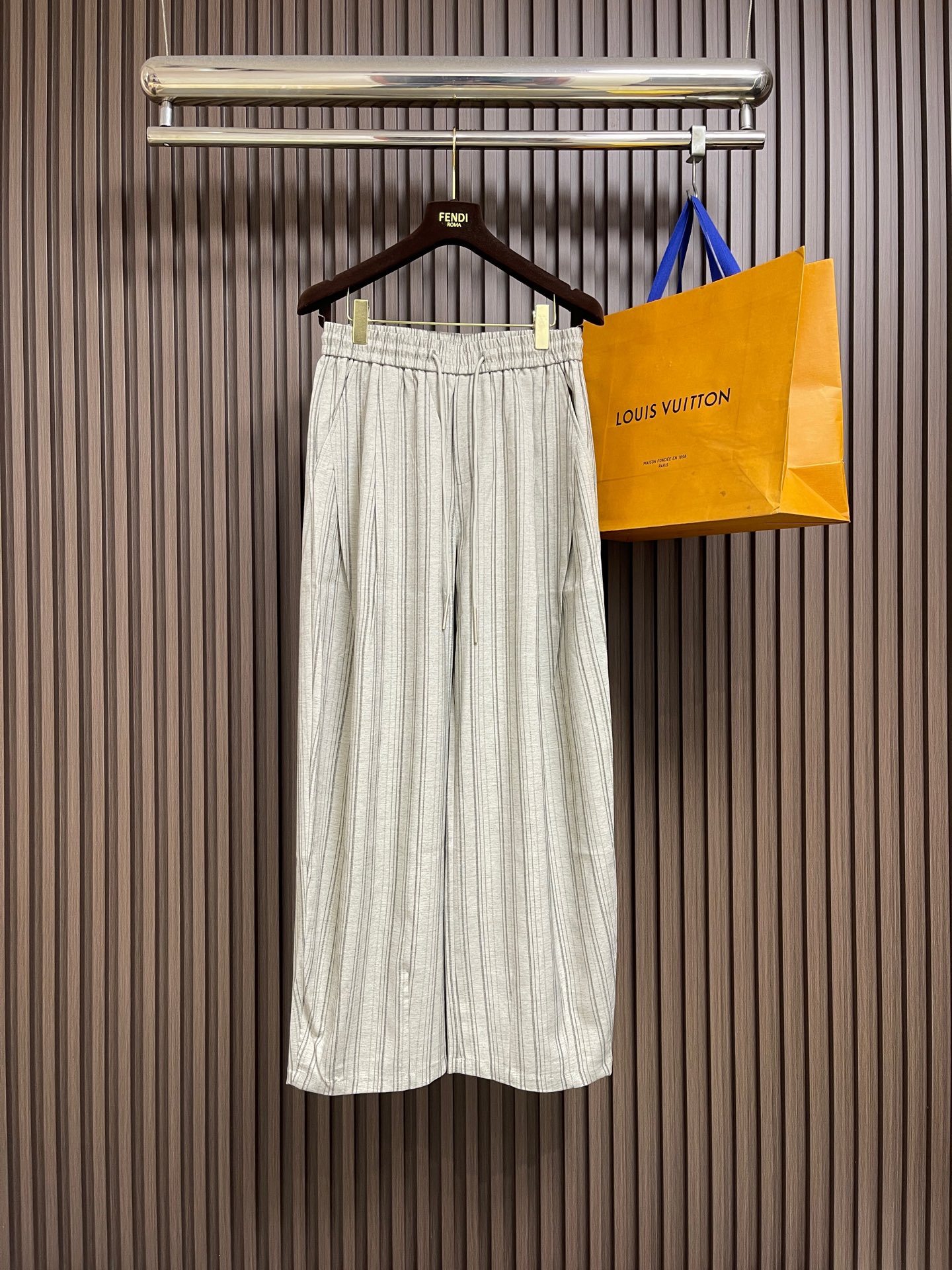 NO:845129,BV 2026SS  Striped wide-leg cool trousers, with an eye-catching texture ~ Selected blended cool fabrics, with breathable texture and drape, like wearing an air conditioner on the body. Custom-woven vertical stripes in dark gray and light gray are not monotonous prints, but a dark texture that blends with the fabric, giving off a delicate layered luster under the light. Elastic waist +  Customized digitally engraved metal drawstrings can be freely adjusted for tightness, and do not restrict the waist. The slightly wide scimitar trousers, with a naturally drooping line from the waist and hips to the trouser legs, perfectly modify the leg shape, hide the flesh and appear straight, and have a relaxed feeling when walking, which is a comfort that suit trousers cannot give. The front and rear double pocket design takes into account both practicality and style.  The waistband has been made loose and tight + hemming process, so it will not curl up when worn for a long time. The inner side has been smoothly hemmed to ensure zero friction when worn next to the skin. The customized metal drawstring head is engraved with a number logo. The matte texture is high-end but not cheap, and perfectly echoes the color of the trousers. Sizes XS-L  Pants length 108, L size, waist 86, leg 82, trouser length 109,,bottega veneta,business suit,19860909BV 2026SS 条纹阔腿清凉裤,一眼沦陷的肌理质感~甄选混纺清凉面料,自带透气肌理与垂坠感,像把空调穿在身上.深灰浅灰两色定织竖条纹,不是单调印花,而是和面料融为一体的暗纹肌理,在光线下泛着细腻的层次光泽,松紧腰+定制数字刻字金属抽绳,可自由调节松紧,不挑身材不勒腰.微阔的弯刀裤型,从腰臀到裤脚的线条自然垂坠,完美修饰腿型,藏肉又显直,走路时带风的松弛感,是西装裤给不了的自在.前后双口袋设计,兼顾实用与造型感. 腰头做了加宽松紧+包边工艺,久穿不勒不卷边,内里全做了顺滑包边处理,贴肤穿着零摩擦.定制金属抽绳头刻有数字标识,哑光质感高级不廉价,和裤身色调完美呼应.尺码XS-L XS码 腰围74 腿围76 裤长106  S码 腰围78 腿围78 裤长107 M码 腰围82 腿围80 裤长108  L码 腰围86 腿围82 裤长109,,bottega veneta,business suit,,Men's clothing
